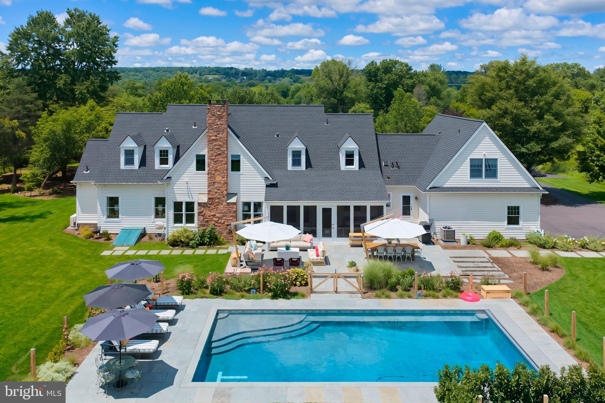 THIS LISTING INCLUDES TWO PARCELS TOTALING 10.61 ACRES: THE TURNKEY MAIN ESTATE AND A SEPARATELY DEEDED, ADJACENT 4.27-ACRE LOT.

Featured in House Beautiful, this reimagined Bucks County estate offers architectural pedigree and exceptional infrastructure. Set back over 250 feet from scenic Saw Mill Road in Solebury Township, the property backs directly to 70+ acres of protected conservation land, offering a scale of privacy hard to appreciate from photos alone

Enter via the expansive front porch into a navy-paneled two-story foyer. Sunlit interiors flow throughout, and a chef's kitchen features custom cabinetry and premium appliances. Two private offices provide exceptional flexibility for remote work. The main-level primary suite is a true retreat with dual walk-in closets and a renovated spa bath featuring heated floors, a zero-entry shower, and a soaking tub. A custom, beautiful and functional laundry and a mudroom equipped with a full bathroom for seamless indoor-outdoor transitions, complete the main level.

The upper level offers generous bedrooms, including a private princess suite. A fully finished lower level expands lifestyle amenities with dedicated spaces for fitness, a theater room, and a large recreation room. Above the attached three-car garage, a self-contained guest apartment—complete with a private bedroom, full bath, living area, and kitchenette—offers exceptional versatility for extended family or staff.

Expansive bluestone terraces overlook a new heated gunite saltwater pool, engineered for efficiency with a variable-speed pump, custom automatic cover, French Grey plaster, and integrated LED lighting. A covered porch offers al fresco dining with sunset views, and an all-weather three-season sunroom extends living space through Bucks County's changing seasons. The grounds feature a custom cedar greenhouse, fenced kitchen garden, workshop, and chicken coop. The backyard is landscaped with established native perennial gardens, sweeping lawns, and over 100 newly planted native trees for beauty and privacy throughout the year. 

Extensively updated for turnkey peace of mind, recent updates include a new roof with premium transferable warranty, high-efficiency zoned climate control (heat pumps and furnace), a catalytic converter fireplace insert, a new pool installation, EV charging, and a Generac whole-house generator.

The separately deeded 4.27-acre lot offers the option to construct an additional residence or hold it as an investment. Additionally, an approved variance, architectural plans, and a stormwater management system are already fully in place for a substantial secondary barn on the main parcel, should a future owner desire one. Neither addition is required to enjoy the estate exactly as it stands today.

Located in the New Hope-Solebury School District, the estate is moments from Carversville and New Hope. Philadelphia is under an hour away, NYC is 90 minutes, and Trenton-Mercer Airport is within 30 minutes.