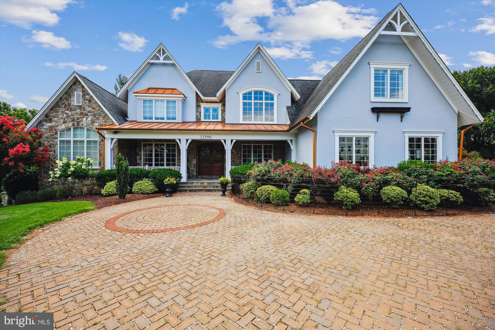 Experience exceptional craftsmanship and distinctive design in this expansive estate residence, perfectly sited on a beautifully landscaped, level lot with amazing natural views of conservation area with trees all around plus an impressive pavered driveway with extensive stonework and a remote-controlled gated entrance. With multiple luxurious living areas, a private in-law suite, and an indoor saltwater pool solarium, this remarkable home offers comfort, elegance, and unmatched versatility. A grand foyer with inlaid hardwood flooring welcomes you into a main level with expansive and elegant spaces full of special features. Highlights of this level include the gracious formal dining room with a lighted ceiling, the music room, the private office, the light-filled family room showcasing a gas fireplace and opening seamlessly to the generous kitchen. The gourmet kitchen is anchored by a massive island with two built-in sinks and features top-of-the-line Thermador appliances including a deluxe range with steamer and warmer, wall oven, microwave, second warmer, oversized range hood with warming lights and trays, refrigerator, and freezer. an ice machine —plus a pot filler with filtered water, a butler’s pantry with wine fridge, and a huge pantry with pull-outs and abundant storage space. A discreet half bath and multiple coat closets add convenience. The main-level primary suite offers a peaceful retreat featuring a lighted tray ceiling, fireplace, shutters, two walk-in closets with organizers, and private access to the solarium and its own private deck. The luxurious en-suite bath boasts granite countertops, vessel sinks, a soaking tub, dual showers with bench seating, and a private water closet with built-ins. From here, a private door leads directly into the solarium—a showstopping indoor saltwater pool spa oasis complete with color-changing lights, a hot tub, waterfall, tropical fruit trees, bench seating, and its own dedicated full bath. Upstairs, a curved staircase with wrought iron railings leads to a central lounge/music room and three spacious bedrooms. The first bedroom includes a walk-in closet and full en-suite bath. Bedrooms three and four share a beautifully tiled Jack and Jill bath and each includes roomy closets. Two stunning chandeliers controlled by a switch for easy lowering and cleaning plus a third matching chandelier in the formal dining room add elegance to the upper level. The attached private apartment has a vaulted ceiling and includes a full kitchen with Wolf induction cooktop, dishwasher, sink, microwave, full-size fridge, washer/dryer, full bath with pebble shower floor, and a walk-in closet sized for workout equipment or storage. This apartment is fully separable from the main house, via its own entrance with a reversible lock. The walk-out lower level is designed for relaxation and entertainment and features a double tray ceiling, gas fireplace, home theater with terraced reclining seating and USB ports, and a full bath. A wine cellar with wrought iron doors, a gym with built-ins and refreshment area, and an expansive storage area round out the space. A hidden all-around concrete-reinforced bomb shelter with its own large safe and concrete walls offers peace of mind. Outside, the expansive, professionally designed grounds include matching stonework, peach and apple trees, a vegetable garden, barbecue area with sunshade, an expansive pavilion space. Additional highlights include solar-powered lighting surrounding the entire backyard fence and driveway, sprinkler system, security system, a backup gas generator, new sump pump, new Geothermal water flow system, and new pool waterfall pump. A four-car garage—with two EV chargers and wiring for more—completes this exceptional offering.