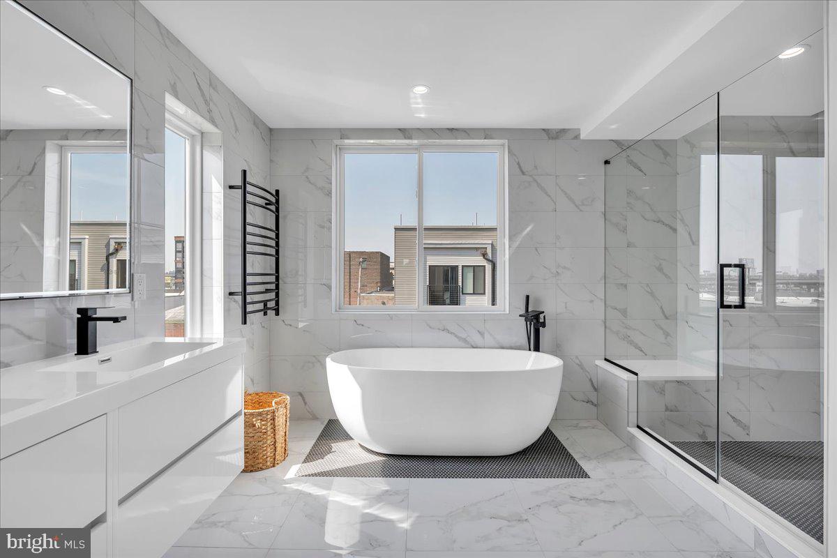Welcome to 2620 E Hagert Street, a beautifully designed 3 bed, 3 bath townhome with garage parking located in the vibrant Fishtown neighborhood. This modern corner unit offers sunlight drenched & thoughtfully crafted living space, combining clean, contemporary design with comfort and functionality —and it comes with the added benefit of a 10-year tax abatement, offering long-term savings for the new owner. 

Step inside to discover an airy open layout featuring high ceilings, wide-plank hardwood floors, and oversized windows that flood the home with natural light. The main level features a stunning custom kitchen with quartz countertops, a large island, sleek cabinetry, and stainless steel appliances. While the kitchen and living room are separated by two levels, the design maintains an open, connected feel, giving each space a distinct identity without sacrificing flow—perfect for entertaining or relaxing. Upstairs, the luxurious primary suite offers a peaceful retreat with a walk-in closet and spa-like ensuite bathroom with a double vanity, floating tub, and glass-enclosed shower. Two additional bedrooms provide ample space for guests, home offices, or growing families. The fully finished basement adds even more versatility, perfect for a media room, fitness area, or creative workspace. One of the standout features of this home is the expansive rooftop deck, offering unobstructed views of the Philadelphia skyline and Ben Franklin Bridge—an ideal spot for entertaining. 

An attached garage adds rare convenience in the city, providing secure parking and additional storage. Located on a quiet residential block just steps from the heart of Fishtown, this home offers easy access to neighborhood favorites like Reanimator Coffee, Green Eggs Café, Loco Pez, and the new Anna & Bel Hotel. With close proximity to I-95 and the L train, the location of 2618 E Hagert makes for an easy commute to anywhere in the city and surrounding areas. This is modern city living at its best—schedule your private tour today.