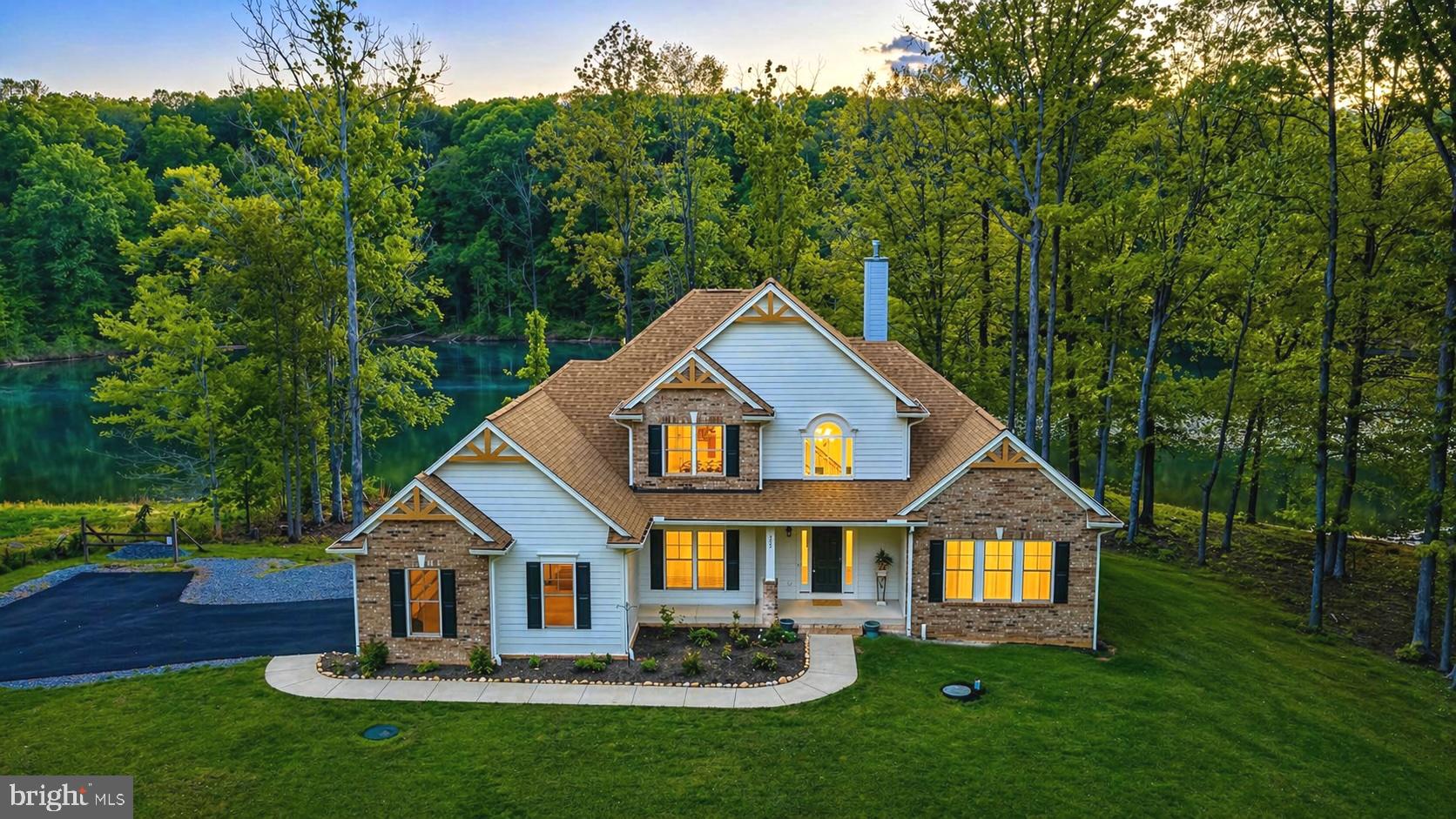 Offered fully furnished—including kayaks and garage essentials—this property is ready to be enjoyed from day one. Perched along 125 feet of shoreline in the sought-after Noah’s Landing community on the private side of Lake Anna, this fully furnished, turn-key waterfront retreat offers an effortless entry into lake living. Built in 2023 and thoughtfully positioned on a .95-acre lot, the home captures peaceful water views from a deep-water cove ideal for swimming, floating, and enjoying long summer days. Whether you’re seeking a personal escape or an investment opportunity, short-term rentals are permitted—making this property as versatile as it is inviting. Inside, an open-concept design is enhanced by 9-foot ceilings, engineered hardwood flooring, and a dramatic wall of windows that frame the lake. The family room features soaring ceilings and a gas fireplace with blower and battery backup, creating a comfortable gathering space year-round. The kitchen is both functional and refined with granite countertops, stainless steel appliances, white cabinetry, and a bright breakfast area. A main-level primary suite offers lake views and has a soaking tub, double vanity, and walk-in closet, while an additional bedroom, half bath, and laundry complete the main floor. Upstairs, two more bedrooms and a full bath provide ample space for guests. Outdoor living is just as compelling, with a reinforced composite deck designed for a future hot tub and uninterrupted views of the water. Hardiplank siding with brick accents, a paved driveway, and a two-car attached garage with an EV charger add to the home’s appeal, while features like zoned HVAC, two 50-gallon water heaters, a reverse osmosis filtration system, and an interior access walk-in conditioned crawlspace/cellar reflect thoughtful construction (This area could be finished for additional living space with some reconfiguring of the steps that lead to it). Conveniently located near local favorites like El Gran Patron and Pleasants Landing marina, it’s a refined yet relaxed setting to experience the very best of Lake Anna. See Rental Projection in MLS Documents Section.