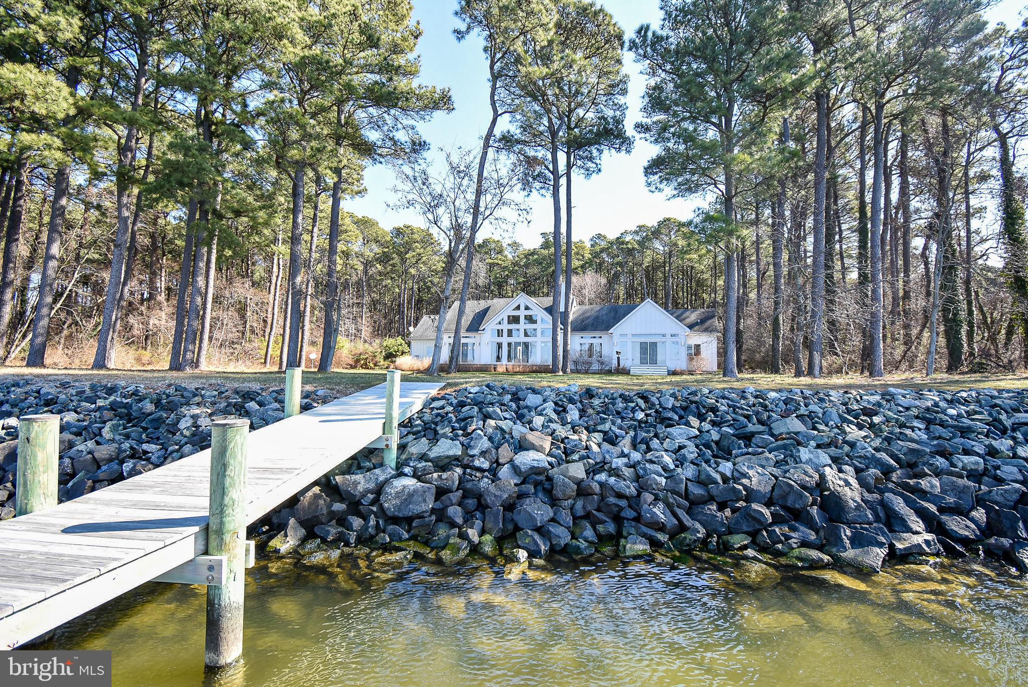 This is the one you have been waiting for!! Never been on the market. Owners had built by Willow Construction in 2011. Detached 2 car garage was added in 2013. The long gravel driveway leads you through the very private wooded lot with 12+ acres. The house cannot be seen from the road. Both garages have ample attic space. The detached garage has steps leading to the 2nd floor which hasn't been finished but has electric and water. The lot is mostly wooded with 1-1.5 acres that is mowed. Beautiful views of Poplar Island can be seen from the house which is 100 ft from the water. The yard has an underground irrigation system. This modern contemporary home is updated with Caesarstone quartz countertops, cathedral ceiling in living room, maple floors throughout, 2 master bedrooms with huge closets, Hunter Douglas shades, huge pantry, wine cooler, security system, sprinkler fire suppress system, propane fireplace, 2 hot water tanks with exhaust and garage wired for Generac generator.  Outside the yard is beautifully landscaped and maintained year-round, a drainage system, mound septic, artesian well, riprap and a pier that was installed in 2015. Tour this 12+ acre waterfront paradise in Talbot County before its gone.  Please do not wear shoes in the house.