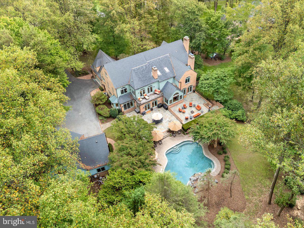 Elegant Georgian Revival Estate with Pool, Elevator, ADU & Five-Car Garage!

Experience timeless elegance in this Georgian Revival estate offering over 11,000 square feet of gross living area, with 5 bedrooms, 7.1 baths, and 6 fireplaces. Every space has been thoughtfully designed to combine classic architecture with modern luxury.

The home is introduced by a park-like setting with expansive grounds, mature landscaping, and the shadows of tall trees. Its brick front elevation is enhanced by keystone accents above the windows, brick walkways leading to the entrance, a slate-style roof, and traditional copper half-round gutters with round downspouts. At the rear, a private gated brick walkway leads to a landscaped courtyard with a bluestone patio, a decorative balcony overlooking the gardens, and a striking combination of brick and painted wood siding that adds character and dimension.

Inside, a dramatic imperial double staircase with a chandelier centerpiece makes a grand first impression. The main level offers a private in-law suite, while the primary bedroom overlooks the pool and opens to its own balcony with a fireplace. Each bedroom is served by its own full bath, ensuring comfort and privacy. The gourmet kitchen is equipped with KitchenAid appliances installed in 2013, including a five-burner gas cooktop, three wall ovens, and a built-in refrigerator. A residential elevator provides convenience and accessibility throughout all levels.

The lower level is designed for entertaining, featuring an exercise room, a spacious recreation room with a kitchenette, a den, storage, and a full bath. Outdoor living is centered around the seller’s favorite feature—a 44,000-gallon saltwater pool that is nine feet deep with a gunite finish, diving board, and waterfall. With complete wooded privacy, Rockcustic outdoor speakers, and the relaxing sound of the waterfall, this backyard feels like a private retreat.

For car enthusiasts and those in need of flexible space, the property includes garage parking for five vehicles, with a two-car attached garage and a detached three-car garage with a finished accessory dwelling unit above, perfect for guests, a studio, or office space.

This estate captures the best of both worlds—historic character and modern amenities—offering a lifestyle of comfort, luxury, and privacy in a truly park-like setting.