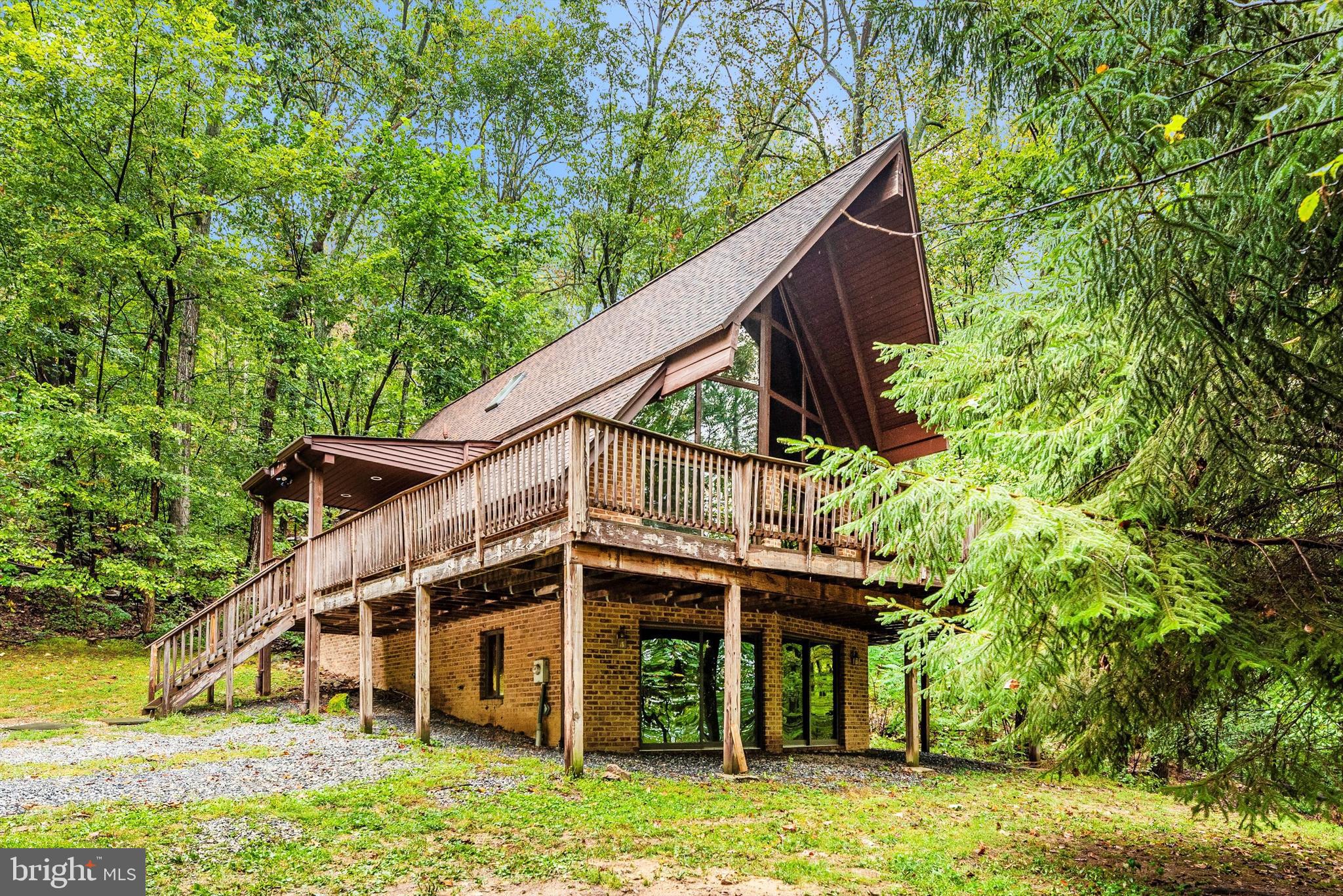 Tucked away on over 5 private acres, this chalet-style home is not your typical property  – and that’s exactly the point.  With soaring ceilings, expansive windows, and skylights throughout, the home has a great balance of natural light and surrounded by wooded views that give it a true treehouse-like feel. A cozy fireplace anchors the main living space, while hardwood floors and warm finishes add to its character. The wraparound deck extends the living space outdoors, offering a peaceful setting for morning coffee or unwinding at the end of the day. An oversized detached two-car garage provides ample space for storage, hobbies, or projects.   The kitchen has been refreshed with granite countertops and stainless steel appliances, blending modern convenience with the home’s unique style.   This is a home for someone who appreciates privacy, architecture, and a setting that feels removed from it all - while still being just 15 minutes to Middletown’s shops, dining, and Middletown Schools.  Updates include: Roof (2020), Skylights (2020), Stove & Microwave (2021), Refrigerator (2023), and Water Softener/Neutralizer (2022).