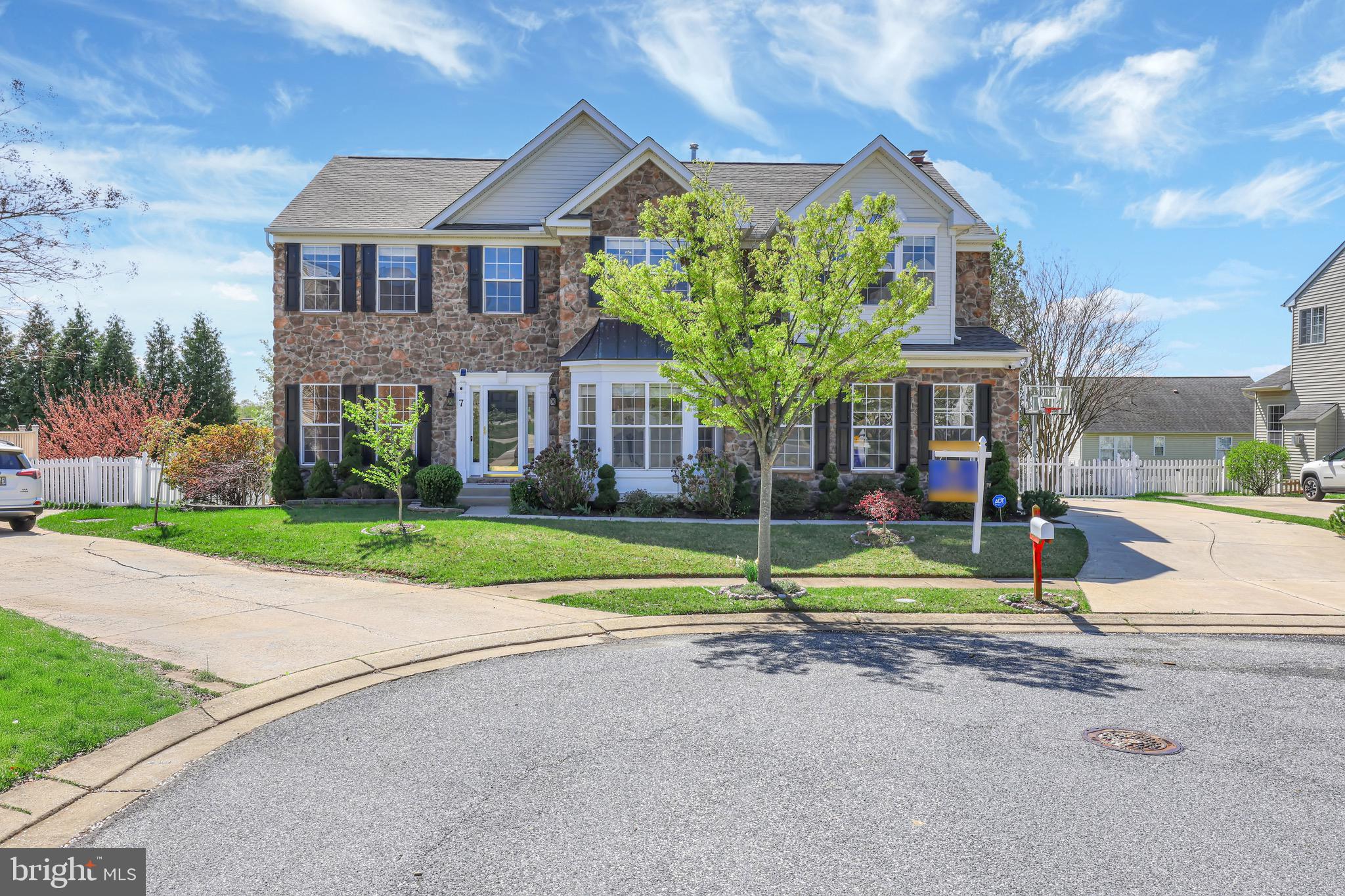 OFFER DEADLINE - SUNDAY 5 PM - April 27th 2025. Nestled on a serene cul-de-sac, this elegant residence boasts a striking stone front elevation and a side-loading garage with an extended driveway, offering both charm and privacy. Step inside to a grand two-story foyer adorned with gleaming hardwood floors that flow seamlessly throughout the home. The foyer opens to a stunning white oak staircase with matching balusters, setting a sophisticated tone. To the right, French doors lead into a private office or study, while to the left, a formal living room with crown molding and decorative columns transitions gracefully into a refined dining room. Here, chair rail detailing, crown molding, floor-to-ceiling windows, and a brand-new crystal chandelier create a perfect ambiance for entertaining. The upgraded kitchen is a chef’s dream—featuring 42” Snow White cabinetry, brand new quartz countertops, black hardware, a deep stainless steel sink with a matte black faucet, and stainless steel appliances. A large island with counter seating and a walk-in pantry complete the space. Just off the kitchen, the breakfast nook includes a new chandelier and access to the private deck—ideal for morning coffee or outdoor dining while enjoying views of the beautifully landscaped backyard. The family room is equally impressive with expansive windows, a white brick hearth fireplace, and an elegant chandelier. A stylish half bath and access to the oversized two-car garage complete the main level.
Upstairs, retreat to the luxurious owner’s suite with French door entry, tray ceilings, black hardware accents, ceiling fan, gleaming hardwood flooring, a generous sitting area with palladian windows, and a massive walk-in closet. The newly renovated ensuite bathroom features double quartz vanities, a soaking tub surrounded by marble-inspired tile, a frameless glass shower, and sleek black finishes. Four additional spacious bedrooms, a convenient laundry area, and an upgraded secondary bathroom with double vanities and a tub-shower combo complete the upper level. The fully finished lower level offers freshly painted walls, upgraded flooring, and a full kitchenette with 42” cabinetry, electric range, hood, stainless steel sink, and refrigerator. A sixth spacious bedroom, full bathroom with a tub-shower, large recreation space, walk-out access to the backyard, and a dedicated utility room provide flexible living options. The backyard is a tranquil retreat with lush green grass, mature trees for added privacy, a peaceful fountain, paver patio, winding walking path, and a charming gazebo—creating the perfect outdoor escape.