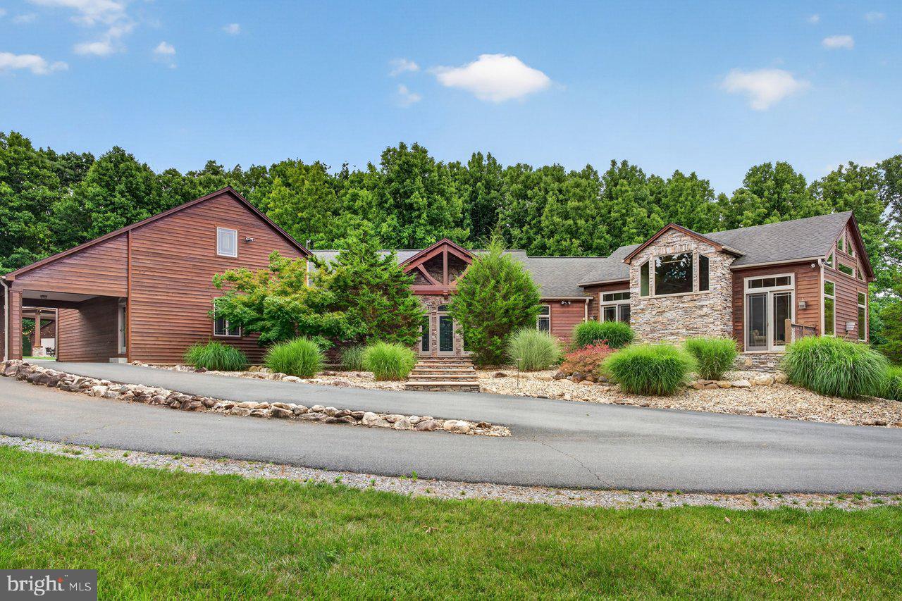 COMING SOON! Custom-built at the base of Massanutten Mountain, this 5 bedroom, 4.5 bath estate offers 5,400+ finished sq ft on 4.2 private acres, just five minutes from resort amenities with no HOA dues. Built with ICF construction, geothermal heat pumps, India stone details, West Virginia post-and-beam craftsmanship, Andersen windows, and recently updated major systems, the home offers real substance behind the finishes. The open main level features a vaulted great room with stone gas fireplace, a chef's kitchen with large island, top-tier granite, Wolf and Sub-Zero appliances, wet bar and custom mill cabinetry throughout. The main-level primary suite includes a large walk-in closet and spa-like bath with oversized tile shower with body jets and separate sauna. The floor plan also includes an office, bonus room, abundant storage, two-car garage and a finished lower level with rec room, pool/ping pong area, theater space, extra living area, and private bedroom suites. Outside, a large wraparound composite deck and outdoor pavilion with pizza oven and attached workshop create exceptional entertaining space. A rare Shenandoah Valley property with privacy, craftsmanship, efficiency and excellent STR potential - being offered turnkey!