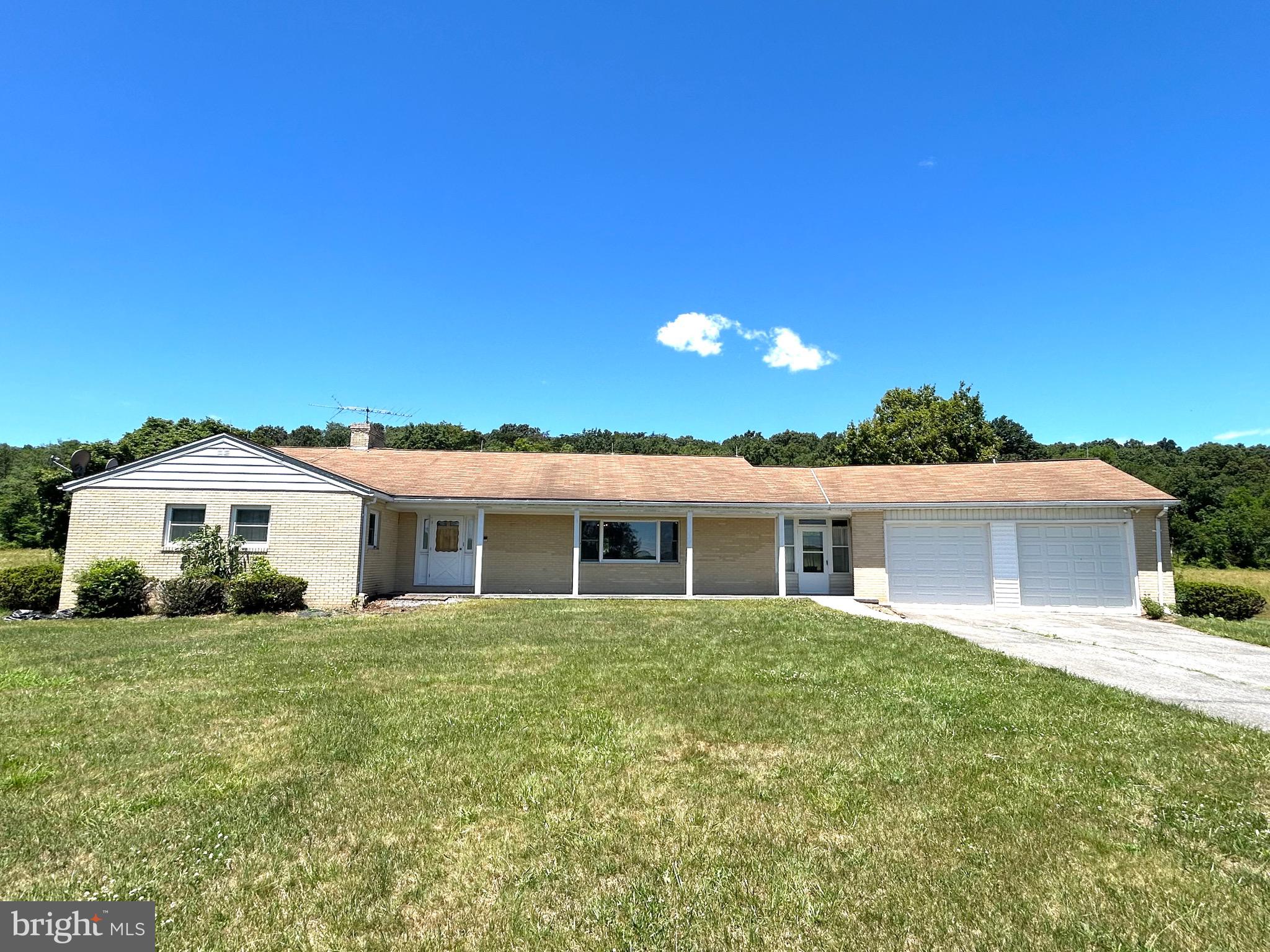 AUCTION PROPERTY – ***Auction date and time changed due to a local weather event.*** Friday, July 17th at 6:00 PM. Opening bid reflects list price only and is not indicative of the final sale price. This timeless 1970s brick rancher effortlessly blends classic craftsmanship with a warm, serene atmosphere that truly makes this property stand out from the rest. 
The private sunroom that over looks the serene 31+ acres has the potential to be a quiet getaway, a plant lovers paradise, or even an artist’s sanctuary. There is ample space for entertaining friends and family between the family room, dining room, sitting room, and sunroom. The basement is ready to be created into the space of your dreams with a beautiful brick fireplace at its center. 
The spacious, 31+ unrestricted acreage presents boundless potential across a variety of ventures. Whether your objectives include agricultural development, wildlife management, hunting, or timber harvesting, this versatile property offers the foundational resources necessary to support your long-term goals..
Conveniently located just 45 minutes from Winchester, Virginia, and within an easy two-hour drive of Washington, D.C., this property offers rural living with city accessibility. This location presents an exceptional opportunity, perfectly suited as both a weekend getaway and a long-term family home.
