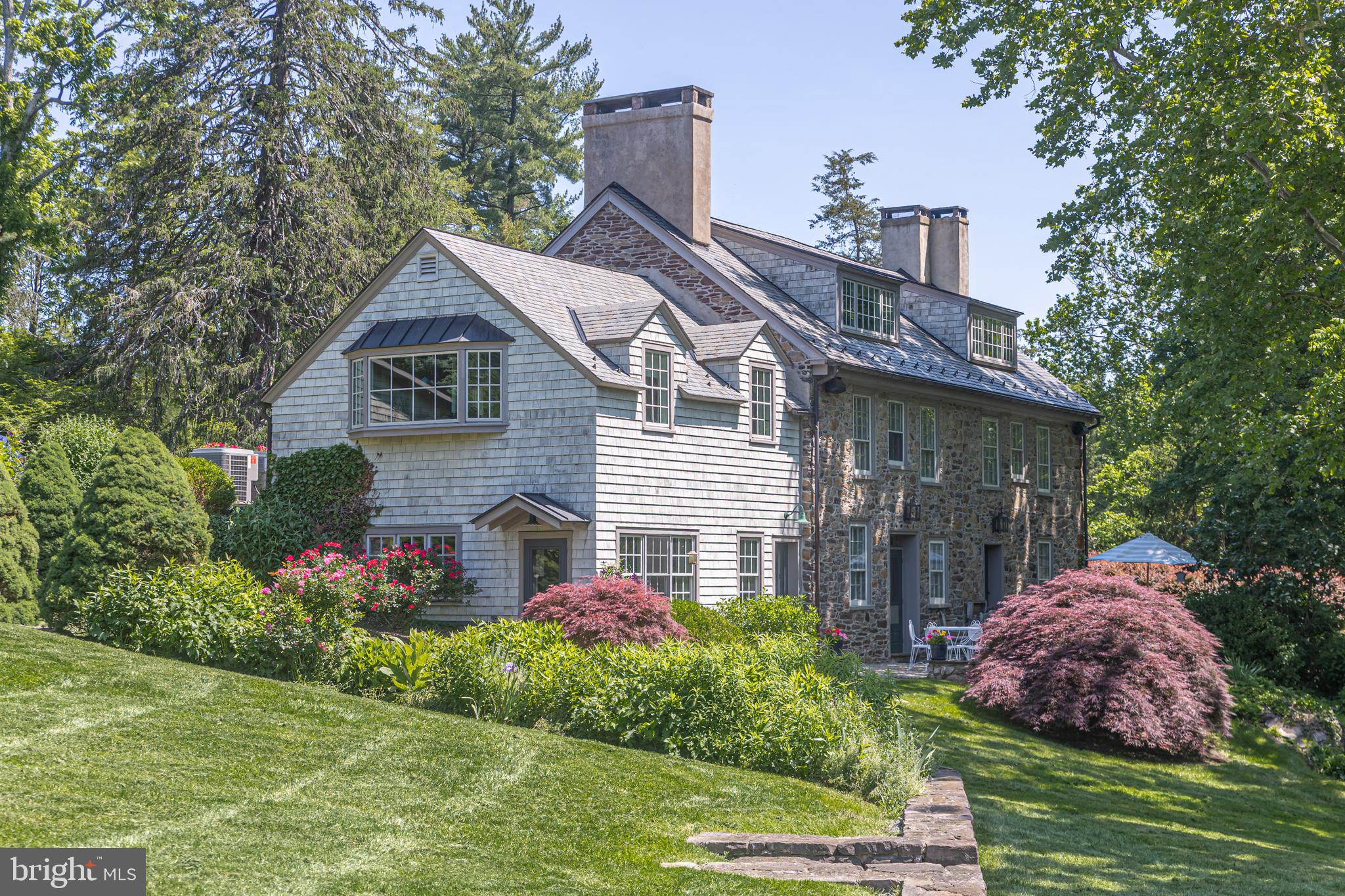 Evergreen Hill, circa 1747, is a masterfully restored historic estate nestled in the heart of Solebury Township—where timeless elegance meets modern sophistication across 24 private, picturesque acres. Behind a gated entrance, the property unfolds with breathtaking vistas of rolling hills, hand-laid stone walls, manicured gardens, a stream-fed pond, and a showstopping pool and spa setting designed for serenity and seclusion.  The main residence offers 3 bedrooms and 2.5 baths, rich in character with wide-plank floors, beamed ceilings, exposed stone, and brick and slate flooring throughout. The sun-drenched living room, located at driveway level, features a wood-burning fireplace, custom built-ins, and charming window seat nooks.   Adjacent is the luxurious primary suite, complete with an expansive bath featuring a marble walk-in shower, radiant heated floors, and bespoke lighting.  Descending to the lower level reveals a stunning formal dining room with a walk-in fireplace, built-in cabinetry, and rustic beams—an ideal space for entertaining. This elegant room flows into a gourmet eat-in kitchen, showcasing exposed stone, Sub-Zero refrigeration, and double Wolf ovens.   Just beyond, a cozy gathering room with a wood stove, built-in study, and nearby powder room creates the perfect everyday retreat.  Complementing the main home are a detached two-car garage and a charming guest house offering two private en-suite bedrooms and a versatile studio space—ideal for guests, creative pursuits, or a home office.  Outdoor living is equally captivating.  A generous stone terrace invites al fresco dining, family gatherings, or quiet evenings under the stars, while graceful stone walkways lead to a spectacular pool and spa bordered by a striking stone wall—offering a tranquil and private escape.  Preserved under the stewardship of the Bedminster Land Conservancy, the property enjoys enduring privacy and seasonal glimpses of native wildlife. Just minutes from the vibrant village of New Hope, Evergreen Hill is a rare and extraordinary offering—where history, beauty, and thoughtful design converge in perfect harmony. One of Solebury’s hidden treasures, this exceptional estate must be experienced to be truly appreciated.