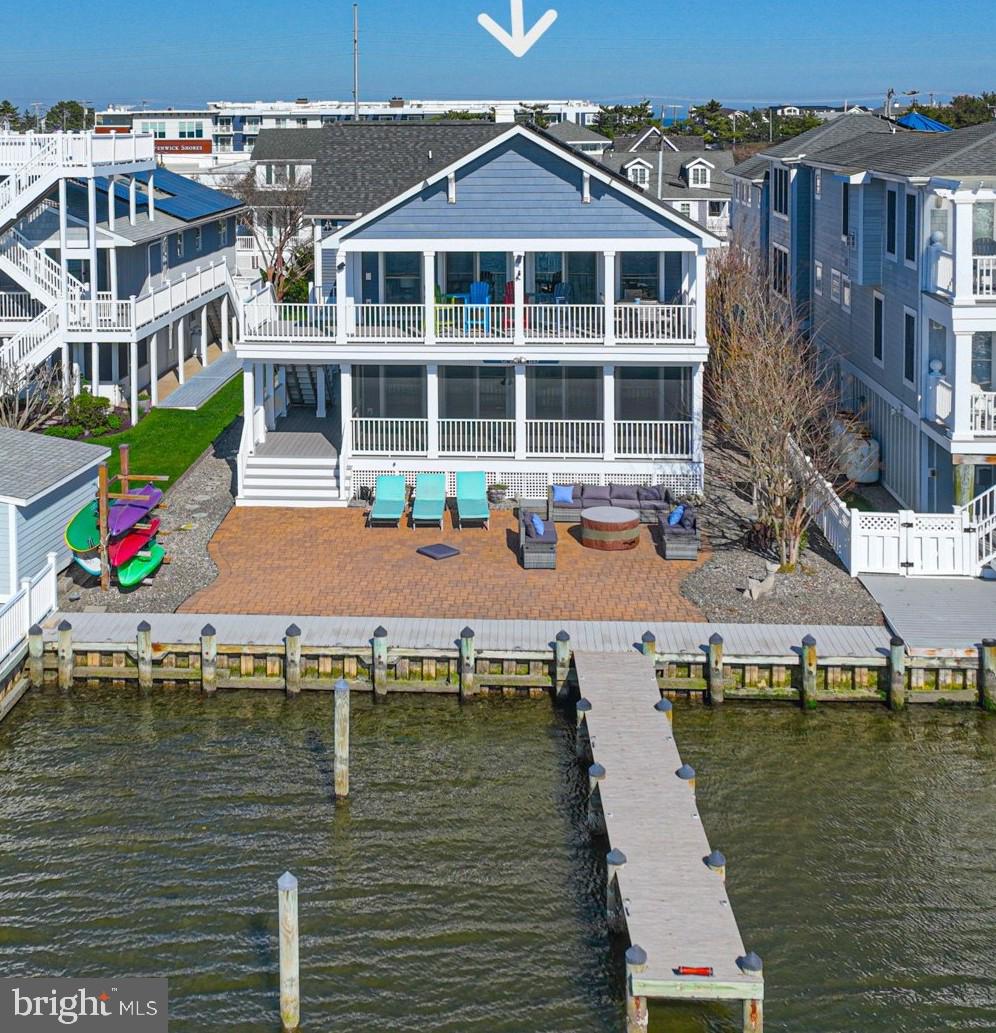 Bayfront and just a short walk to the beach—rarely available and highly sought after! Custom-designed coastal home ideally positioned on the north end of Fenwick Island, offering the best of bayfront living with easy beach access. This beautifully appointed 4-bedroom, 3.5-bath residence features a private dock, 2-car garage, and expansive water views from nearly every angle. The top-floor main living area is designed to maximize light and views, with a spacious great room flowing seamlessly into a gourmet kitchen with high-end finishes, center island, and open dining area. Step outside to covered and open decking—perfect for entertaining or taking in breathtaking sunsets over the bay. This level also includes a primary suite with private bath, plus two guest bedrooms and a hall bath. The first level offers exceptional flexibility, featuring a second primary grand suite with lounge area, walk-in closet, and spa-like bath with tiled walk-in shower and dual vanity. An additional living area, powder room, and laundry room complete this level—ideal for guests or extended stays. Outdoor living is unmatched, with a private dock, covered porch, screened porch, and multiple decks designed to capture the waterfront setting. Low-maintenance hardscaping, outdoor shower, spacious garage, and elevator shaft (ready for future installation) add convenience and value. Sold mostly furnished for a turnkey experience. Enjoy walking or biking to Fenwick Island’s shops and restaurants, or take your boat out for sunset cruises, waterfront dining, fishing, or crabbing. Embrace the beach town living. Private showings only by appointment. Ready for your summer enjoyment.  Have both the bay and beach!