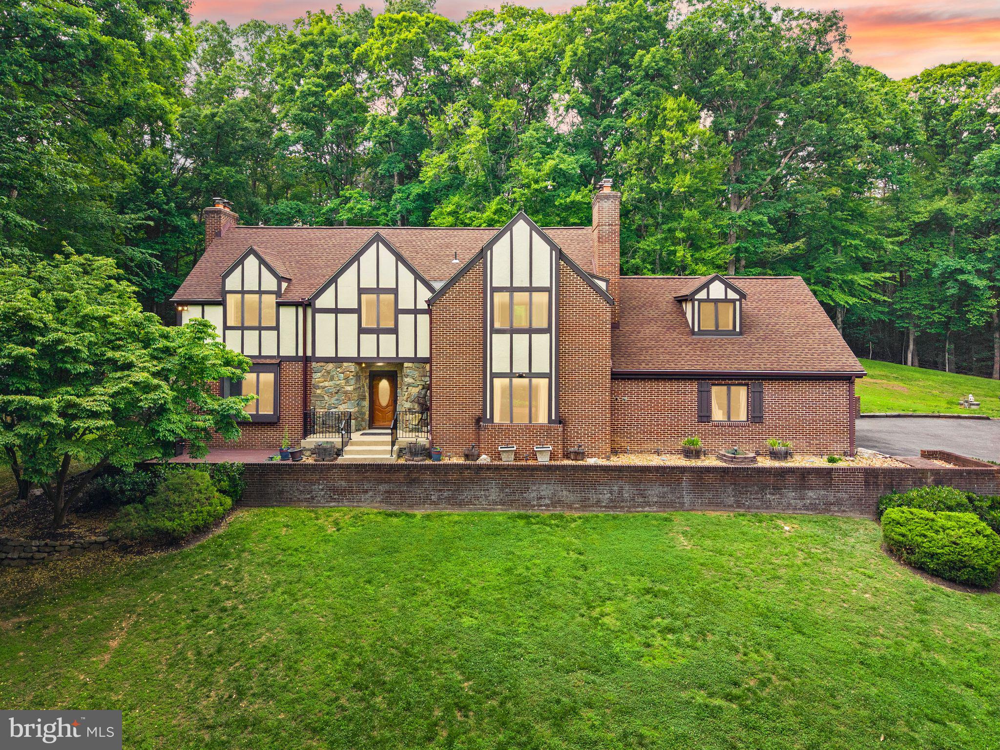 COME TO OUR OPEN HOUSE  ON SATURDAY THE 20TH FROM 12:00 - 3:00 PM **ESTATE SALE**  Rare opportunity to own one of the most unique properties you will ever find * Nestled in the middle of an extremely private and beautifully wooded 5-acre lot ** Only blocks down the street to the Occoquan River Reservoir ** Private community park with boat ramps, picnic area and a great place to cast your fishing pole or a cool dip in the water ** This impressive all-brick Tudor/Colonial offers over 4,600 finished square feet on three levels, along with extraordinary garage and workshop space ideal for a home-based business or serious hobbyist ** The standout feature is the massive detached all-brick 3-level, 3,000+ sq. ft. garage building featuring 6 garage bays — 4 on the main level and 2 on the lower level — plus a fully finished upper level ** Perfect for car enthusiasts, contractors, landscapers, electricians, plumbers, or anyone needing extensive workspace, storage, and parking for vehicles, equipment, or company trucks. ** The outdoor entertainment area is equally impressive ** Enjoy summer days by the crystal-clear in-ground pool surrounded by a large concrete deck and spacious wood sunbathing area. Relax in the custom-built gazebo overlooking the pool, or unwind in the screened porch off the home ** Perfect for evening dining and entertaining ** A custom storage shed with a newer asphalt shingle roof adds even more functionality ** Inside, the home offers spacious living areas across all three finished levels ** Beautiful hardwood flooring throughout much of the main level ** Formal living room with brick fireplace, pellet stove, and French doors leading to a bright enclosed patio with brick flooring ** Separate dining room and large family room with additional pellet stove ** Spacious kitchen with breakfast area ** Main-level powder room * Upstairs features "BRAND NEW" wall-to-wall carpeting, including a huge primary suite with luxury bath, double vanity, soaking tub, and walk-in shower ** Three additional generously sized bedrooms provide plenty of space, including one bedroom with an oversized finished bonus room or private office with hardwood floors. A large upper-level laundry room includes full-size washer and dryer. ** The finished lower level is built for entertaining, featuring: Large recreation and game room, wood stove, custom brick bar area ** Pool table that conveys * Half bath * Extensive storage space * This is truly a one-of-a-kind property offering privacy, space, versatility, and endless potential ** Make sure to look at ALL the photos and the virtual tour video ** Contact Bob Swartz for estate sale details. 👍🏼