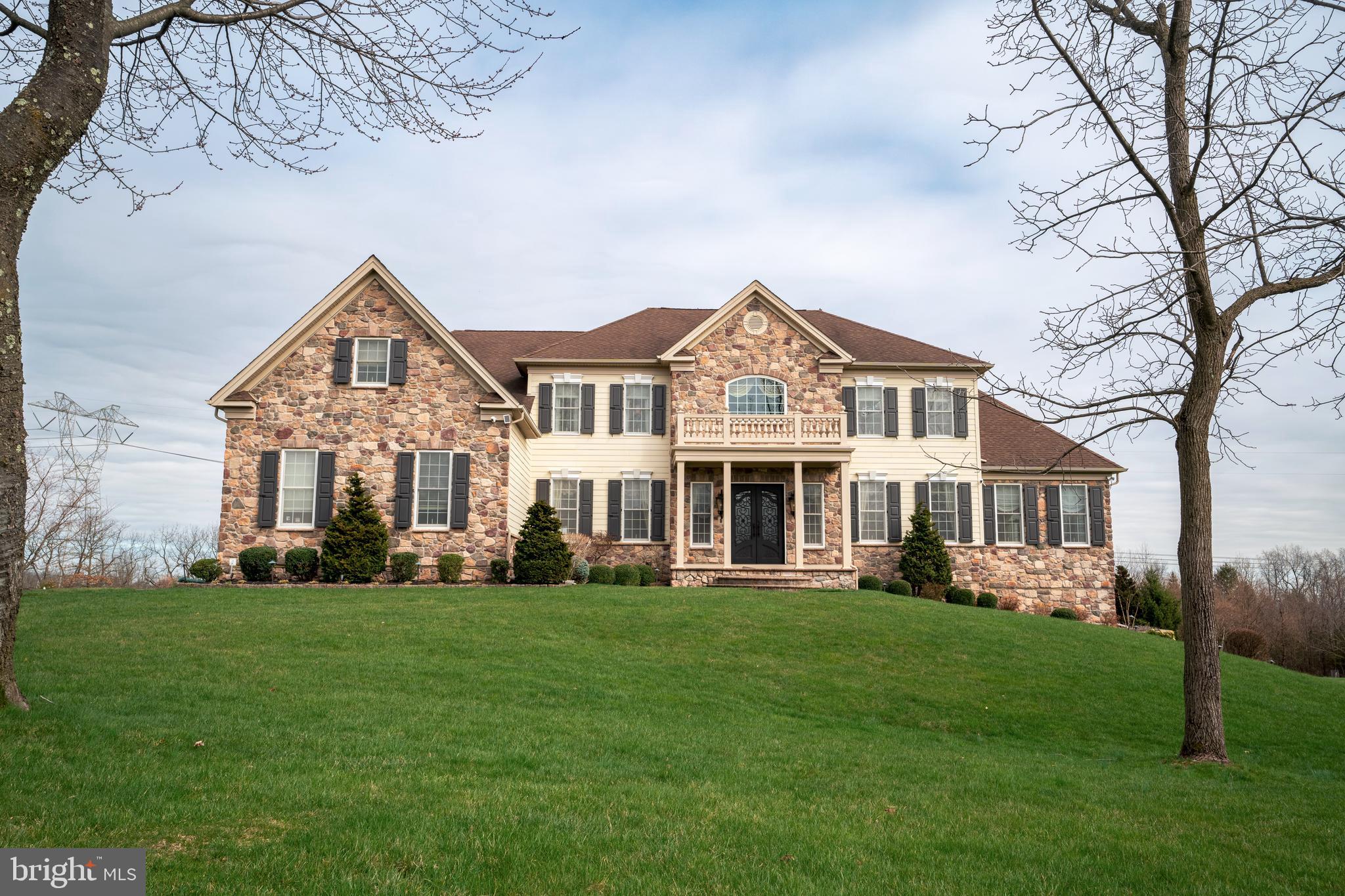 Indulge in the epitome of opulence within this sprawling 6,000 sq. ft. residence in the esteemed Estates at Hilltown. Majestically situated against preserved land, this four-bedroom haven boasts five full bathrooms, two half baths and 3 car garage, greeting you with a captivating butterfly staircase in the foyer. The main level unfolds with a formal living and dining room adorned in hardwood floors and custom crown molding. A vaulted-ceiling conservatory beckons, featuring a wet bar with granite countertops and a seamless transition to a vast composite deck overlooking the expansive backyard. The chef's kitchen is a culinary masterpiece with double wall ovens, a pantry, and granite countertops framing awe-inspiring views. Experience sheer magnificence in the great room- a masterpiece of design. Towering two-story ceilings, rich hardwood floors, coffered ceiling, a gas fireplace with floor to ceiling stone, and a second staircase redefine luxury living.  An office, 2 powder rooms, and mudroom complete this floor. Ascend to the second level, where the primary suite awaits with vaulted ceilings, a sitting room, and a lavish en suite featuring heated floors, Jacuzzi tubs, and an oversized walk-in shower. Two bedrooms boast Juliet balconies with attached bathrooms, and a fourth bedroom offers its own en suite. Technological marvels abound, from the ozinator pool and new Bose system to the updated lifestyle system and outdoor speakers with lifetime warranty. The entire house is fortified with Ring flood and spot cameras, ensuring security. The residence, adorned with Timberlane shutters, presents a full irrigation system and a basement ripe for customization. This home is a sanctuary for those seeking a luxurious retreat with unparalleled amenities.