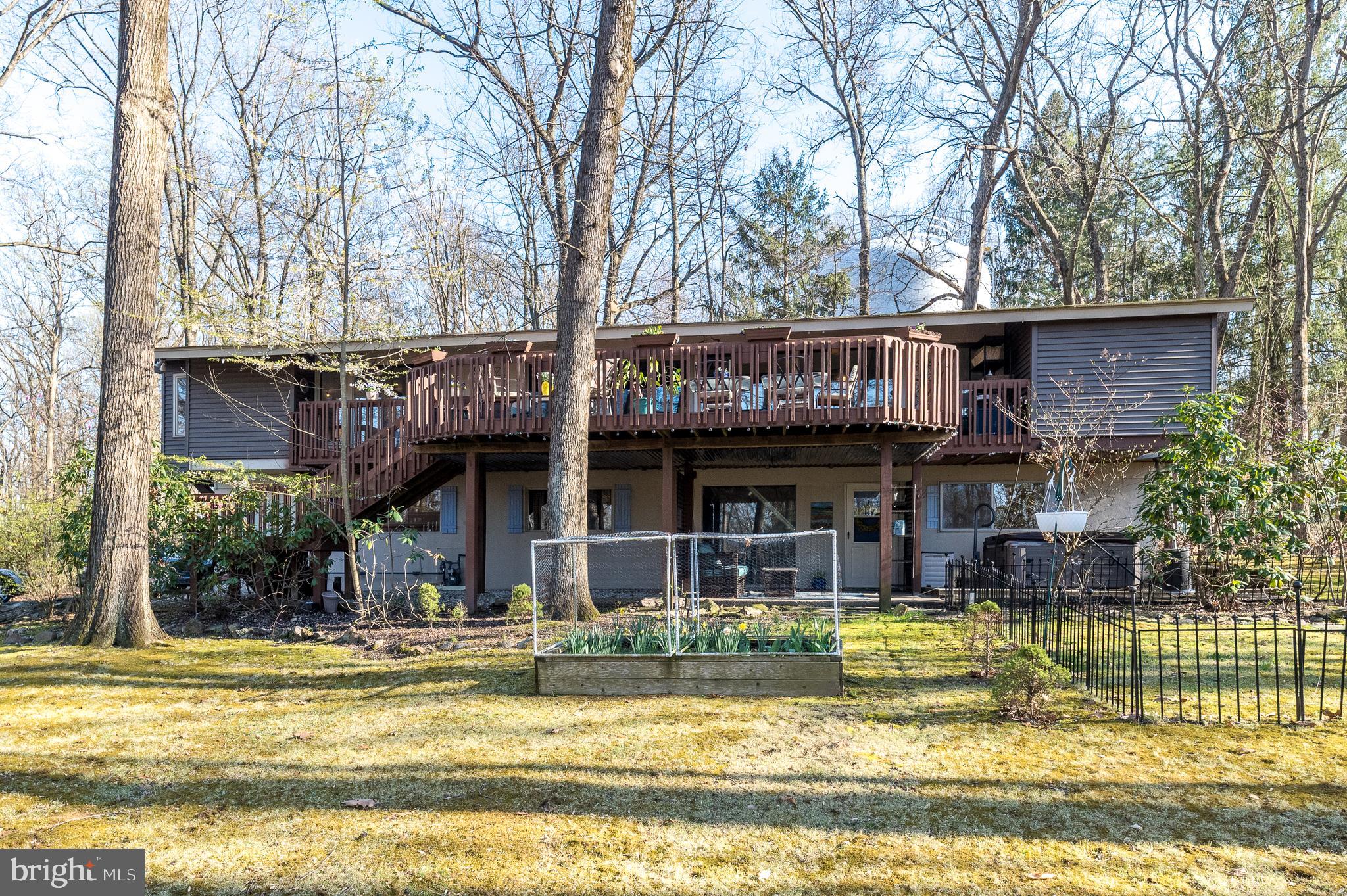 Tucked away on scenic Valley Forge Mountain, 30 Forge Mountain Drive is a mid-century modern retreat that perfectly blends architectural character with a serene, vacation-like setting. Surrounded by natural beauty and steeped in the rich history of the Valley Forge area, this home offers a rare opportunity to enjoy privacy, tranquility, and convenience all in one. Step inside to an open, contemporary layout filled with natural light and designed to bring the outdoors in. The main living area is truly the heart of the home, featuring cathedral ceilings, exposed beams, and a dramatic wall of glass with double sliding doors that lead to a multi-level deck. This space is ideal for entertaining or enjoying the peaceful surroundings. The updated kitchen is both stylish and functional, showcasing white cabinetry, granite counters, tile backsplash, stainless-steel appliances, and a seamless flow into the main living spaces. The breakfast area offers what may be the best view in the home, making every morning feel special. The upper level also includes a versatile bonus room, perfect for a dining room, home office or cozy retreat. Also found on the main level is the primary bedroom suite complete with generous closet space, and a beautifully updated full bath with ceramic tile flooring, white cabinetry, stall shower and a linen closet.  To complete this level, there is an updated half bath. The lower level expands the living space with a welcoming family room, an efficiency kitchenette, three generously sized bedrooms, and an updated full bath.  This space is ideal for guests, extended family, or flexible living arrangements. A large laundry room and a two-car side-entry garage complete the lower level.  A whole house generator is included for your convenience. This home was thoughtfully positioned and designed to minimize visibility of the municipal water tower from interior living spaces.This neighborhood offers the option to join the nearby Valley Forge Mountain Tennis & Swim Club for added lifestyle amenities. Just minutes from Knox Covered Bridge, Valley Forge National Historical Park, and a variety of dining, shopping, and major roadways, this one-of-a-kind property delivers the perfect balance of escape and accessibility. A true architectural gem in one of Chester County’s most picturesque settings…this is a home you won’t want to miss. An important update - the seller is in the process of installing a brand new septic system, offering added value and peace of mind.