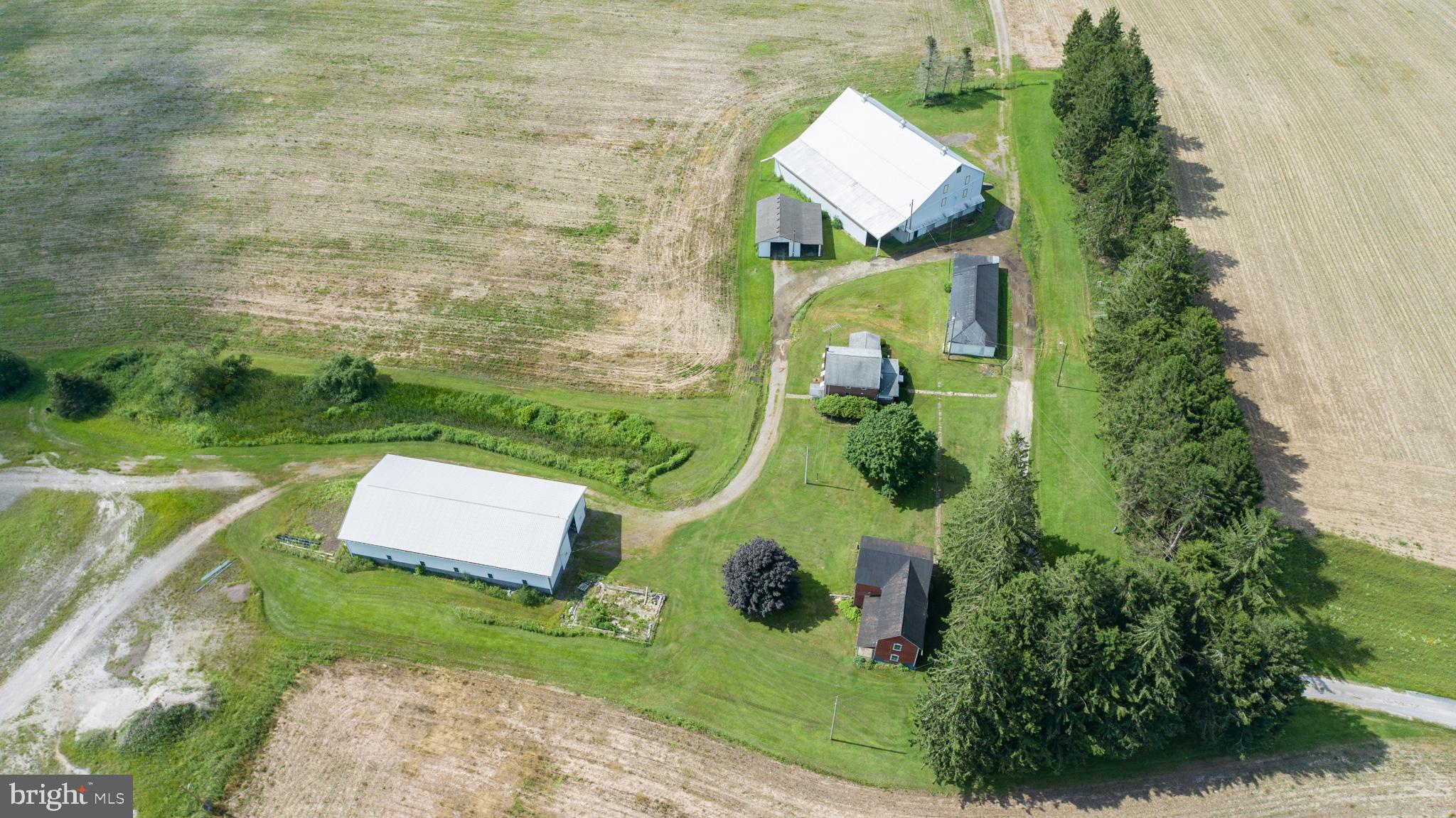Versatile 166-Acre Property with Prime Access to I-68 and U.S. Route 219

Located at the strategic junction of I-68 and U.S. Route 219, this approximately 166-acre property offers a rare combination of size, accessibility, and development potential. Currently operating as a working farm, the land includes roughly 110 acres of tillable fields, 44 wooded acres, and an established pond with a small cabin—ideal for recreational use or future enhancement.

The property sits directly along the eastbound on-ramp to I-68, offering exceptional visibility and access. With public water nearby and the high-traffic corridor to Deep Creek Lake and Wisp Resort just minutes away, this site is ideally positioned for a wide range of commercial uses. Potential options include a truck stop, retail or service center, hospitality venues, or a mixed-use development. Approximately 8 acres are currently leased to a concrete barrier company, providing income and potential for industrial use in a designated section of the property.

The property features seven distinct structures that add versatility and value, including a comfortable main residence, a historic 1800s farmhouse ideal for restoration or hardwood reclamation, and a large traditional barn with a full loft and stalls suited for livestock, storage, or events. Supporting agricultural and mechanical operations are a fully equipped machine shop, a spacious farm equipment garage, and a modern 40' x 100' metal building with a hydraulic crane lift, concrete floor, and high ceilings for industrial use. Rounding out the amenities is a charming cabin by the pond, perfect for recreation, weekend retreats, or rental potential.

Whether maintained as a productive agricultural operation, developed into a commercial hub, or configured for a blend of both, this property offers a strong foundation in a high-growth corridor. Recreational appeal, proximity to key destinations, and diverse infrastructure make this an uncommon investment opportunity.