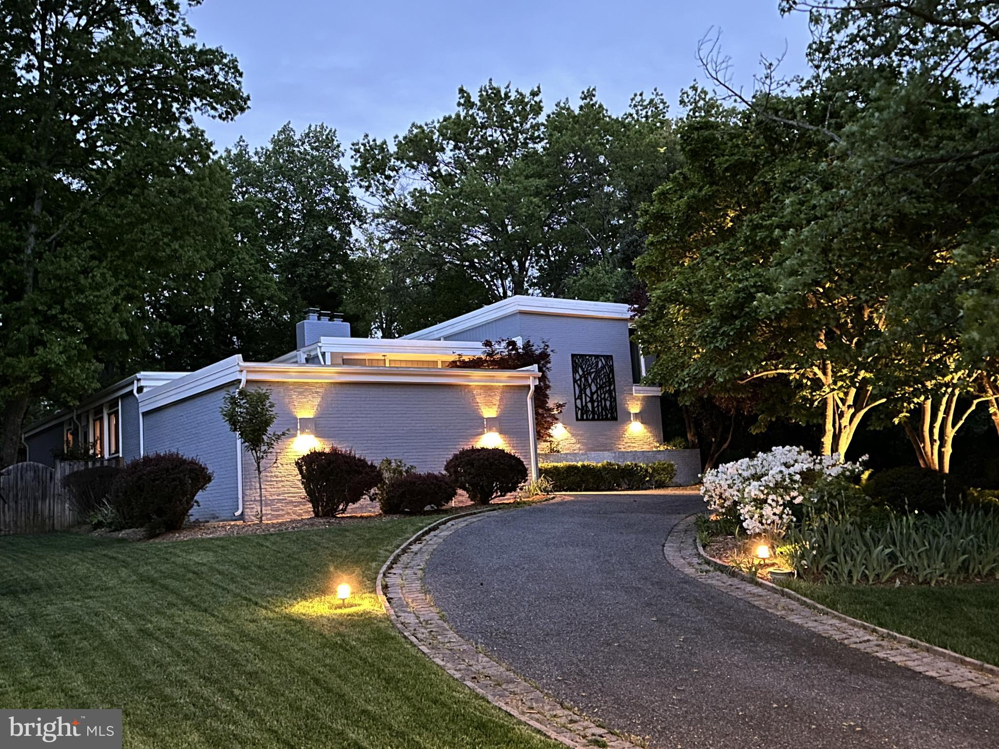 OFFER SUBMISSION DEADLINE MONDAY APRIL 15TH 6PM.  Nestled in the Potomac Village Community, this contemporary residence welcomes you with its elegantly mature landscaping, strategically placed uplighting and an inviting half-circle driveway that creates an impressive prelude to the architectural marvel that lies beyond. As you approach, the home's cool contemporary vibe immediately captivates, promising a blend of modern luxury and serene living spaces. Make your way up the brick paved entrance into the sun filled foyer that welcomes you with a feature pebble wall, high ceilings, oak hardwood floors, recessed lighting, and open to the sunken living room. In the living room you can enjoy the light from the transom windows, cozy up on the built-in couch next to the gas fireplace. A powder room is conveniently located near the main entrance and office. The office features large built-in cabinetry with a surprise walk-in closet featuring shoe storage and wooden shelving, giving this office the alternate use of a fifth bedroom!  The kitchen features new LVP flooring, updated backsplash and quartz countertops, built-in desk area, large center island with gas cooking, wine fridge, dual oven, built in bench seating, brick wall feature, and large walk-in pantry featuring main level laundry. The kitchen flows directly into the dining room with sconce lighting, chair rail, modern farmhouse chandelier, feature brick wall, serene views of the backyard. The main family room creates the perfect space for entertaining as it has direct access to the back yard, a gas fireplace, hardwood floors, sky lights and wooden beams. Enjoy full main level living as the first primary suite is located on the main level with built-in storage, a modern feature wall, and updated ensuite with a new dual vanity with Carrera Marble countertops, floor to ceiling tiled shower with motion sensor backlighting, jetted tub and full access to the walk in closets with custom organizers built-in. Upstairs you will find a second primary suite with a neutral bathroom, and views overlooking the pool. Additionally are bedrooms four and five with casement windows, crown molding and access to the third updated full bathroom. The basement completes the interior living spaces offering the perfect space to lounge, create, or work out! Featuring built in bookshelves and entertainment unit, a newly installed full bathroom, back recreation space with additional book cases and glass french doors to a the perfect room for a gym with a mirrored wall. The home also features a two-car attached garage, and ecobee thermostat. Feel like you are on vacation, as you will never want to leave the backyard! Enjoy dinners on the trek decking with solar lighting and full deck retractable shade. The mature landscaping, stone retaining wall, and privacy fence, make it feel completely serene as you soak in the 6ft deep salt water pool with a custom emblem highlighted in the center of the pool. Don’t miss the second outdoor powder room right off of the pool area, perfect for guest use. Enjoy all this home has to offer plus the prime location, situated less than a mile from the vibrant Potomac Village. Here, an array of shops, dining establishments, and social hubs await your exploration. The property also offers unparalleled convenience for commuters, with easy access to major thoroughfares such as the Beltway, River Road, and Falls Road. Nature enthusiasts will revel in the proximity to expansive national parks including Great Falls Park, the C&O Canal National Historical Park and Trail, and the scenic Potomac River. For golf aficionados, premier courses like TPC at Avenel and Congressional Country Club are just around the corner.