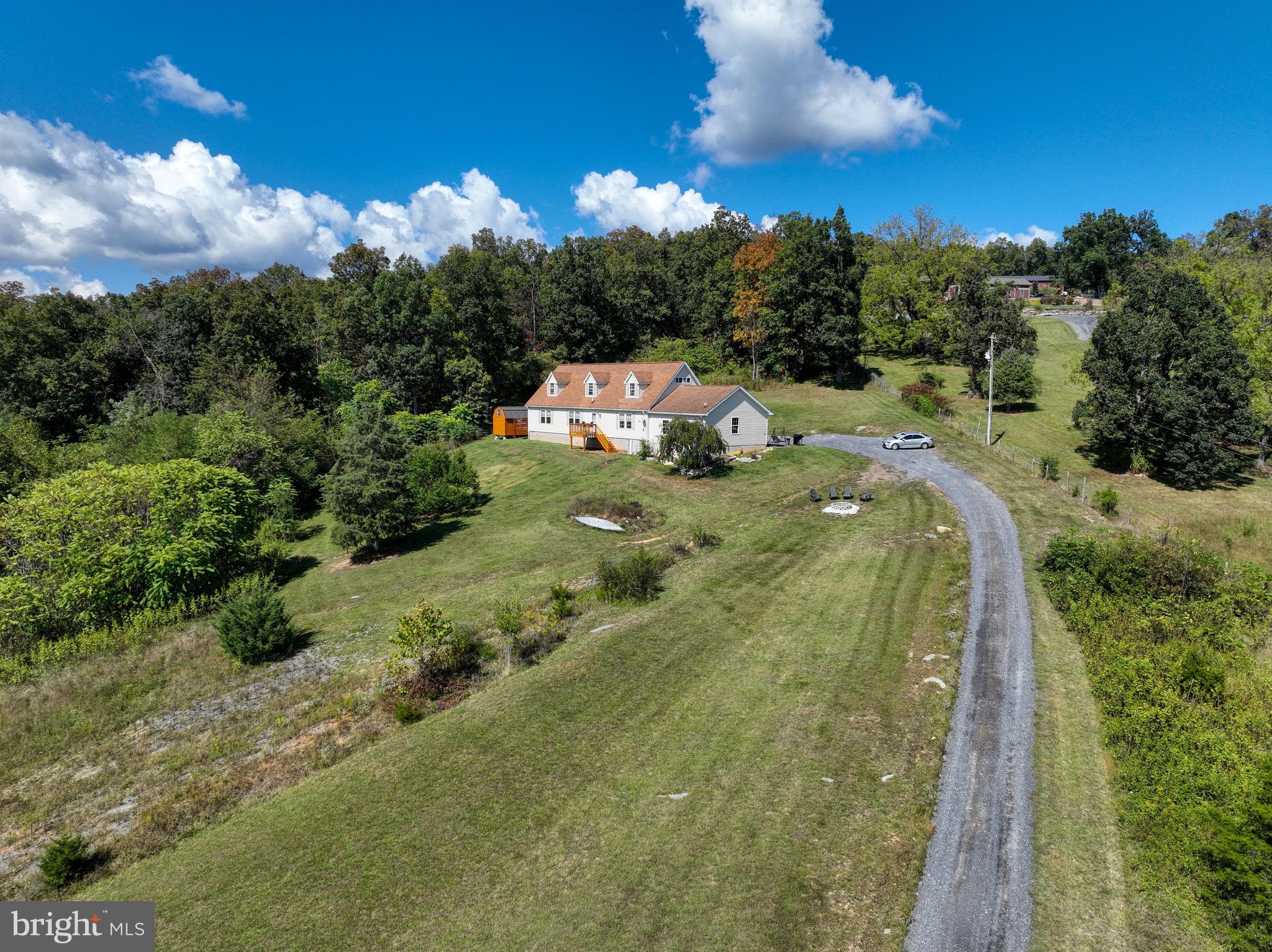 Escape to the peace and beauty of the Shenandoah Valley with this stunning 5-bedroom, 3-bath home nestled on 9.84 picturesque acres in Mount Jackson. Surrounded by nature and showcasing breathtaking mountain views from nearly every angle, this property offers the perfect blend of privacy, comfort, and space.

Step inside to a bright and spacious main level designed for both everyday living and entertaining. The inviting living room is filled with natural light from large windows that perfectly frame the surrounding mountain scenery. The open-concept kitchen features abundant cabinetry, an island with bar seating, and flows seamlessly into the generous dining area, offering plenty of room for gatherings and special occasions. A second living room provides additional space to relax while enjoying the same incredible views.

The main-level primary suite is a true retreat, featuring a spacious bedroom with direct access to a private side deck, along with an attached bath complete with dual vanities, a soaking tub, and a separate shower. Two additional bedrooms and a full bath are also located on the main level. Just off the dining area, step outside to the patio and unwind in the hot tub while taking in the peaceful surroundings. A convenient laundry room with utility sink is right off the access to the attached two-car garage.

Upstairs, you’ll find two additional bedrooms, a full bath, and ample storage space. Outside, the beauty of this property truly shines. Enjoy nearly 10 acres of peaceful countryside, breathtaking mountain vistas, and a thoughtfully designed fire pit area perfectly positioned to soak in the panoramic views. Whether you’re gathering with friends under the stars, enjoying a quiet morning coffee, or simply taking in the beauty of the surrounding landscape, this outdoor space is sure to become a favorite.

Offering privacy, space, and unforgettable scenery, this property is the perfect place to experience the best of Shenandoah Valley living. A rare opportunity to own 9.84 acres of breathtaking views, nature, and endless possibilities.  -3 Bedroom Septic System-