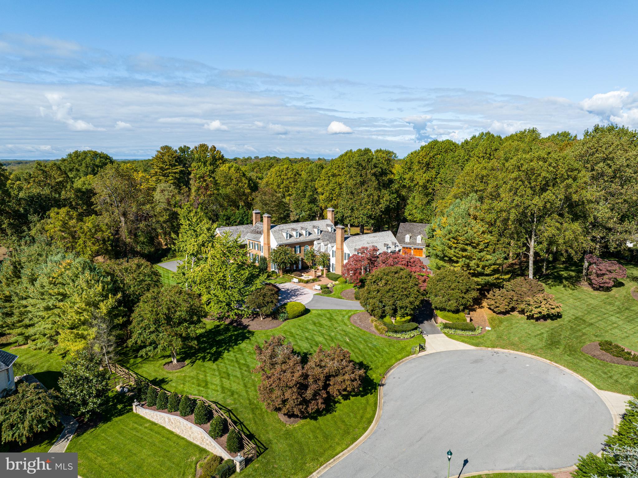 NEW PRICE! Nestled on a private cul-de-sac, an unassuming set of iron gates opens to a striking colonial-style estate located at 11622 Highland Farm Road. Built in 1986 by Patrick Cullinane and sited on two beautifully manicured acres, lush landscaping and mature trees encompass the stately residence to present a peacefully private respite in a coveted Potomac suburb. The home showcases eloquently refined interiors and impeccable attention to detail throughout 6 Bedrooms, 5 Full Bathrooms and 4 Half Bathrooms. Boasting extraordinary scale throughout 3 levels and 14,600 total square feet, hardwood floors, Baldwin hardware, breathtaking millwork, wood-paneled walls, wainscotting and intricate moldings gracefully accentuate the home’s soaring 9’+, cathedral, tray, and coffered ceilings. An abundance of windows line the interior’s walls, flooding the principal living spaces with natural light while numerous fireplaces lend comfort and warmth to each room. Contemporary upgrades are meticulously strewn throughout the residence to provide luxurious day-to-day living while preserving the integrity of the home’s traditional charm. The Gourmet Chef’s Kitchen with two-story ceilings, heated floors, stainless steel appliances, and large island open to the breakfast room, family room, and dining room. Main Level amenities also include a theater room, billiards room, and mudroom with heated floors and pet shower. Upstairs, the luxurious Primary Suite includes separate Baths with heated floors, soaking tub, and walk-in shower; as well as two walk-in closets and wet bar with refrigerator, freezer, and dishwasher. Outside, a serene sanctuary comprised of extensive dining and lounging patios, an expansive 45’ swimming pool, thriving gardens and opulent greenery encompass the colonial to offer effortless enjoyment and an idyllic setting for alfresco entertaining. There is also 6-car garage parking  with car lift and a circular driveway allowing for additional parking. Harmoniously presenting the pinnacle of indoor-outdoor living, this effortlessly elegant abode has been curated with ease and sophistication in mind. Showcasing an exquisite synthesis of traditional architecture, ageless design, modern amenities, and luxurious comfort, this residence is sure to delight its charmed new owner. Meticulously maintained, recent property improvements include a new Main House roof (2021), driveway (2022), updated baths (2015), refinished pool, new pool cover, and new pump filter (2022); and lower-level encapsulation (2020).
