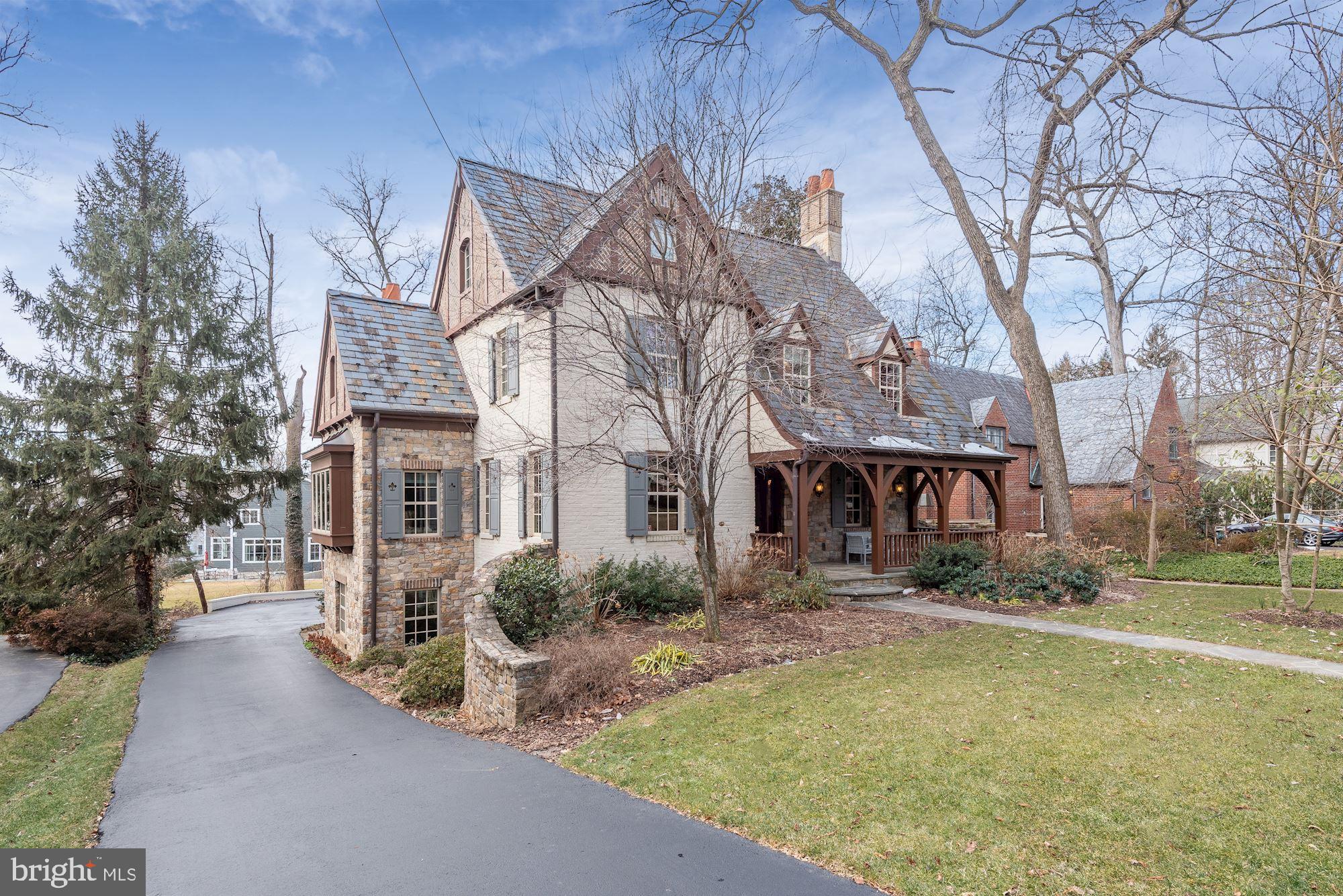 Every so often, a home of truly exceptional quality presents itself. That moment has arrived with 7814 Hampden Lane. Gracing a .28-acre lot in an idyllic Bethesda enclave, this mesmerizing 5-6BR/6.5BA Tudor Revival was inspired by the European architecture that established Greenwich Forest as a local treasure. The product of a comprehensive expansion and renovation completed in 2010, this extraordinary residence boasts a remarkable OUTDOOR LIVING STRUCTURE and a rare MULTI-GENERATIONAL APARTMENT or guest suite. A testament to the skill of architect James N. Gerrety, an artful blend of elements is displayed in the decorative half-timbering, steeply pitched slate roof, terra cotta chimney pots, and charming inset dormers. Carderock stone, intricate brick work, and flared cedar arches add gentle strength. The enchanting facade with covered porch and speakeasy door belies the substantial scale within. Wide-plank hickory floors, extensive millwork, beamed ceilings, and pointed arches distinguish the versatile interior spaces which are at once rich and inviting. Main level highlights include a private office with custom built-ins, a generous, yet elegant dining room with fireplace, a gorgeous custom kitchen open to a warm gathering area, an adjacent theater room with pocket doors, a delightful turret-inspired sunroom, and a glamorous powder room. A stunning rear porch with vaulted ceiling, stone fireplace, and dramatic bubinga wood centerpiece provides impressive overflow living and entertaining space. On the second level is a sumptuous master bedroom retreat with wood-burning fireplace, private balcony, and a luxurious spa bathroom featuring a romantic alcove with freestanding tub. Three additional spacious bedrooms -- all with dazzling en-suite baths -- and a laundry enclosure complete this level. A delightful third level offers wonderful flex space suited to study, leisure, exercise, and sleep. Lower level offerings include an expansive recreation room, a large laundry and work room, a mudroom, a bathroom, and ample storage. A unique and unexpected feature is the expansive and sun-filled apartment with large sparkling kitchen and a quaint private entrance. Mature trees and shrubbery, a stone retaining wall, and a rain garden adorn the lush, low-maintenance grounds which offer both an attached and a detached garage and ample surface parking. Centrally located, this property is steps to the Ride-on stop and less than a mile to downtown Bethesda's many restaurants and amenities, including access to metro and the Capital Crescent Trail.
