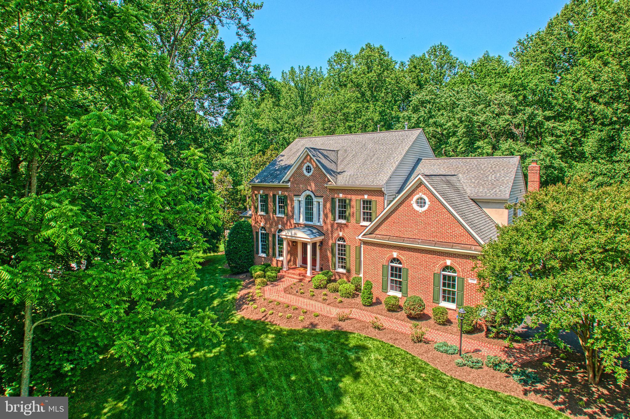 OPEN HOUSE CANCELLED! The pool is open and ready for summer! This grand and elegant residence has been meticulously maintained and thoughtfully updated by its original owners. Set on a premium 0.80-acre lot backing to mature trees, this home offers exceptional indoor and outdoor living.

Step into the impressive two-story foyer with maple hardwood floors, custom iron railings, and an upper-level overlook. The main level features a private office behind French glass doors, formal living and dining rooms with detailed moldings, and a stunning glass conservatory offering serene views of the lush backyard and landscaped pool.

The expansive center island kitchen features abundant cabinetry, glass display cabinets, and opens to a spacious breakfast area.  There is a back staircase. The open area flows into the show-stopping family room with a floor-to-ceiling fieldstone fireplace and a wall of windows and doors leading to the Trex deck. A screened-in gazebo offers the perfect spot for enjoying peaceful backyard views.

The outdoor space is truly a private oasis, with a custom-shaped pool and spa, resurfaced patio, black decorative fencing, and beautifully landscaped surroundings. There’s still ample flat lawn space for play or entertaining.

Upstairs, every bedroom is generously sized and includes an attached bath. Bedroom 2 is ensuite, while Bedrooms 3 and 4 share a buddy bath. The luxurious primary suite feels like a boutique retreat with a separate sitting area, two walk-in closets (one large enough to be a dressing room), and a private laundry area. The spa-like primary bath features travertine tile, two handcrafted vanities, a freestanding soaking tub, and a stone-and-glass shower with a private water closet.

The finished walk-out lower level includes a spacious rec room with custom built-ins, work/play stations, a separate bonus/guest room, and two large storage rooms. Glass doors lead directly to the backyard and pool area.

Located just 2.3 miles from the Metro, this home offers unbeatable convenience to Reston Town Center, Great Falls Village, Lake Fairfax Park, and commuter routes to D.C., Tysons, and Dulles. Tucked away in the quiet Woodlands Estate community on the Vienna/Reston border, enjoy nearby walking paths that connect to the Reston trail network, Lake Anne, and the Water Mine.