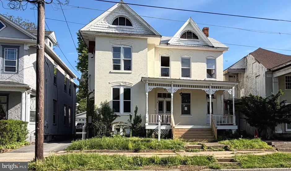 Step into timeless charm in the heart of downtown Charles Town! This classic Victorian offers the character and craftsmanship of a bygone era in an unbeatable walkable location just steps from shops, dining, and local attractions.  From the moment you arrive, the expansive front porch sets the tone—perfect for morning coffee or relaxing evenings. Inside, you'll find original character throughout, with spacious living areas ready for your personal touch. The main level offers exceptional versatility with a spacious bedroom, sitting room, dining room, and an inviting living room with a fireplace.  The kitchen walks out to the back deck and features new flooring and an oversized walk-in pantry, providing abundant storage.  The bathrooms have been remodeled.  Upstairs, you'll find 4 generously sized bedrooms, along with a second kitchen and full bathroom—ideal for extended living arrangements, guests, or potential rental income. The attic level offers a flexible bonus space perfect for a studio, playroom, or additional living area.   The unfinished basement provides even more potential for storage.   Rich in character and filled with opportunity, this historic home is ready for its next owner to bring their vision to life. Whether you're looking to restore its original grandeur or blend historic charm with modern updates, this is a rare opportunity to create something truly special in the heart of Charles Town.