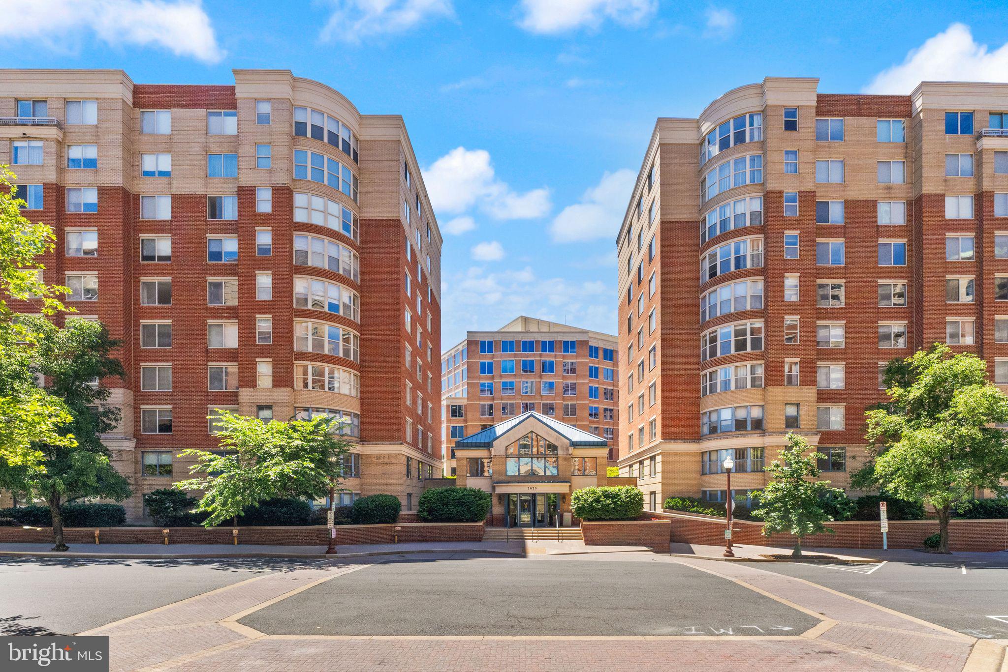 Welcome to this fully renovated (2020) residence in one of North Arlington's most sought-after neighborhoods. Offering 3 bedrooms, 2 bathrooms, and a rare combination of modern design and architectural character, this beautiful condominium is distinguished by its dramatic curved wall of panoramic windows, which fills the home with natural light and showcases vibrant urban views.

Wide-plank engineered wood flooring, custom interior doors, and thoughtfully curated finishes create a sophisticated, cohesive aesthetic throughout. The expansive open-concept living and dining areas flow seamlessly into a stunning chef’s kitchen featuring custom white cabinetry, stainless steel appliances, gas cooking, a marble backsplash, recessed lighting, an oversized window, and an elegant curved breakfast bar that mirrors the home’s distinctive architecture. An apron-front farmhouse sink and premium finishes complete this exceptional space.

Adjacent to the kitchen, the spacious dining area is ideal for entertaining and includes a custom built-in bench with additional storage. The primary suite easily accommodates a king-sized bed and features a spa-inspired bath with a soaking tub, frameless glass walk-in shower, custom tile work, and dedicated storage cabinetry. Two generously sized secondary bedrooms provide flexibility for guests or a home office, while the renovated second full bath showcases designer tile, wainscoting, and a sleek glass-enclosed shower.

The residence includes two reserved garage parking spaces and a private storage unit, providing rare convenience and ample space for seasonal items, luggage, and more. Residents enjoy secure building access, onsite management, an outdoor pool, fitness center, party room, and beautifully maintained green spaces with BBQ grills.

Ideally located in the heart of the Ballston–Clarendon corridor, this home is just blocks from Metro access and moments from acclaimed restaurants, boutique shopping, grocery stores, parks, and vibrant nightlife, offering an exceptional blend of urban convenience and residential comfort.

Schedule your private tour today and discover everything this remarkable residence has to offer.