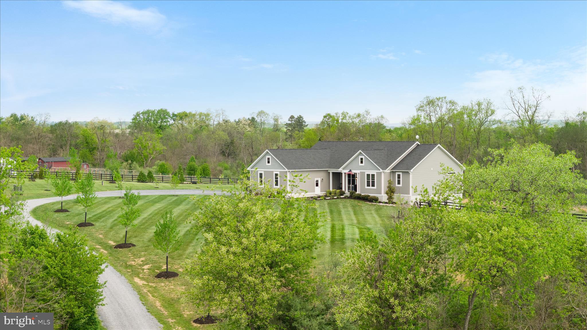 Set on over 10 private acres in the quiet Locust Level Estates community, this beautifully designed 4-bedroom, 4.5-bath ranch-style home offers the rare combination of peaceful country living without feeling isolated from everyday conveniences. Thoughtfully designed for comfortable main-level living, the home blends manageable luxury, functionality, and scenic countryside beauty, creating an ideal setting for those seeking privacy, multigenerational flexibility, aging-in-place convenience, or the opportunity to create their own homestead-style retreat. With over 4,100 square feet of thoughtfully designed space, the open-concept main level creates a seamless flow ideal for both everyday living and entertaining, anchored by a warm and inviting central living area that naturally brings people together.  ***
***The heart of the home is an upgraded kitchen featuring modern GE WiFi-enabled appliances, farmhouse-style sink, and enhanced cabinetry and countertops, all complemented by durable luxury vinyl plank flooring that runs throughout the home, offering both style and practicality. Three main-level bedrooms each feature their own private en-suite bath, while the spacious primary suite includes an oversized spa-style shower designed for relaxation. A fourth bedroom with a full bath is located in the walkout lower level, along with a large recreation space, pool table that conveys, and an expansive storage room. ***
***Thoughtful upgrades throughout include upgraded doors, ceiling fans in every bedroom and living space, dual-zone HVAC, a propane gas line for grilling, and a top-of-the-line Lancaster water filtration system. An oversized three-car garage provides exceptional flexibility for vehicles, equipment, hobbies, or storage.
Outdoor living is where this property truly shines. Enjoy peaceful sunrises from the back deck, evenings around the fire pit, and the natural beauty of two streams that meander through the land. The property is thoughtfully equipped for a variety of lifestyles, whether you envision a private retreat, hobby farm, homestead, equestrian setup, or multigenerational living environment. Four-board fencing, a large, fenced backyard with multiple access points, a run-in shed for equipment, and a chicken coop with laying hens already in place add both charm and functionality. Pastures are nearing completion, offering the potential for horses or cattle, while woods and trails extend through the rear of the property with hunting stands already positioned.***
***The long, private driveway, approximately 1,200 feet and lined with maple trees, sets the tone for the privacy found throughout. The grounds are further enhanced by approximately 20 fruit trees, including peach and apple varieties, along with newly planted white cedars, cherry trees, and maples. Seasonal views offer a beautiful backdrop of neighboring rolling pastures and grazing cattle.***
***Located just minutes from the heart of Winchester, you’ll enjoy convenient access to shopping, dining, and entertainment, including Apple Blossom Mall and the charming Old Town Winchester Walking Mall, known for its vibrant mix of restaurants, boutiques, and year-round events. The area also offers a rich lifestyle with nearby wineries, orchards, farmers markets, and outdoor recreation, all set against the scenic backdrop of the Shenandoah Valley. With quick access to Route 7, I-81, and Route 37, this location offers the perfect blend of peaceful rural living and everyday convenience. Enjoy the serenity of a tucked-away setting while remaining just minutes from shopping, dining, medical facilities, commuter routes, and the conveniences of Winchester.***
***This is a rare opportunity to own a private and versatile countryside estate designed for the way people increasingly want to live today: connected to nature, flexible for changing seasons of life, and peaceful without sacrificing convenience. Reach out for more details and to schedule a tour online.