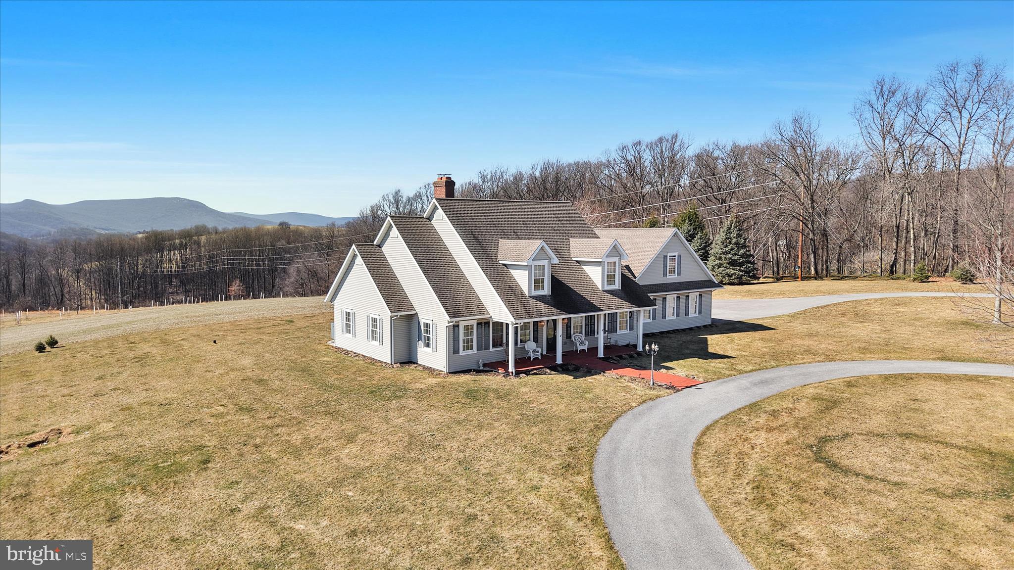 Due to unforeseen family circumstances, the current owners are offering this extraordinary property back to the market — giving you a rare second opportunity to own this breathtaking retreat overlooking Hawk Mountain. Set on over 15 private acres, this home offers spectacular views in every direction. Enjoy stunning evening sunsets through dramatic floor-to-ceiling windows in your living room or sip your morning coffee on the covered front porch as the sun rises over your peaceful countryside escape.  Outdoor living is just as impressive with three beautiful brick patios along — creating multiple spaces to relax, entertain, and take in the surrounding landscape from every angle.
The acreage is currently leased annually to a local farmer producing soybeans, sunflowers, and wheat. You may choose to continue the lease, subdivide and sell a portion, or create your own vision — additional outbuildings, a vineyard, hobby farm, or simply preserve the privacy. The possibilities are endless.
Inside, the heart of the home is the expansive open-concept great room featuring a custom-built, wood-burning brick fireplace with an oversized wood mantel — all perfectly positioned to capture the incredible views. The space flows seamlessly into the dining area and beautifully appointed custom kitchen showcasing refined craftsmanship including crown molding, glass cabinet doors, decorative onlays adding ornate detail, a built-in microwave shelf, cabinet lighting, and a large center island — blending elegance and functionality in the main living space. There is a spacious laundry room with custom cabinetry offering abundant storage, folding space and could easily serve as an oversized walk-in pantry. Privately situated at the rear of the home, the primary suite once again takes advantage of sunset views and features a large walk-in closet, full bath, and custom cabinetry. With three additional bedrooms and 3 additional full baths, there is plenty of room for family and guests. The large, attached garage includes a staircase leading to unfinished space above — ideal for future expansion. The basement features a beautiful wooden staircase leading to a finished office that could also serve as a fifth bedroom, with a full bath nearby. The remaining basement space offers tremendous potential for additional living areas, a recreation room, or even an in-law suite. Conveniently located just 15 miles from Hamburg for shopping at major retailers including Lowe’s, Walmart, Cabela’s, and restaurants. Only 5 minutes to Route 78 for easy access to Allentown and beyond. This is more than a home — it’s a lifestyle property offering privacy, flexibility, and unforgettable views.
