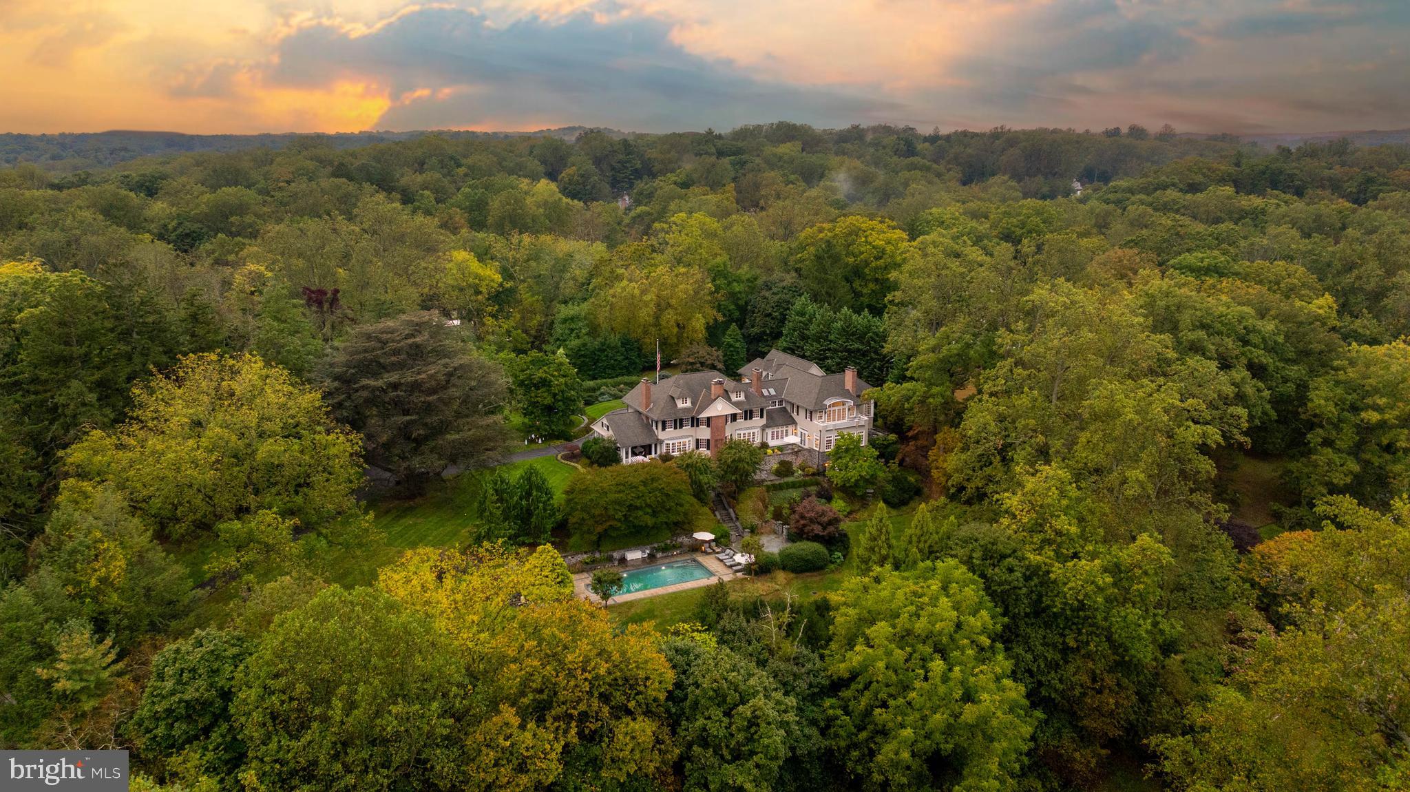 Live authentically. Located in the heart of Ruxton. Circa 1903. Relish the drive home through whispering woodlands. A refuge of tranquility awaits. Immerse yourself in the boundless beauty that unfolds. Extensive expansion by renowned architect Patrick Sutton and Winchester Construction Builders. Abundant windows invite radiant light throughout, while eight fireplaces punctuate the home, each a warm centerpiece of comfort and elegance. Your inner chef will flourish in the cooking space where the soul and senses entwine. The glamorous owner’s suite is a private sanctuary of calm and refinement. Fully finished lower level. Sweeping patios and porches stretch outward, seamlessly blending indoor and outdoor living. An expansive 81 ft. bluestone terrace invites unforgettable alfresco dining beneath the open sky. Surrender to the lush embrace of thriving gardens as you merge effortlessly with the outdoors. Savor every sunrise, then let your body flow through the sparkling embrace of the sublime pool. Recharge in the ambiance and let your energy be restored. Each scene awakens the senses, like a painting brought to life. The landscape becomes a living canvas, ready for the next chapter of your life. Verizon Fios Internet. Cultivate your existence. The art of uniting human and home.