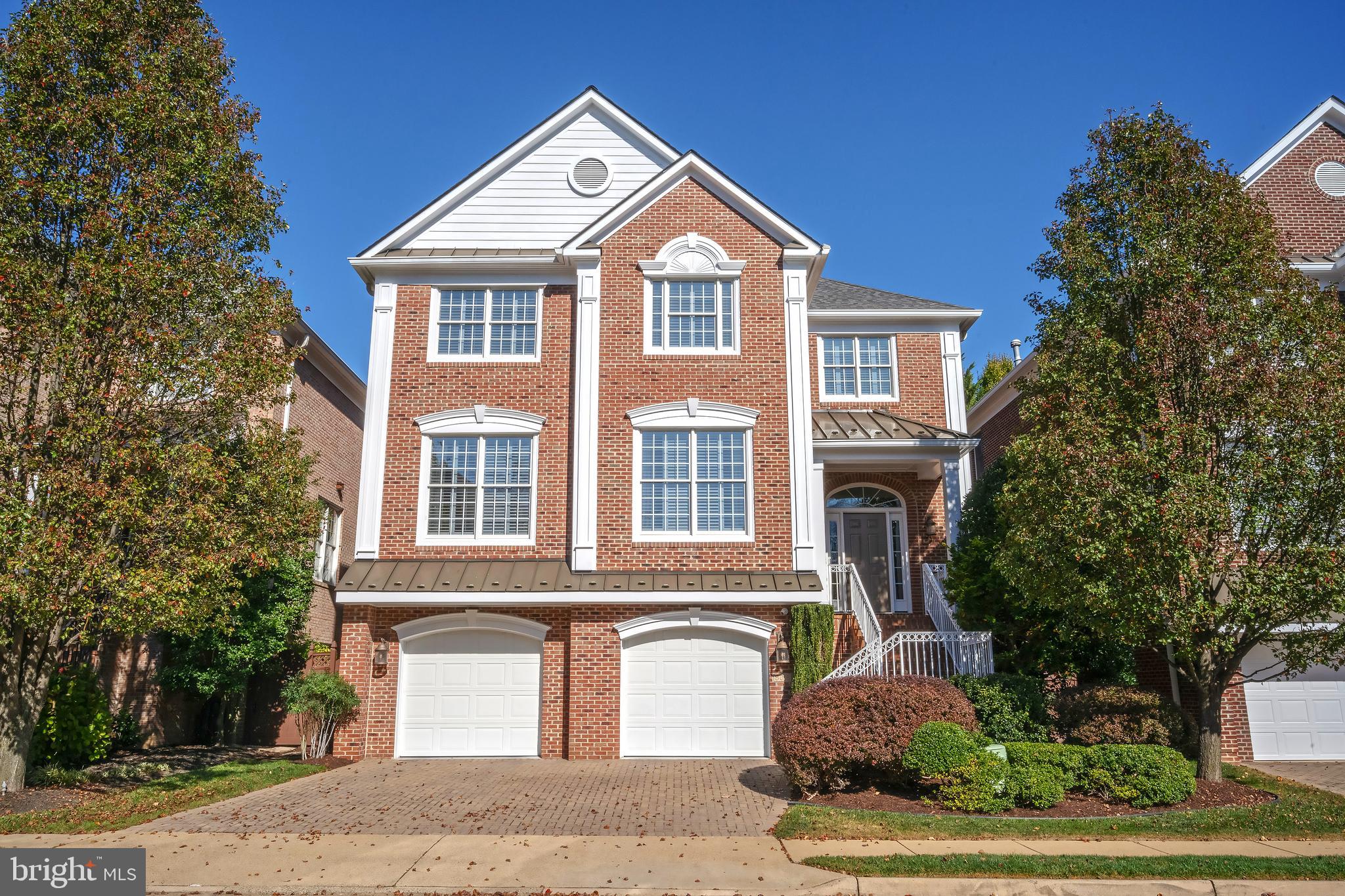Arden Oaks presents a timeless community of stately, all-brick colonials crafted by Dittmar, ideally situated just moments from the vibrant heart of Tysons. Nestled on a peaceful cul-de-sac, this exquisite Belmont model has undergone an extraordinary transformation with over $475K in thoughtful updates.  From the brick driveway and elegant steps, guests are welcomed into an impressive extended-height foyer. The main level showcases refined touches, including heavy crown moldings, sand-in-place oak hardwood floors, and plantation shutters. A front office with striking coffered ceilings, accessed through double glass doors, offers flexibility as a main-level bedroom with its own closet. The formal dining room, framed by square columns and detailed with chair rail, creates an inviting ambiance for intimate gatherings.  Beyond the remodeled powder room, the butler’s pantry and kitchen have been completely reimagined as a culinary masterpiece. Cherry hardwood cabinetry, ice-brown granite countertops, and a stunning stone-and-glass mosaic backsplash set the stage. Professional-grade appliances, including a 48” Monogram refrigerator, Wolf cooktop, and cabinet-paneled range hood, elevate the space, while a center island with a raised breakfast bar and a built-in glass-paneled credenza in the breakfast room enhance functionality and style. Triple sliding glass doors, complemented by transom windows, flood the breakfast and great rooms with natural light and open seamlessly to the newer Trex deck. Anchoring the great room is a gas fireplace with a sleek marble-style quartz surround.  A switchback staircase with elegant iron balusters leads to the upper level, where newer solid oak hardwood floors lend a polished finish. The primary suite is a sanctuary, featuring a tray ceiling, two spacious walk-in closets, one with custom organizers, and a fully remodeled bath. Indulgent details include radiant-heated marble flooring, split oversized white vanities with granite countertops, a private water closet, and a luxurious walk-in shower adorned with floor-to-ceiling marble-style tile and a rain showerhead.  Convenience defines the upper-level laundry room, outfitted with overhead cabinetry, a utility sink, and extra storage. Two additional bedrooms share a remodeled hall bath, which features a double-bowl vanity, marble countertops, a walk-in shower with frameless glass doors, and a separate soaking tub.  The walk-out lower level is a haven for relaxation and entertainment, offering a bright recreation room with double sliding glass doors, a versatile bedroom or gym, a full bath, and a meticulously designed two-car garage. GarageTek floors & slatwall storage system, recessed lighting, and a storage closet make this garage truly exceptional.  Outdoors, the Trex deck and paver patio overlook a professionally landscaped, fully fenced rear yard. Stepping stones lead to side gates, enhancing both function and charm. Ideally located near major commuter routes, the Silver Line Metro at Tysons Corner and Dunn Loring, as well as premier shopping and dining at Merrifield's Mosaic District and Tysons Corner Center. NEWER Kitchen. NEWER Baths. NEWER Roof. NEWER Deck. REPLACED HVAC.
