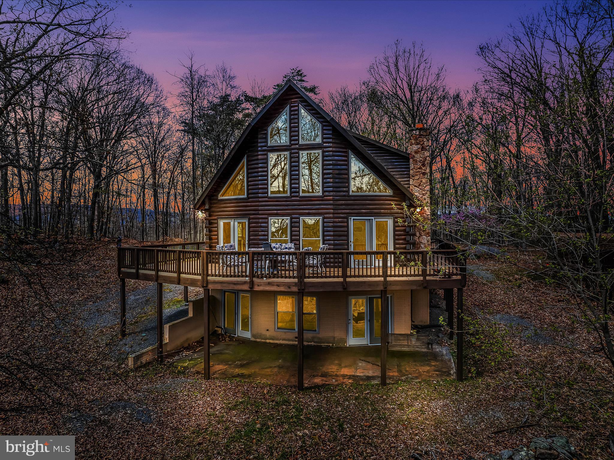 MULTIPLE OFFERS HAVE BEEN RECEIVED.  PLEASE SUBMIT OFFERS BY 6PM SUNDAY NIGHT 4/27 .  SELLERS PLAN TO REVIEW EARLY MONDAY.
Rugged luxury retreat with a side of seclusion and quiet!  Think Yellowstone meets WV!  This solid log one owner home built by Hampshire Builders in 1999 sits on 15.11 acres and adjoins the additional 23.84 acres with well and electric giving you 38.95 acres to hunt or hang out and enjoy the wildlife!  Take in the winter mountain views from every level of the house with soaring windows and a wraparound deck for outdoor fun!  The home features a huge living room with stone fireplace, cathedral ceilings & windows that allow for some amazing natural light, dining area that opens to the kitchen, and 2 bedrooms and bath on the main level.  Upstairs is the primary bedroom w/ gas fireplace, full bath and loft/sitting area that gives way to overlooking the living room and of course the WV mountains and woods.  The basement also boasts lots of windows w/natural light in the open family room with a woodstove and walkout level area.  Lots of room to roam, enjoy campfires and entertaining your friends and family.
Heat is electric heat pump with gas back up and a woodstove.   Gas tank 1100 gallon-buried and owned.  Roof was replaced in 2023 with 20 year shingles, newer appliances, and freshly stained in 2023.
2nd lot with well and electric would be great for a camper or sell to your best friend to keep as a neighbor!
All this right around the bend from an awesome frisbee golf course! Very minimal restrictions and no HOA fees.