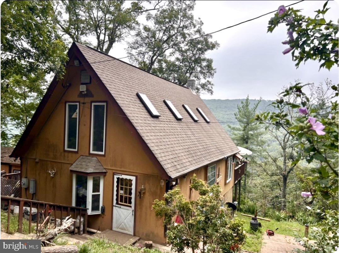 This rustic mountain cabin offers the perfect blend of privacy, scenery, and outdoor recreation. Nestled in the foothills of the Allegheny Mountains, the property features a panoramic view that captures the very best of West Virginia living. A spacious 800 Square-foot wrap around deck with a hot tub hookup invites you to relax and take in the natural surroundings, while the cozy interior features a wood stove to keep you warm during the winter months. The open loft provides additional sleeping space for guests, making this an ideal retreat for families and friends. Located within Ritter’s Hidden Valley Subdivision, owners enjoy access to stocked fishing ponds, a sandy swimming lake, tennis courts, a nearby natural spring, and 20 miles of ATV-friendly roads throughout the community. For hunters, there are two designated community hunting areas—one is 10 acres directly across the road from the property, and the other is approximately 50 acres nearby. For fishermen the stock pond is filled with trout, bass, and catfish. Conveniently located just 30 minutes from Winchester, Virginia, and within an easy two-hour drive of Washington, D.C., this property offers an unbeatable combination of solitude and accessibility. Whether you're looking for a weekend escape or a full-time mountain residence, this is the place to be.