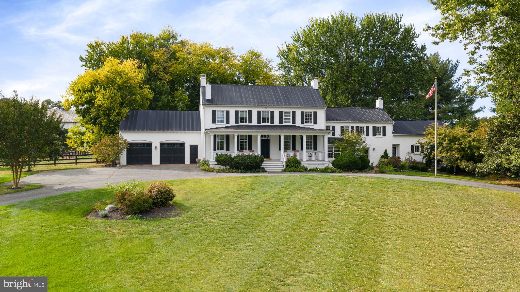 Welcome to “Greenland Farm,” a remarkable 12.56-acre farmette. This extraordinary property preserves its colonial character while seamlessly incorporating modern-day amenities for contemporary living.

As you make your way up the picturesque driveway—passing the original stone springhouse and the newly added circular drive—you’re welcomed by the inviting front porch. The home spans over 4,700 square feet across four beautifully finished levels, offering four spacious bedrooms and four and a half bathrooms.

On the grounds, you’ll find a two-story frame and stone bank barn featuring five stalls and two chicken coops—perfect for equestrian or hobby farm pursuits.

Car enthusiasts will love the 48' x 72' metal shop (built in 2012), complete with three bay doors (10 ft. high x 16 ft. wide), electric service, two hydraulic automobile lifts, and a water hydrant. An additional 18.5' x 60.5' small shop, originally a machine shed, has been converted into five bay garages with concrete slabs, electricity, and a metal roof. In total, the property offers a two-car attached garage and eight additional garage bays across the outbuildings.

Adding to the estate’s charm is a 30' x 30' corn crib with a frame exterior, metal roof, and original stone pier foundation. At the back corner of the property, a large scenic pond provides a tranquil setting for birdwatching and relaxation.

Inside, the home exudes timeless craftsmanship. The foyer opens to wide-plank wood flooring that flows throughout the main and second levels. To the left, a library with built-in bookshelves provides a quiet retreat, while to the right, a family or keeping room with a decorative fireplace offers a welcoming gathering space.

The chef-inspired gourmet kitchen, which has its own entrance, is truly the heart of the home—featuring two farmhouse sinks, a large granite island, a six-burner commercial-grade range, and a fireplace. From the spacious eat-in kitchen, you can access the dining room and living room, both offering breathtaking views of the grounds and outbuildings.

From the dining room, step into a brick-floored garden room—a perfect spot for casual dining or enjoying an evening glass of wine. Beyond the custom French doors, the patio and fenced backyard invite you to relax among butterfly gardens and enjoy the expansive pastoral views.

The main level also includes a guest suite with ADA accessibility, featuring two cedar closets and a luxurious bathroom with custom tile, wainscoting, a handcrafted vanity, and a walk-in glass shower. A laundry room completes the first floor for added convenience.

Upstairs, the owner’s suite offers a serene escape with an oversized dressing room/retreat, complete with built-in dressers, granite countertops, and abundant storage for all four seasons of your wardrobe. The updated en suite bath features custom tilework, wainscoting, and a walk-in shower with glass door. Two additional bedrooms on this level each feature private bathrooms, and a second laundry area is conveniently located near the back staircase leading to the kitchen.

The fourth level offers a den or potential fifth bedroom with a half bath, while the remodeled lower level provides a spacious recreation room ideal for entertaining or relaxing.

With its blend of historic integrity, modern upgrades, and unmatched amenities, Greenland Farm is a truly exceptional property—offering a one-of-a-kind opportunity to own a piece of history while enjoying luxurious country living.