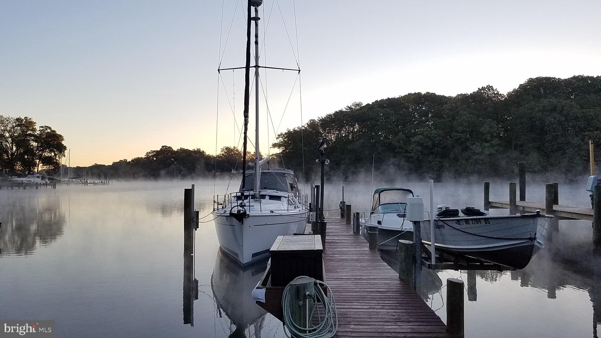 *OFFERS DUE BY WED 4/16 @ 8PM* Breathtaking waterfront residence sited on a triple lot on Rock Creek! Often referred to as Sailing Country, Rock Creek’s deep water attracts sail boaters from around the region who want to call the Chesapeake Bay home (and powerboaters, too!) This expansive, 0.79 acre lot, offers unobstructed views of the Creek and gently slopes towards the water’s edge. The 83’ pier provides space for multiple slips, a jet ski lift and 8-10’ of depth to comfortably moor a 40+ foot boat. The unique private boat ramp even allows you to launch and retrieve your vessel from the comfort of your own home! The property features a garage/workshop and three additional outbuildings to ensure everything has its place. After a long summer’s day on the water, pour a drink, light a fire, and unwind on the covered patio as you watch the evening sunset reflect the most beautiful colors you have ever seen. ** The spacious kitchen was renovated in 2014 and features granite countertops, stainless steel appliances and a dedicated pantry. Enjoy morning coffee at the breakfast bar and larger meals in the dining room, both overlooking the bright living room and expanded waterside windows. Beautiful hardwood floors span the entire main level, adding a luxurious and welcoming character to the home. Two bedrooms, two bathrooms and a spacious laundry room are located just off the kitchen. The primary bedroom has wonderful waterviews, two closets, and a stunning ensuite bathroom with dual vanities and a tiled shower with a bench. ** The possibilities of the lower level are endless! Incorporate it into your main level as extra living space as the sellers have done, or take advantage of the sleeping area, small kitchenette and full bathroom to create an in-law suite or rentable waterfront ADU to offset your mortgage. Regardless of your plans, the lower level rec area is a fantastic place to entertain or relax in front of the TV while boats pass by on the other side of the window! ** But the true star of the show here is the expansive triple lot connected to public water AND public sewer, a sought-after combination that is next to impossible to find on the water!! Thousands of sqft of unused impervious coverage are believed to be available and allowed by County Code. The expansion and re-development potential are vast for the creative buyer – think multi-bay garage, swimming pool, or large addition! (Buyer to do their own due diligence on the feasibility of any redevelopment.) ** Architectural shingle roof replaced in 2014; windows and siding replaced in 2017. Parking for 8+ vehicles. No formal HOA!! The Rock Hill Beach Community Association is a private and voluntary civic organization that maintains the Community Park and Community Beach.  The association also maintains two community piers and a boat ramp. Rock Hill’s location is unmatched at just 5 minutes from Rt 100, 10 minutes from I-695, and a short cruise to the Chesapeake Bay. Schedule your tour today! ** Disregard any maps that do not show the property line extending to the shoreline - they are inaccurate! Ask us for a survey!
