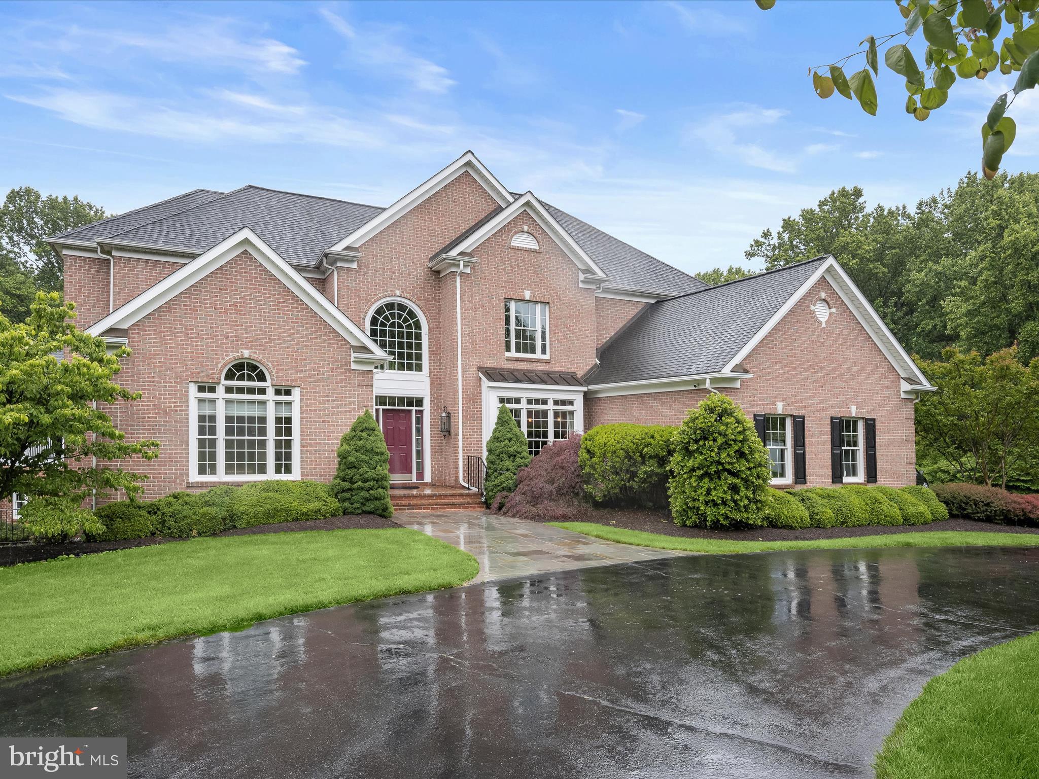 Tucked away on a premium 6 acre lot in complete seclusion and surrounded by lush woods, this stunning all brick colonial estate offers over 8,000 sq. ft. of luxurious living space with an exceptional private retreat with refined indoor living and resort-style outdoor amenities. A long, tree-lined driveway leads to a beautifully maintained home set on subdividable acreage, featuring a heated saltwater PebbleTec pool, expansive patio, multiple decks, and an open yard ideal for entertaining or quiet enjoyment.  Inside, a dramatic two-story foyer welcomes you with a Palladian window, elegant accent moldings, and rich Brazilian cherry hardwood floors that carry throughout the main and upper levels. The great room stuns with soaring ceilings and a rustic stone gas fireplace, flowing seamlessly into the gourmet kitchen. Perfectly designed for entertaining, the kitchen features an oversized island, granite countertops, stainless steel appliances including a Sub-Zero refrigerator, wood cabinetry with display shelving, and a bright breakfast room and sitting area with access to the rear deck.   The main-level primary suite is a private sanctuary with a tray ceiling, its own deck and hot tub, a custom walk-in closet, and a spa-like en suite bath complete with Turkish marble tile, an oversized dual-head shower, jetted tub beneath a skylight, a dual granite vanity with built-in cabinetry, and a wet bar. A powder room, laundry room, and mudroom with built-in hall tree and bench connect to the oversized garage, completing the main level.  Upstairs, the guest suite impresses with a deep tray ceiling and luxurious en suite bath featuring a Kohler bubble soaking tub, shower, and dual vanity. Three additional well-sized bedrooms, including one with a private bath, and a stylish hall bathroom provide flexible and spacious accommodations.  The walkout lower level is designed for entertaining, offering a large recreation and game room with a half bath and French doors to the pool and patio, a hobby, bedroom/ flex room, and abundant storage space.  Every detail of this home has been thoughtfully updated, including a 50-year roof, new insulation, roof sheathing, fascia and trim, tankless water heaters, modern HVAC systems, a recirculation pump, and a variable-speed pool pump. Additional upgrades include remote-controlled Hunter Douglas blinds, a Sonos sound system throughout the interior and exterior, and a Generac whole-house generator. The home offers over 1,000 gallons of stored water and an extensive circular driveway and two pads for guest parking.  Perfectly located with convenient access to major commuter routes, shopping, dining, and outdoor recreation, this home offers a rare blend of luxury, comfort, and privacy in a truly one-of-a-kind setting.