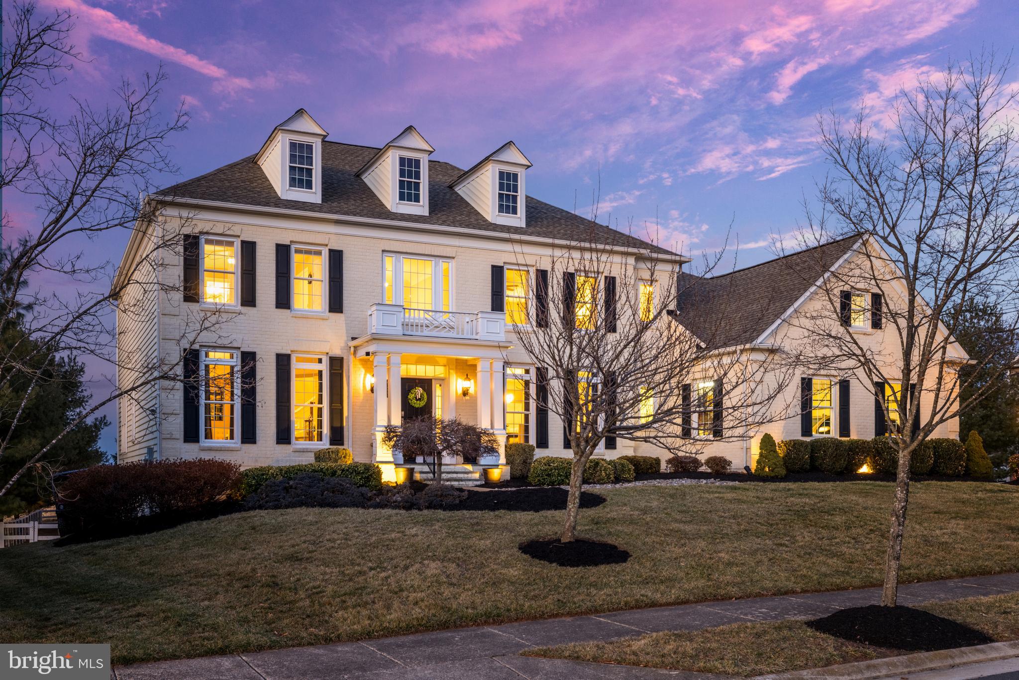 Commanding the end of a tranquil cul-de-sac, this magnificent Colonial estate reveals itself gradually: first the stately brick facade, then the half-acre of manicured grounds, and finally the meticulously crafted interiors that define luxury living in Leesburg's exclusive Red Cedar North Village. The Colonial-inspired residence, highlighted with classic plantation shutters and a covered entryway, makes an immediate impression as one arrives. A 3-car side-load garage and large paved driveway provide ample parking. Inside, the soaring 2-story foyer introduces grand proportions of light and space that continue throughout the home. Elegant wainscoting and generous windows enhance the formal living and dining areas of an airy open floor plan. The heart of the home is the family room and gourmet kitchen, completely remodeled in 2020 with quartz countertops and 10-ft island with Italian marble backsplash, quality GE Monogram appliances, hickory hardwood cabinets, 41" double sink, pot filler, 6-burner gas range, and convection wall oven and microwave. A butler's pantry with wine fridge adds additional functionality. Seamlessly flow from the kitchen to the eat-in dining area and sunroom, ideal for quiet mornings and casual entertaining, where a large Palladian window invites natural light and views of the serene backyard. Transition directly to outdoor living on the upgraded Trex deck, complete with a rain-proof ceiling, ceiling fan, and handrail lighting. The family room features a fireplace for cozy evenings, while the laundry room with upgraded front-loaders and dog washing station adds practical convenience. Upstairs, the primary suite is a sanctuary unto itself, featuring a private sitting area with a fireplace and coffee/wine bar, a private balcony with upgraded Trex deck, and a spa-like primary bath with an enormous his-and-hers walk-in closet and home gym room. Three more spacious bedroom suites on this level each feature a full en suite bath for the ultimate privacy and convenience. The lower level greatly expands the home's relaxing and entertaining capabilities with an expansive, walk-out rec room featuring a fully equipped wet bar, billiards area, and a media room with tiered seating and surround sound. A full bathroom and fifth legal bedroom easily doubles as a home office, while an unfinished bonus room provides space for a workshop, storage, or finishing to your personal specifications. Walk out from the lower level to your expansive lawn and backyard, where a recently added gazebo with vented roof accommodates a fire pit. A large 12x16' shed with 220V power, heat/AC/dehumidifier, and upper storage offers additional utility space. Recent updates include Trex deck and balcony (2018/2022), roof with GAF architectural shingles (2019), full kitchen remodel and primary sitting room updates (2020), tile and hardwood floors (2020/2021), rear yard fence with 8-foot access double gate and landscape lighting (2021), and the gazebo and backyard shed (2024). The community offers a pool, clubhouse and fitness room, with Loudoun Country Day School and Sycolin Creek Elementary nearby. Enjoy hiking, dog walking and nature trails in Banshee Reeks Nature Preserve. Easy access to Route 267 puts Leesburg and Ashburn shops, restaurants and amenities within minutes, as well as Dulles airport and D.C. Offering luxury living with the perfect balance of privacy and convenience, this meticulously maintained estate unlocks a sought-after lifestyle.