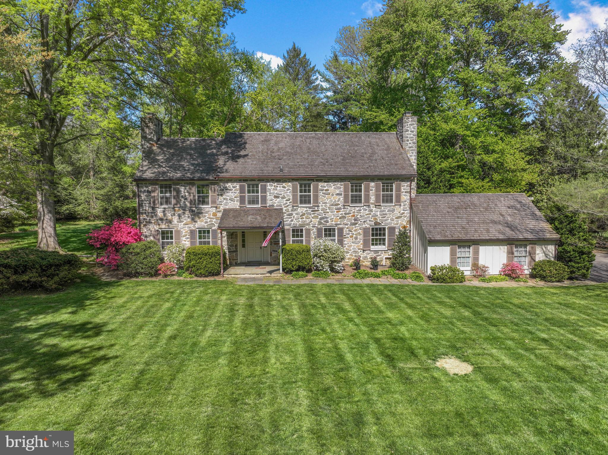 When you dream of a home that’s warm, inviting, spacious, and full of original character, surrounded by scenic beauty where lasting memories are made, it’s 7 Locust Lane that comes to mind. Hidden away at the end of a quiet cul-de-sac in sought-after Rose Valley, this meticulously maintained, almost 3300 sqft classic center hall colonial offers 4 bedrooms, 2 full and 2 half bathrooms, a 2-car garage, a sprawling backyard retreat, modernized HVAC, and placement in the award-winning Wallingford-Swarthmore School District. A long, tree-lined street leads to the home’s picture-perfect curb appeal, showcased by a handsome stone facade, manicured lawn, winding driveway, and a canopy of mature trees that create a peaceful, secluded setting. Inside, an inviting foyer welcomes you with a coat closet and rich woodwork that sets the tone for the interior. Beautiful hardwood floors extend into a large living room with a cozy fireplace and a dramatic multi-pane window framing the wooded backyard, perfect for entertaining and everyday living. Across the hall, the dining room trimmed in chair rail is ready for hosting, while a comfortable den with a second fireplace and built-in bookcases offers another place to relax. The main level is completed by a spacious kitchen with stainless steel appliances and a pantry, a convenient powder room, and a bright sunroom where you can take in the scenic surroundings year-round. Heading upstairs, a striking arched window at the landing captures picturesque backyard views. On one wing of the second level, the huge, sunlit primary suite boasts hardwood floors, double closets, and a private bathroom. Down the hall are three more bright, spacious bedrooms and a full hall bath, along with generous closet space. Adding to the home’s flexibility is a walk-up attic and a full basement with a powder room, providing excellent storage and potential for future finishing. In addition to everything inside, the expansive backyard is surrounded by mature trees for added privacy, featuring a patio for al fresco dining, garden space to perfect your green thumb, and plenty of open grass for outdoor play on long summer days. Recent upgrades to the home include a “55-year” cedar shake roof, a high-efficiency propane boiler with a 1,000-gallon underground tank, multi-zone central A/C, and a whole-house generator for added peace of mind. 7 Locust Lane’s sought-after Rose Valley location is both private and convenient, creating the best of both worlds. A path along the property leads directly to Brookhaven Rd across from Strath Haven High School, and the Rose Valley Swim and Tennis Club is at the opposite end of the block. Nearby, Downtown Media has top restaurants, local shops, and community events, plus walking trails, museums, theaters, markets, and shopping centers are all close. There’s also easy access to Rt-1, I-476, I-95, and Center City Philly via the Wallingford Train Station. Schedule your tour today!