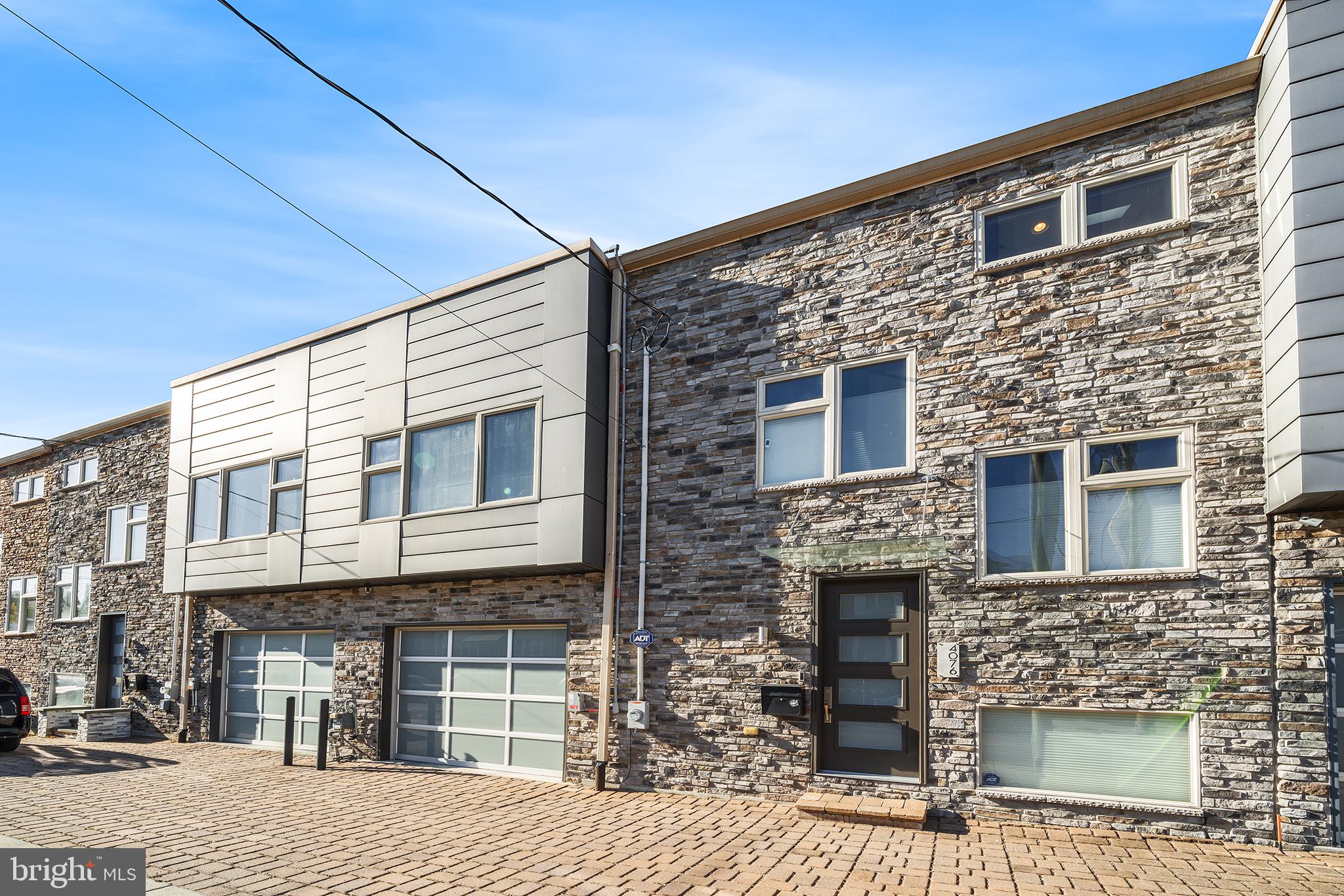 This exceptional 3-bedroom, 3.5-bathroom residence, built in 2016, seamlessly blends contemporary design with sustainable living.

Step inside to discover a spacious, light-filled layout perfect for relaxation and entertaining. Enjoy unique treetop views through the sliding glass doors that extend across all floors—some of the best views in Manayunk! The inviting living area flows into a gourmet kitchen featuring modern appliances, a neutral backsplash, wall oven, and electric cooktop. The large island with a sink serves as a perfect breakfast bar. This level also includes a convenient half bath and coat closet. Tend to your herb garden on the roomy balcony. Enjoy direct access to the attached garage.

Venture downstairs to find another spacious family room with sliders leading to a new deck. This space is ideal for a playroom, exercise space, or entertainment area. This level also includes a bedroom (currently used as an office), a full bathroom, and a storage room.

The second floor boasts two well-appointed bedrooms, including a luxurious primary suite complete with an ensuite bathroom featuring a stacked washer/dryer for added convenience, and a large walk-in custom closet. The roomy hall bathroom offers a dual vanity, perfect for busy mornings.

Up one flight, is the lovely green roof deck with amazing views of Manayunk! Picture yourself dining al fresco on a gorgeous fall day. Enjoy dual-zoned HVAC for year-round comfort. Every window is adorned with custom blinds, providing both privacy and style. Multiple outdoor spaces, including decks off the main and lower levels, offer perfect settings for relaxation and taking in the views. This home is equipped with 5 solar panels, capable of accommodating up to 13, currently covering 25-30% of energy usage—an eco-friendly feature that contributes to lower utility bills.

With a garage and an additional exterior parking space, convenience is at your fingertips. Perfectly located, take a short walk to all the beloved restaurants and cafes on both Main Street. The Wissahickon trails are easily accessible from Henry Ave. Experience vibrant living in Manayunk!