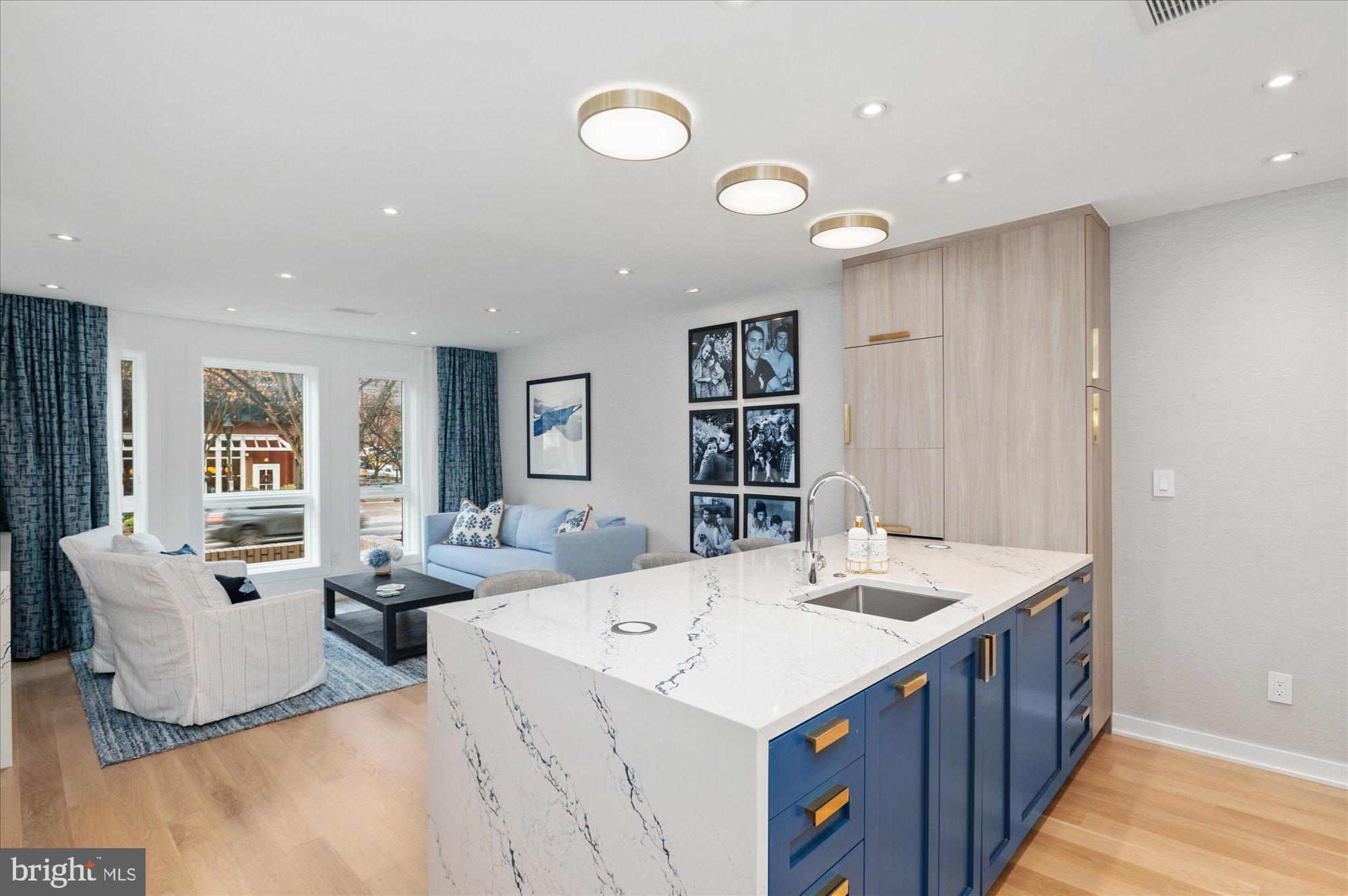 An Exceptional Downtown Bethesda Residence — A Private Urban Sanctuary

Tucked just steps from Bethesda’s finest shopping and dining, this extraordinary townhouse condominium offers a rare opportunity to own a fully renovated, fully furnished residence of uncompromising quality. Conceived and executed as a true pied-à-terre, the home blends sophisticated design with effortless livability—an oasis in the heart of one of Maryland’s most affluent neighborhoods.

The main living space is flooded with natural light through oversized Pella high-performance casement windows, creating an immediate sense of openness and calm. Anchoring the room is a striking 60” linear electric fireplace, framed in Cambria quartz. The tailored Knoll Textiles double-track draperies create an elegant focal point for both intimate evenings and refined entertaining.

The kitchen is nothing short of spectacular. Thoughtfully designed to balance beauty and function, it features exquisite cabinetry, Cambria Inverness Cobalt Luxury Series quartz countertops and full-height backsplash, and a curated suite of Liebherr, KitchenAid, and Bosch appliances. The open layout allows the host to cook with ease while remaining seamlessly connected to guests—perfect for both casual gatherings and elevated dinner parties.

Adjacent to the kitchen, the dining area is a masterclass in intelligent design, featuring built-in banquette seating with hidden storage beneath and a dramatic Jax Sputnik chandelier overhead—an inviting space that feels both intimate and architectural.

Upstairs, the primary bedroom unfolds as a serene retreat, seamlessly integrating a dressing area with beautifully crafted cabinetry and a built-in desk—ideal for quiet mornings or discreet work-from-home moments. The spa-inspired primary bath is sleek and indulgent, offering a floating dual-sink vanity, Origami White wall tiles, heated tile flooring with programmable thermostat, and recessed medicine cabinets with magnifying mirrors—every detail considered, every finish elevated.

The bright lower level provides exceptional flexibility, functioning as a private guest suite or relaxed lounge. It includes extensive storage, a built-in U-Line beverage refrigerator, a discreet Resource Furniture Murphy bed, and a beautifully finished full bath—perfect for hosting overnight guests in complete comfort and privacy.

Outside, a secluded private patio offers a rare opportunity for alfresco moments—morning coffee, evening cocktails, or simply a quiet escape from the city’s energy.

Throughout the home, select white oak 5” engineered wood flooring, forged iron stair railings, a DSC security system with interior cameras, and a state-of-the-art professionally installed home network and WiFi system underscore the level of investment and attention to detail.

This is not merely a residence—it is a statement. A turnkey, design-forward sanctuary in downtown Bethesda, offering privacy, luxury, and walkable convenience in a package that is both rare and irreplaceable. For the buyer who values excellence, discretion, and lifestyle, this home is truly worth every consideration.