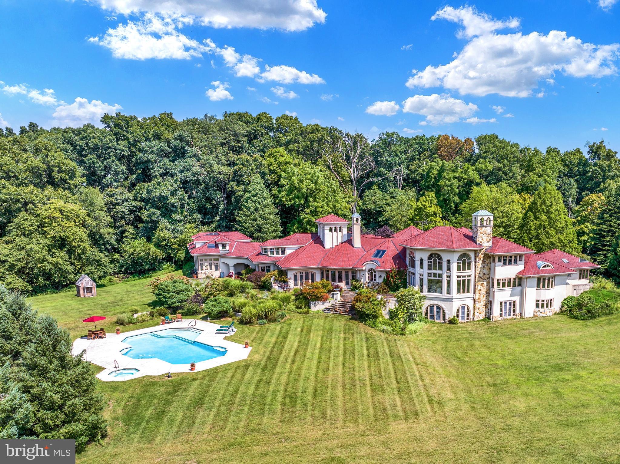 This magnificent estate at 171 Starr Rd. offers approx 10,000 square feet of luxurious living space on approximately 116 private acres.  A long, picturesque driveway leads up to this impressive manor, which sits at the top of the hill, overlooking the valley below. With 5 bedrooms, 6 full bathrooms, and 4 half baths, this home is a true blend of elegance, comfort, and privacy. Two striking ornate double front doors welcome you into a spacious and warm interior, highlighted by rounded archways and Southwestern-style architecture with unique angles and asymmetrical designs. The main entrance features a functional atrium, leading to a stunning spiral staircase that connects all three levels of the home. Beige stucco and rounded walls enhance the natural flow of the space, while large windows flood the home with natural light. The open floor plan creates a warm, inviting ambiance throughout. Practicality meets style in the mudroom, which features a built-in sink, cabinets and coat rack, and extra closet for ample storage. A completely separate, large laundry room is located on the main floor. The front suite offers flexibility for use as a guest room, office, or additional living space, complete with a full bathroom, walk-in closet, and additional 2nd closet. The chef’s kitchen is a dream, featuring double ovens, a custom refrigerator, two cooktop ranges. Granite countertops add elegance, while the butler’s pantry includes space for a refrigerator and freezer. A separate bar area, connected to the kitchen, enhances your entertaining options. The adjoining breakfast room has a cozy fireplace and opens to a spacious screened-in patio, perfect for outdoor dining.  Also a dining room great for entertaining with floor to ceiling windows and beautiful build in cabinets.  The two-story family room boasts floor-to-ceiling windows, and stone fire place, it offers spectacular views of the surrounding gardens and filling the space with light. The first-floor primary suite is a luxurious retreat with a sitting room featuring a stone fireplace. The oversized bedroom includes two massive walk-in closets and opens to a private terrace overlooking the pool. The en-suite bathroom offers a tile shower, sunken jacuzzi tub, stylish gold hardware, skylights, and a spacious dressing area with a marble vanity, sink, mirrors and built-in dressers. The lower level is perfect for recreation and relaxation, featuring a wine cellar, large gym with floor-to-ceiling mirrors and natural light, and a full bath with a sauna. The gym walks out to the manicured lawn. A secondary rec room, complete with a wood-burning fireplace, also opens to the lawn. This level includes a full bar with ornate tile work, a wet bar with overhead glass racks, microwave, refrigerator and separate space for a dishwasher. A charming children's playroom and powder room are nearby, adding to the family-friendly appeal. Mission tile flooring and decorative beams enhance the rustic charm throughout this level. Additional features include service stairs and two electrical rooms for added convenience. The second floor includes three spacious bedrooms, each with its own full bathroom, offering privacy and comfort for family or guests. A dedicated hobby room and an office with an adjacent powder room provide flexible spaces. Second floor balconies overlook the grand family room, kitchen and breakfast room below, further connecting the spaces. The property includes an inviting in-ground pool and spa surrounded, as well as a private tennis court for outdoor recreation. The attached two-car garage provides easy, while a separate three-car garage includes a glasses plant room with pool storage and an unfinished second-floor living space.   Equipped with geothermal and two new hot water heaters, this estate is designed for sustainability.   An additional 16 acre parcel is currently for sale and can be purchased together if desired. Taxes have been reassessed and almost cut in half!!