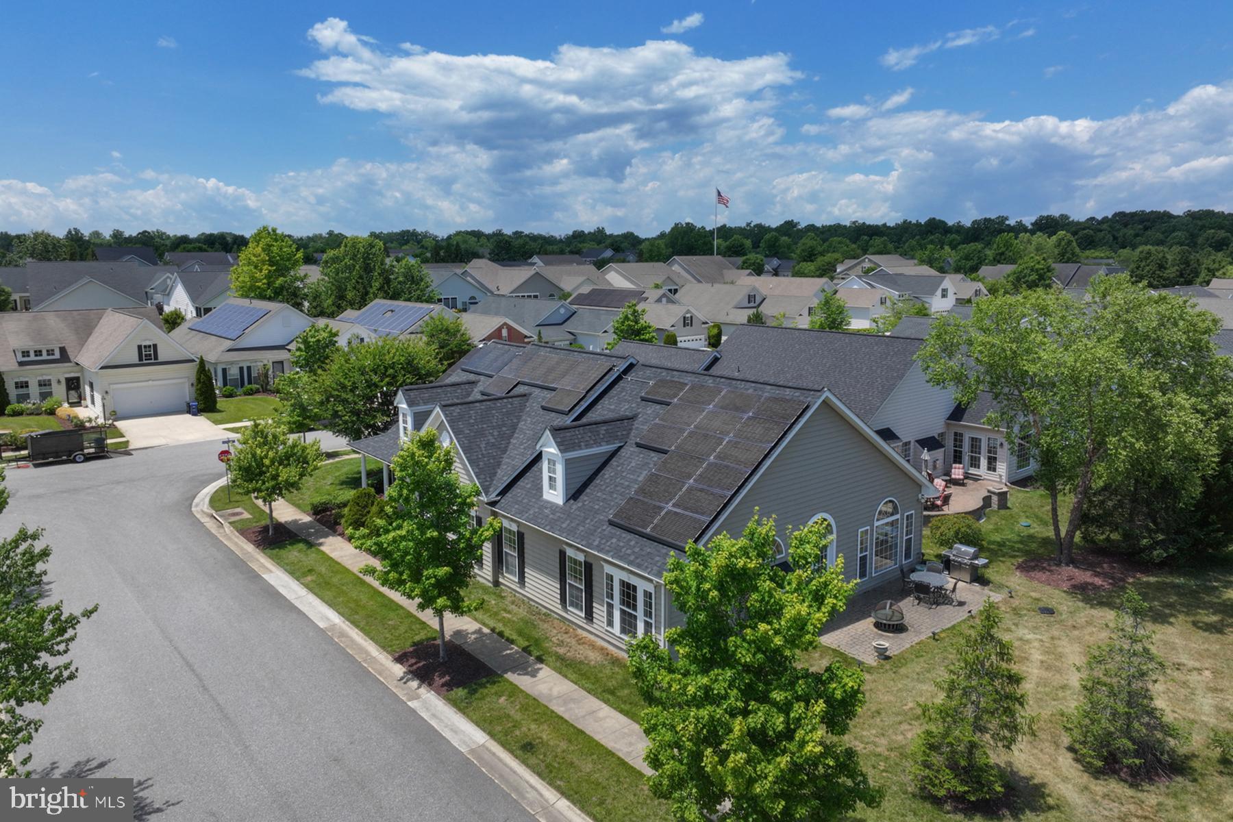 Welcome to 103 Opera Court in the sought-after, active 55+ community of Symphony Village at Centerville. This expanded Vivaldi model features three bedrooms and two full bathrooms on an oversized corner lot across from parklands and with no home behind the paver patio. Pull up to your side loading garage and take the short path to the front door, with a quaint covered porch for slow evenings and watching nature go by. Once inside, the spacious foyer offers a dry bar with mini-fridge and architectural pillars lead to an open concept living space. You’re invited in by unobstructed views from the dining area through the living area into the family room extension with a vaulted ceiling and fireplace with marble surround. There is beautiful, engineered hardwood flooring throughout the public spaces. Unmatched natural light drenches the entire space which centers on the cozy gas fireplace for ease of use on the few chilly winter nights. The gourmet, open style kitchen features gorgeous cabinetry, granite countertops, stainless steel appliances, including double wall ovens that are sure to please any chef. The primary bedroom suite has brand new carpeting, a sitting area with vaulted ceiling, a tray ceiling above the bed for added drama, and double walk-in closets. The primary bath features separate vanities, a jetted soaking tub and a custom, walk-in tub. The second bedroom is down the hall from the entry and is adjacent to the second well-appointed full bath. The third bedroom, at the front of the home, is a perfect flex space and could be a bedroom, office, or studio. It also has wood floors and plenty of natural light. Tucked away at the center of the home is the laundry which is on the way to the two-car garage. The garage features a “sky basement” above, which is partially finished and can be used for storage. Outside the French doors in the family room is a paver patio, perfect for entertaining, dining alfresco or taking your morning coffee. For peace of mind and low utilities, this home also has solar panels and a whole house generator. The community takes care of the grounds, leaving you more time to relax and enjoy the peace and quiet and the many amenities! There are paths for walking or biking, including one leading to the local shopping center, pickleball and tennis courts, putting green, bocce ball courts and a resort style outdoor pool. The clubhouse features a concert hall, billiards room, fitness room, bar, party rooms, dining room, and an indoor heated pool open every day. Activities include classes to learn a variety of skills, social hour, arts and crafts, game and card nights, an artist guild with quarterly art shows and much more for the low HOA fee. The historic and charming town of Centerville is minutes away with wonderful restaurants and shops, and a wharf for boating, paddling or a picnic. Enjoy the slower pace of the eastern shore while remaining close to the ocean beaches and the city life across the Chesapeake Bay. This home has SO MANY UPGRADES and beautiful views – it’s a very special property.