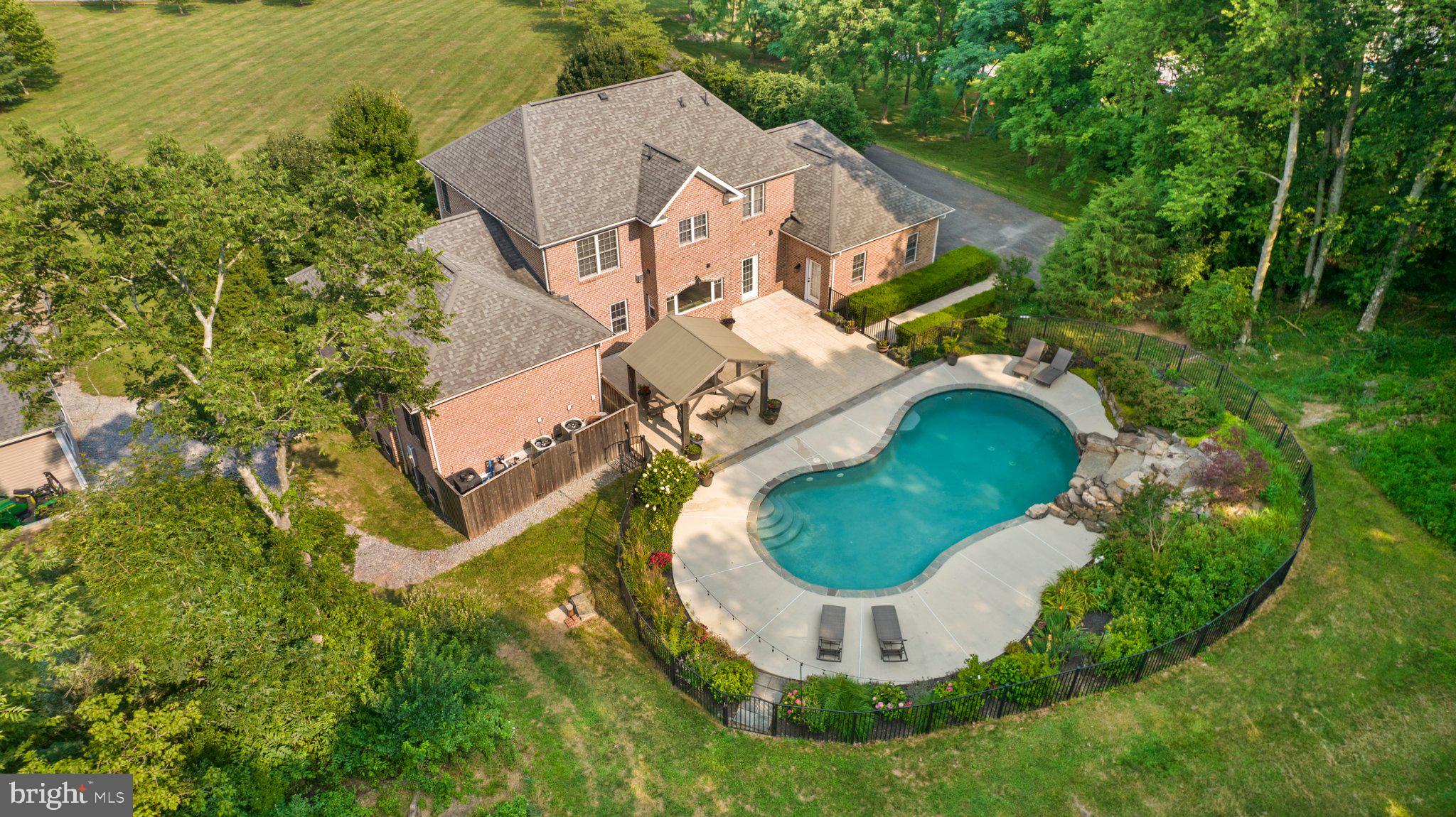 Just off the beaten path, sits this lovely homestead which makes quite the statement on 4.51 private acres in the prestigious West Blakeley community. This stately all-brick Colonial offers more than 4,700 square feet of beautifully finished living space, thoughtfully designed for comfort, entertaining, and multi-generational living.
The welcoming foyer opens to spacious, light-filled living areas anchored by a cozy fireplace. At the heart of the home, the gourmet kitchen flows effortlessly into the dining and gathering spaces, creating an ideal setting for everything from quiet evenings at home to memorable celebrations with family and friends.
Conveniently located on the main level, the expansive primary suite is a true retreat featuring an oversized L-shaped walk-in closet and a luxurious private bath with heated floors and a timeless clawfoot soaking tub. A main-level laundry room adds everyday convenience.
The fully finished lower level significantly expands the home’s living and entertaining space with a large recreation room, additional bedroom, full bathroom, dedicated media room, second laundry area, generous storage, and a secure safe room.

Step outside and discover your own private oasis. The sparkling in-ground pool is surrounded by mature landscaping, open lawn, and an abundance of fruit trees—perfect for relaxing afternoons, outdoor entertaining, or evenings under the stars. The property also includes a charming tractor cottage with a concrete floor and loft, providing exceptional space for equipment, hobbies, gardening supplies, or additional storage.

Additional highlights include a three-car side-entry garage and a new HVAC system installed in 2025. Offering privacy, versatility, and timeless style just minutes from charming small-town amenities, this exceptional West Blakeley property is more than a home—it is a lifestyle. Schedule your private tour and experience everything this remarkable property has to offer.