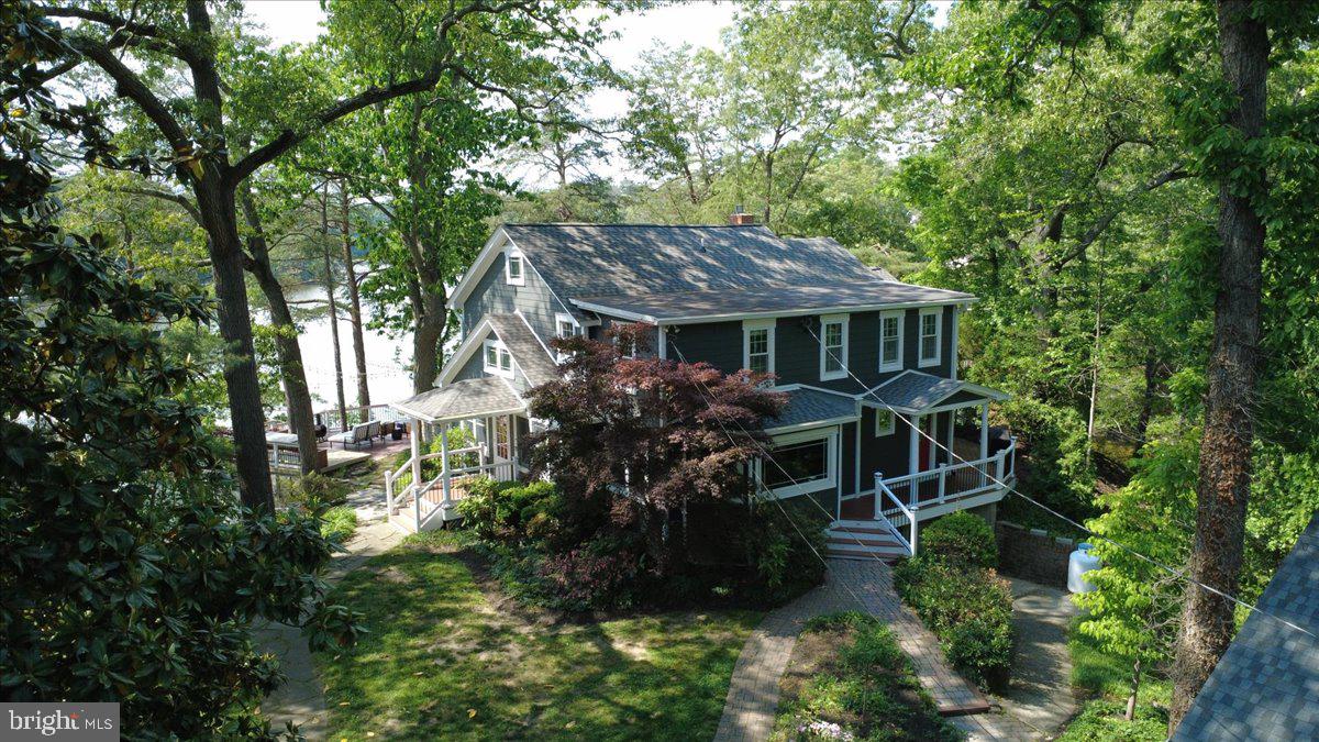 Nestled on a private peninsula, this exceptional multigenerational waterfront estate is situated on a gated 1.4-acre lot and includes an additional separately deeded 0.379-acre parcel. Offering an easy commute to Baltimore and Annapolis, this one-of-a-kind property combines luxury, privacy, and resort-style living with breathtaking Chesapeake Bay waterfront views. The thoughtfully designed main residence offers approximately 2,992 square feet of above-grade living space, plus an additional 432 square feet of finished lower-level space. Featuring three spacious bedrooms and four full bathrooms, the home showcases elegant finishes and a layout designed for both comfortable everyday living and effortless entertaining. A charming detached guest house provides exceptional accommodations with two bedrooms and one full bathroom, making it ideal for extended family, overnight guests, or a private residence for visitors. Designed for those who embrace the waterfront lifestyle, the private deep-water pier features a boathouse, a 20,000-pound boat lift, a 10,000-pound boat lift, and a dedicated jet ski lift, providing direct access to boating, fishing, and endless days on the water. The expansive grounds are complemented by numerous outdoor amenities, including a garden shed with electricity, durable Hardie Plank siding, Trex decking, and a deck equipped with convenient lighting timers. Inside, the spacious primary suite is a true retreat, offering stunning water views, an oversized walk-in closet, and a luxurious en-suite bathroom featuring a jetted soaking tub, separate shower, dual vanities, and a private water closet. Wake each morning to breathtaking waterfront sunrises from the comfort of your own bedroom. The well-appointed kitchen features granite countertops, a new refrigerator, a new microwave, and a dishwasher, creating a functional and inviting space for cooking and gathering. Recent improvements throughout the property include a hardwired entrance gate with electrical outlets, a new ADT security system with touchscreen controls, water leak detection, smoke and carbon monoxide detectors, a new pump for the koi pond, freshly power-washed pier decking, new water lines at the dock, new electrical service to the boat lifts, updated lighting fixtures throughout, new concrete flooring in the basement, a new exterior door, and beautifully renovated Hall Bathroom and Bedroom Two. With its expansive waterfront setting, premium boating amenities, versatile guest accommodations, extensive updates, and the added value of a separately deeded lot, this extraordinary estate presents a rare opportunity to own a private waterfront sanctuary where timeless elegance meets the Chesapeake lifestyle.
