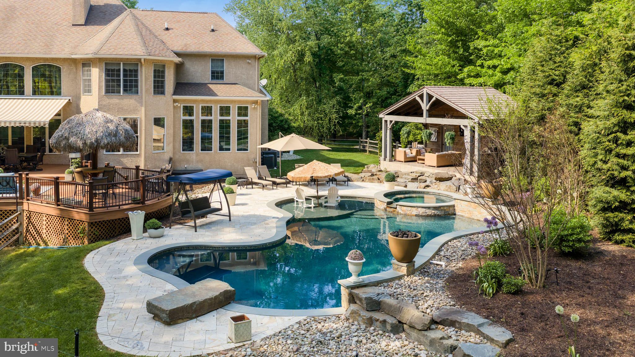 Tucked away at the end of a private flag lot cul-de-sac in Kingswood Ridge — one of the closest luxury neighborhoods to downtown New Hope — this exceptional Solebury residence offers the rare combination of privacy, scale, and walkability to the area’s renowned restaurants, galleries, and shops. Set amidst beautifully landscaped grounds with a resort-style pool and spa, the home is designed for both grand entertaining and comfortable everyday living.

A dramatic two-story foyer opens to soaring living and dining rooms filled with natural light and architectural volume. At the heart of the home is a beautifully updated kitchen featuring stunning Carrera marble mosaic backsplash details, dual built-in full-size Sub-Zero refrigerators, an additional full-size SUBZERO freezer in the pantry, and an adjoining laundry/mudroom. A dual-sided fireplace connects the formal living room with the expansive eat-in kitchen, while a spectacular sunroom overlooks the private backyard oasis complete with an inground pool, spa, Trex-style decking, extensive landscape lighting, and mature plantings that create a true spa-like retreat. A beautifully constructed new pool cabana adds to the resort atmosphere and includes a changing room and full bath for effortless indoor-outdoor entertaining.

The first-floor primary suite occupies its own private wing and features vaulted ceilings, a fireplace, sitting room, multiple walk-in closets, and an oversized bath with dramatic scale and natural light. Upstairs are three additional en suite bedrooms, each offering privacy and generous proportions, along with a massive bonus room above the garage with its own half bath — ideal as a media room, gym, office, playroom, or additional guest space.

The walkout lower level offers exceptional flexibility with a private guest-suite-style apartment complete with its own living area, full kitchen, bedroom space, and sunroom. Altogether, the property offers 4 bedrooms and 6 full plus 2 half bathrooms spread throughout the main residence and pool cabana. Additional highlights include a three-car garage with enough height for vehicle lifts or stacked car storage, beautifully maintained grounds, and one of the most desirable locations in Solebury Township — moments from downtown New Hope while still offering the space, quiet, and privacy expected from a premier estate property.