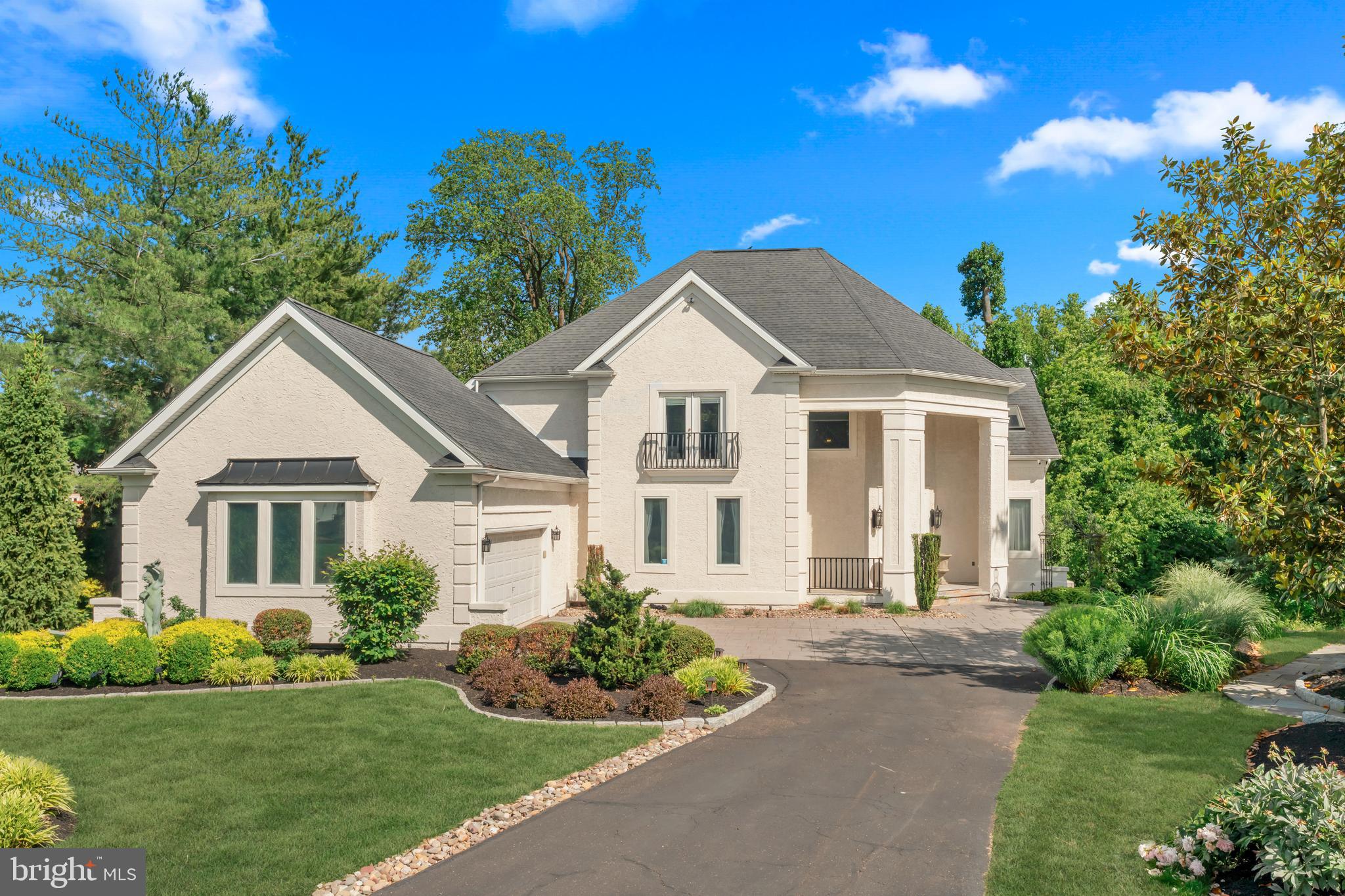 Welcome to this exceptional residence, where timeless elegance and thoughtful design come together to create a truly remarkable home. Boasting five bedrooms, three full bathrooms, and one half bathroom, this beautifully maintained property offers an impressive blend of luxury, comfort, and versatility.

A grand two story foyer welcomes you with marble flooring, a sweeping turned staircase, a striking fireplace, and exquisite crown molding and millwork that continue throughout much of the home. The formal living room is filled with natural light from soaring skylights and features hardwood flooring, recessed lighting, and detailed moldings. Adjacent to the living room is a spacious bedroom, ideal for guests, a home office, or flexible living needs.

The formal dining room showcases hardwood flooring, crown molding, and chair rail accents, creating the perfect setting for entertaining. At the heart of the home is the expansive kitchen featuring granite countertops, stainless steel appliances, a wall oven, a large center island, and a sunny breakfast area with sliding doors leading to a deck complete with a pergola for outdoor enjoyment. The adjoining family room offers warmth and character with a double sided fireplace shared with the foyer.

The first floor primary suite serves as a private retreat, complete with hardwood flooring, a tray ceiling, recessed lighting, and two walk in closets. The luxurious ensuite bath has been beautifully updated and features tile flooring, dual vanities, a large soaking tub, walk in shower, private water closet, and elegant finishes throughout. A convenient laundry room with utility sink, powder room, and access to the attached two car garage complete the main level.

The second floor offers two generously sized bedrooms with hardwood flooring and a beautifully updated Jack and Jill bathroom featuring a floating vanity and tub shower combination.

The finished lower level provides an incredible amount of additional living space and endless possibilities. Perfect as an in law suite, au pair quarters, or extended living area, this level includes a full kitchen with granite countertops, stainless steel appliances, and a center island, along with a dining area, living room, gym space, bedroom, full bathroom, abundant closet storage, and direct access to a private patio.

Filled with character, quality craftsmanship, and extensive custom details throughout, this meticulously cared for home offers a rare opportunity to enjoy spacious and flexible living.