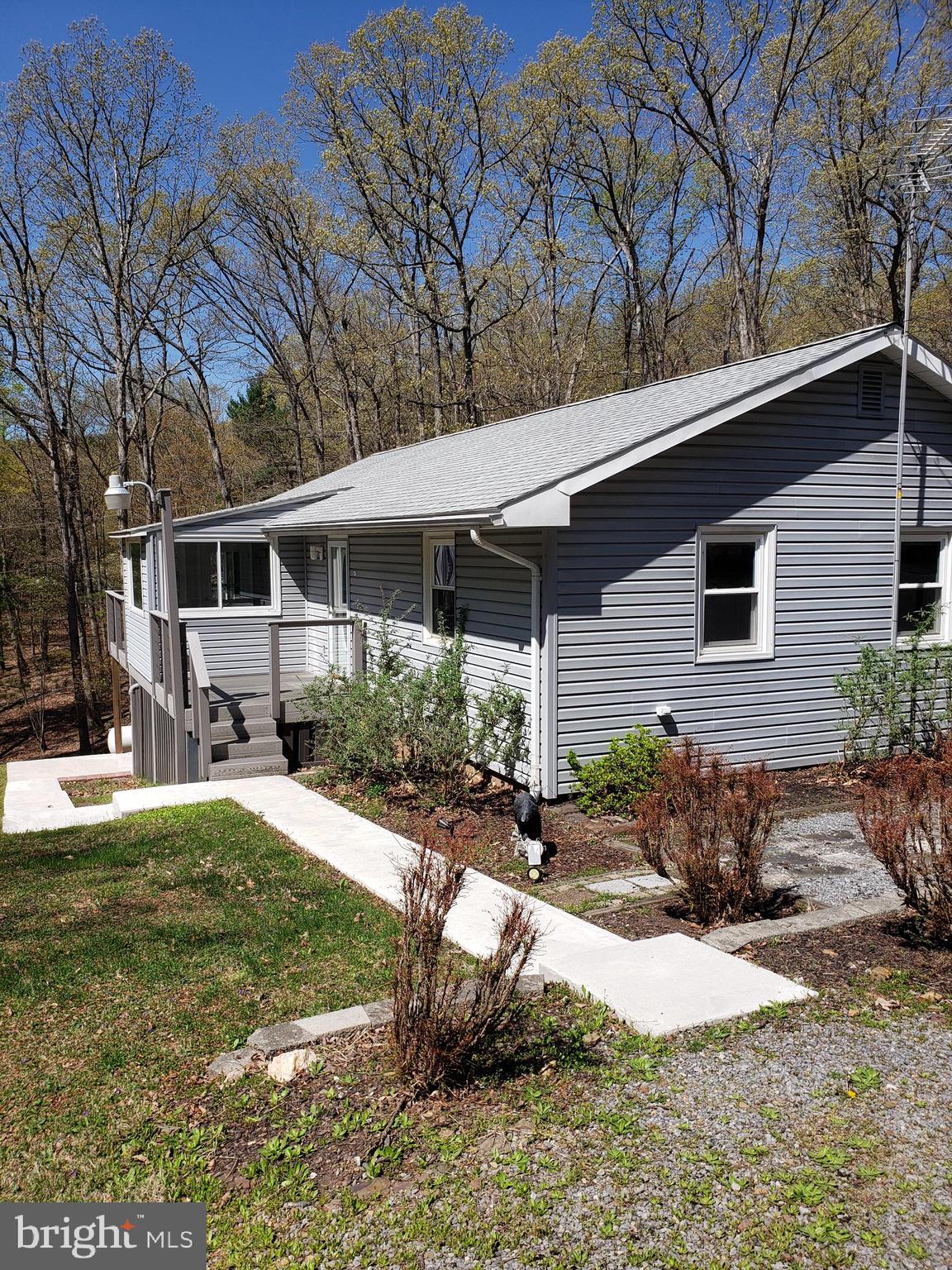 Back on the market, buyer unable to finalize financing.This lovely home on 3+ walkable mountain acres has much to offer.  Oversized rooms allows for plenty of space for everyone.  With two bedrooms and baths upstairs, a large living room with pellet stove that comes with a large screen tv, a 4 season room to let the outdoors in, nice workable kitchen that opens out to the composite deck for entertaining. The lower level offers another possible bedroom/ office/craft room, spacious room for either bar/game room, play area, or throw some sleep sofas in for the extra guests, this room opens to a patio. Detached 2 car garage, and a storage shed for the water toys and any garden equipment. Have a fire pit to sit around in the evenings for the required s'mores and hot chocolate or adult beverages.  Relax in the mountains and enjoy life.  About 3/4 miles to the private community access on the clear, clean Cacapon River for tubing, kayaking, fishing and just playing.  Motivated seller