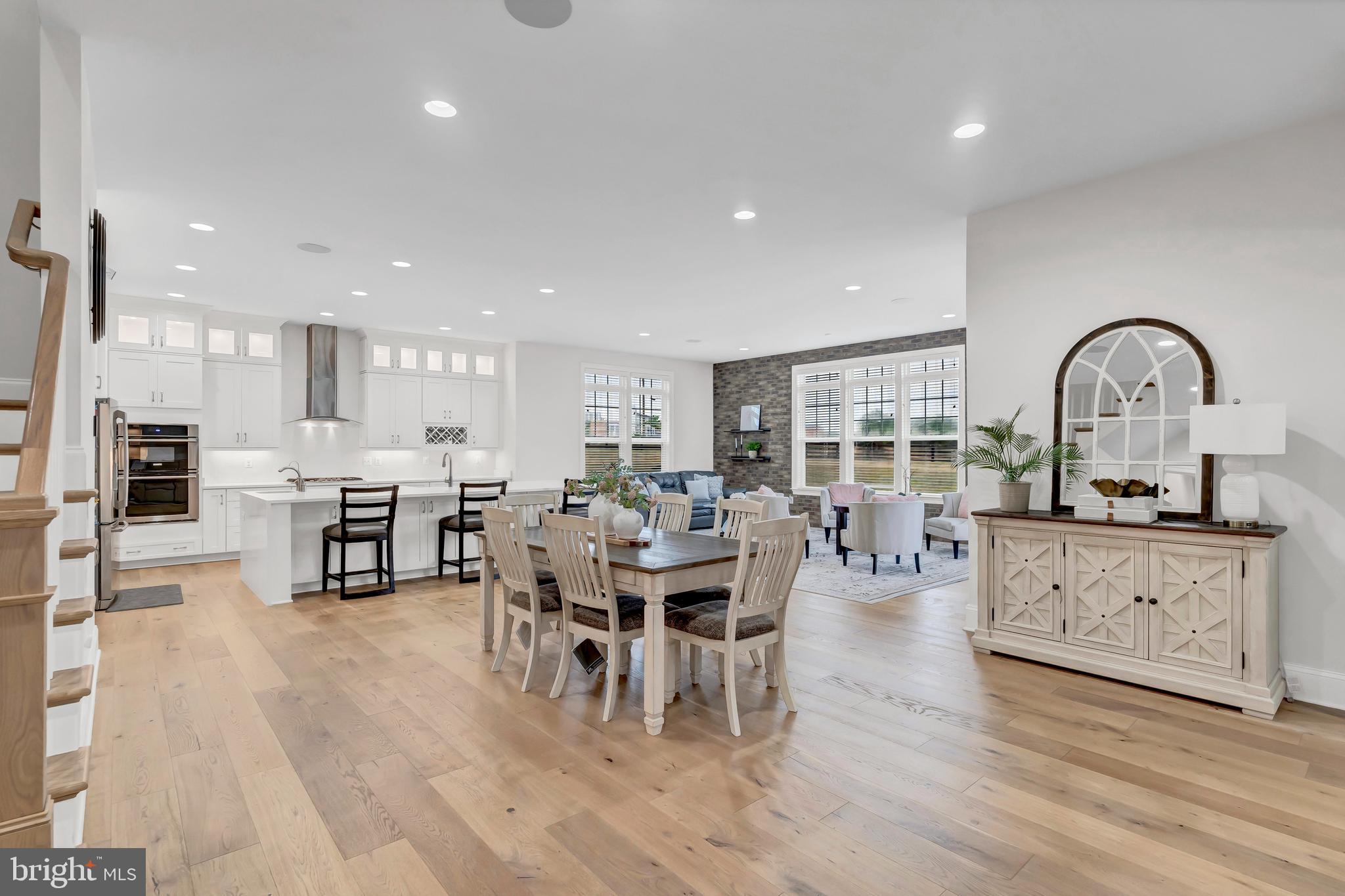 An Amazing Opportunity in Aldie!!!  Welcome to this exquisite home boasting a plethora of modern upgrades designed for luxurious living and convenience.   Located in the highly desired Lightridge High School cluster which includes Willard Middle School and two amazing elementary schools.  Henrietta Lacks ES (K-2nd grade) and Hovatter ES (3rd-5th grade).  This Stanley Martin Travers Home Model is one that boasts just over 9,700 square feet, has a bonus fourth floor loft, an open floor plan with tons of windows to bring in natural light, and high ceilings throughout.  

As you enter the main level foyer you will be welcomed by stunning 9 " wide plank Oakwood floors throughout, 10 foot ceilings, custom crown molding and framing, as well as multiple built-in cabinetries for extra storage.  The formal dining area includes updated light fixtures, crown molding, shadowbox accent walls with chair railing, and plenty of space for a large table.  To your right you will see the living room that can be converted into a main level home office which features a gorgeous shiplap accent wall.  

Making your way past the foyer you will experience the brilliance of design as the home truly opens up in its one-of-a-kind floorplan.  Be in awe of the stunning coffered ceilings in the family room which also offers a modern fireplace, recess lighting, and built-in butler's pantry to use while entertaining guests.  The enormous gourmet kitchen is the focal point of this home as it features a huge breakfast area with brick accent wall, an expanded waterfall island with quartz counter tops, state of the art stainless steel appliances with dual dishwashers and double wall ovens, top glass door cabinets for a sleek and modern look, under cabinet lighting as well as interior cabinet lighting, shaker cabinets, and a spacious walk-in pantry to store plenty of delicious food.  While entertaining guests in the kitchen, make your way outside onto the massive trek wood deck that steps down to the stone patio below.  Enjoy quiet nights outside by the firepit admiring views of Bull Run Mountain and the surrounding aesthetics of Aldie, VA.

Other features on the main level include a main level bedroom with private en suite bathroom, a butler's pantry with wine fridge, a large mudroom with organizers to keep the family's belongings intact, a private powder room, and two stairways to reach the upstairs bedroom level.

The spacious walkout basement is a versatile space that can be used for multiple purposes.  Enjoy evenings with friends and family in the comfy recreation area that offers a full bar when serving company.  The full bar is any homeowner's dream with its white quartz counter tops, custom shaker cabinets, dishwasher, mini refrigerator, walk-in pantry that can be converted into a wine room, and butler's sink.  Watch movies in your very own movie theatre.  The three level home theatre room is conveyed along with screen, projector, and High-end Bang & Olufsen ceiling speakers for an unparalleled audio experience.  

Relax and unwind in the huge primary suite on the third level.  The primary suite is accompanied by 9 inch wide plank Oakwood floors, a sitting area to enjoy your show in privacy, a spa-like bathroom with dual vanities, expanded shower with bench, soaking tub, and multiple shower heads, and lastly, utilize the enormous walk-in closet that is the size of a small apartment.  Each bedroom has its very own bathroom en suite along with a walk-in closet.  Lastly, the bedroom level also features a spacious laundry room and a homework center for the kids.

One of the most unique and special features of this home is the fourth-floor loft with rooftop terrace.   This private space can be used as a guest apartment, private guest suite, small business office, or whatever your heart desires.  Along with the amazing rooftop terrace, the loft includes a full bathroom, guest bedroom, wet bar, and spacious den.

Don't miss this incredible opportunity!