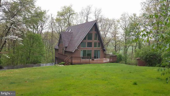 Nestled on 1.68 wooded acres in Ontelaunee Township, this custom-built home offers the perfect blend of privacy, nature, and convenience. The stunning two-story great room features soaring cathedral ceilings, a floor-to-ceiling stone fireplace, and an abundance of natural light from the dramatic wall of windows, creating a warm and inviting living space. The main level offers two bedrooms, a full bath, an eat-in kitchen, and the convenience of first-floor living. Upstairs, the loft, complete with a second floor-to-ceiling stone fireplace, overlooks the great room and leads to a private third bedroom suite with its own full bath, making it an ideal space for guests, a home office, or a private retreat. Outside, enjoy the peaceful wooded setting from the wraparound deck, perfect for entertaining or relaxing while taking in the surrounding nature. The home also features a spacious driveway with ample parking for multiple vehicles, a large garden area along the walkway, and lawn and garden shed in the back with electricity that provides for extra storage and workspace. Additional highlights include an oversized two-car garage with workshop space, central air, public sewer, and a partially finished full basement offering a bonus room, ample storage, and endless possibilities. Located in the highly sought-after Schuylkill Valley School District, this one-of-a-kind property offers the tranquility of a private setting while remaining just minutes from major routes, shopping, dining, and everyday conveniences. Priced at just $415,000, this home offers exceptional value and won't last long. Schedule your private showing today! Professional photos coming soon!
