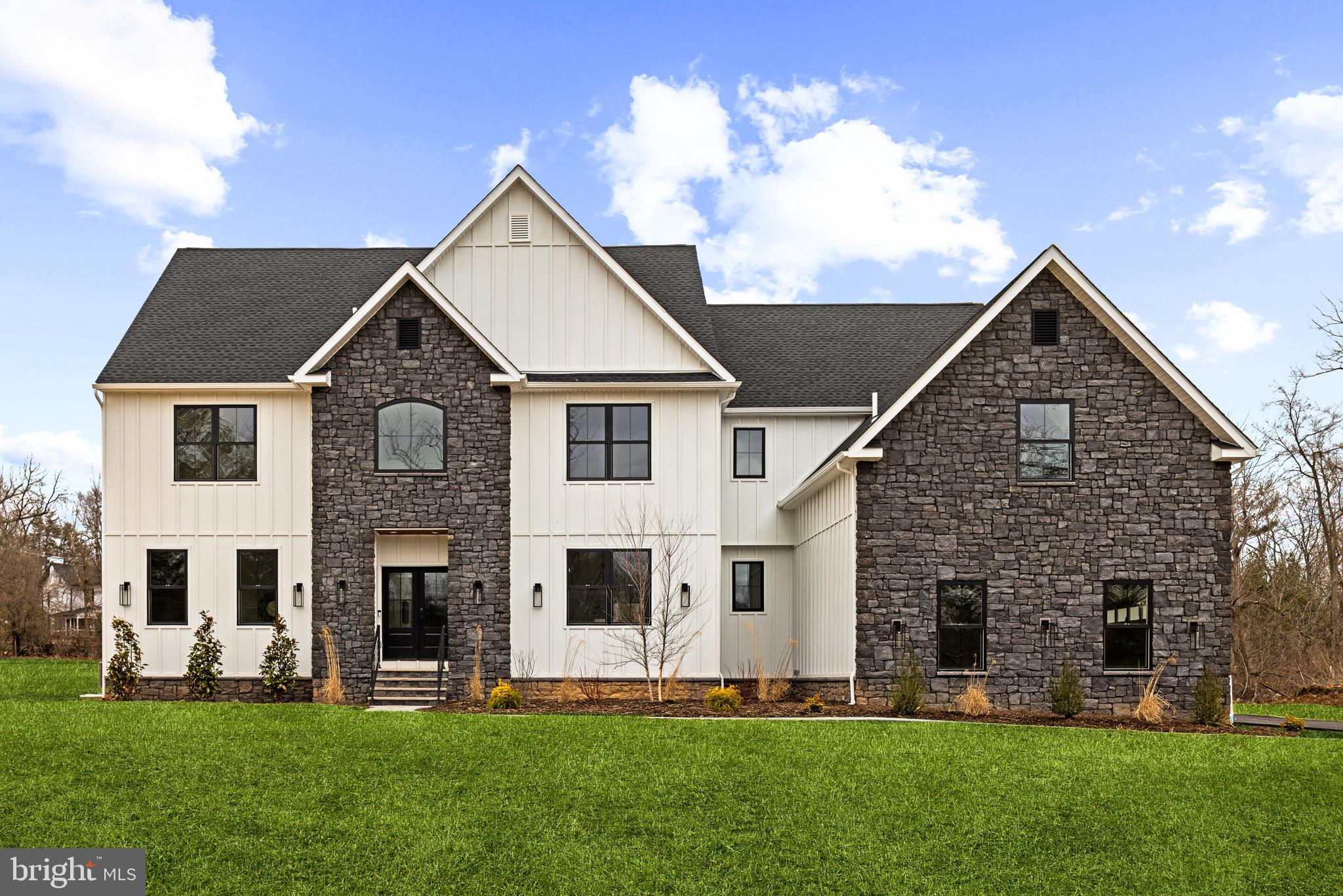 Reimagined  with extensive feedback, TENNIS POINTE continues to stand as an unrivaled testament to exceptional design, now elevated further in its new and improved Phase II iteration. Seamlessly blending the timeless elegance of Modern Colonial architecture with the rustic charm of Farmhouse aesthetics, each Phase II home offers an even more expansive floor plan than before, with every room thoughtfully enlarged for enhanced comfort & luxury. Undeniably striking, these extraordinary residences are perched atop a raised elevation, their pristine white façades accented with bold stone details. A limestone porch, accessed via a pedestrian path, welcomes you to the entrance, where you are greeted by a towering foyer. Long Leaf Acacia hardwood floors frame a stunning central staircase, setting the tone for the home's grandeur. To the left, the living room captivates with an abundance of windows inviting natural light, intricate trim work, & a breathtaking gas fireplace encased in floor-to-ceiling stone. Across the foyer is the massive formal dining room. Next, you will find a pantry with an added butler prep area. The kitchen, one of three defining focal points of this Phase II residence, is a masterpiece of form and function. Anchored by an oversized island with a waterfall edge, it features Italian Aster Cucine custom cabinetry with marble countertops, Bertazzoni stainless steel appliances—including a professional-grade 6-burner gas oven/range with hood and a JennAir® panel-ready refrigerator—& elegant pendant lighting. A beautifully tiled mudroom offers access to the side-entry door, expansive 3-car garage, and uniquely appointed private study. Featuring intricate trim work, wall sconces, and a refined ambiance, the study offers a dedicated space. Beyond the breakfast area, the great room unfolds with soaring two-story ceilings and a two-story window array, flooding the space with natural light and creating a harmonious connection to the outdoors. The main level also features a proper first-floor bedroom suite, complete with a walk-in closet and a private bathroom showcasing a frameless glass shower and majestic large-format tile. Ascending the staircase, you arrive at an open loft area that bridges the bedrooms. Two bedrooms share a Jack-and-Jill bathroom, designed with a custom floating vanity & an extra-deep tub/shower. Nearby, the laundry room is equipped with a built-in linen closet, sink, and quartz countertop for added convenience. A princess suite, with a spacious walk-in closet & en-suite bath, also offers a unique addition to Phase II. The princess suite now features access to a mezzanine, providing an elevated retreat within the home. Through French doors lies the primary suite, the second focal point of this enhanced Phase II home. This sanctuary is distinguished by a chandelier suspended from a lofty cathedral ceiling, a shiplap-clad feature wall, & two custom-organized walk-in closets. A massive balcony, exclusive to Phase II, extends from the primary suite, offering breathtaking views of the backyard. The primary bathroom is a true spa-like retreat, adorned with immaculate large-format tile. A private water closet, colossal double vanity with a dedicated makeup table, a freestanding soaking tub, and a walk-in shower with custom glass & multiple showerheads complete this oasis. The entertainment-driven lower level, the third focal point, is designed for leisure and enjoyment. It features a media room, game room, fitness area, & a full bar. An additional sixth bedroom provides accommodation for guests or family, while yet another full bathroom & walkout stairs to the backyard enhance functionality. Other exceptional features include high-efficiency dual-zone HVAC systems with NEST thermostat controls, Andersen windows, Therma-Tru exterior doors, a professionally curated landscape package, & more. TENNIS POINTE, in its new and improved Phase II form, is not merely a home—it is a masterpiece of modern luxury.