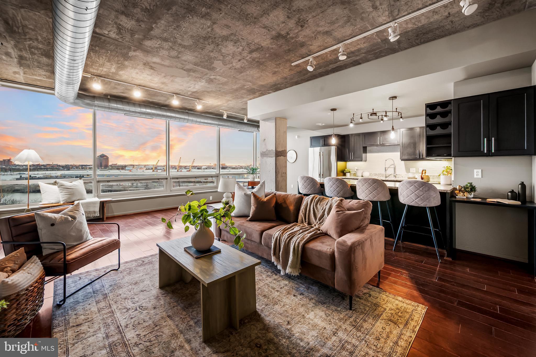Perched high above the glistening waters of the Patapsco River, this rarely available water view home at Silo Point presents a unique opportunity to reside within one of the city’s most iconic structures—thoughtfully transformed for elevated, contemporary living.

Silo Point began its story in the 1920s as the Baltimore and Ohio Locust Point Grain Terminal Elevator—a towering symbol of industrial innovation and the city’s bustling maritime history. Today, it stands as a bold fusion of heritage and luxury, reimagined with striking architecture, expansive glass, and refined interior finishes—each element carefully curated to deliver a sense of modern sophistication.

From the moment you enter, you're greeted with sweeping, unobstructed vistas that stretch across the harbor to the city skyline. Watch the sunrise paint the water in soft pinks from the comfort of your bed, and wind down each evening as the golden glow of sunset reflects off the river—visible from your living room or private outdoor deck. This is more than a view; it's a breathtaking backdrop to everyday life.

This one bedroom, two bath residence features an open-concept layout with soaring ceilings, a beautifully appointed kitchen with updated appliances and premium countertops, and a spacious living area designed for both comfort and entertaining. The serene primary suite includes a walk-in closet and spa-style bathroom with soaking tub, separate shower, and dual vanities. A powder room and in-unit washer and dryer add everyday ease.

For those working remotely, you’ll have access to high-speed internet and a sleek conference room. When it’s time to host, the building’s signature Sky Lounge is unmatched—a stunning rooftop space with a kitchen and expansive outdoor deck, offering the best views of the harbor and skyline, sure to impress your guests.

Included with the home are two assigned garage parking spaces and a private storage unit, offering both convenience and flexibility. Silo Point also features 24-hour concierge and front desk service, a state-of-the-art fitness and wellness center, yoga studio, game room, wine vault, and secure building access. Optional concierge services include laundry pickup, housekeeping, pet care, and more.

Located in vibrant Locust Point, you're steps from restaurants, cafés, parks, and the Water Taxi or Charm City Circulator—connecting you effortlessly to Baltimore’s top waterfront destinations. Don’t miss your chance to call this rarely available water view gem your own!