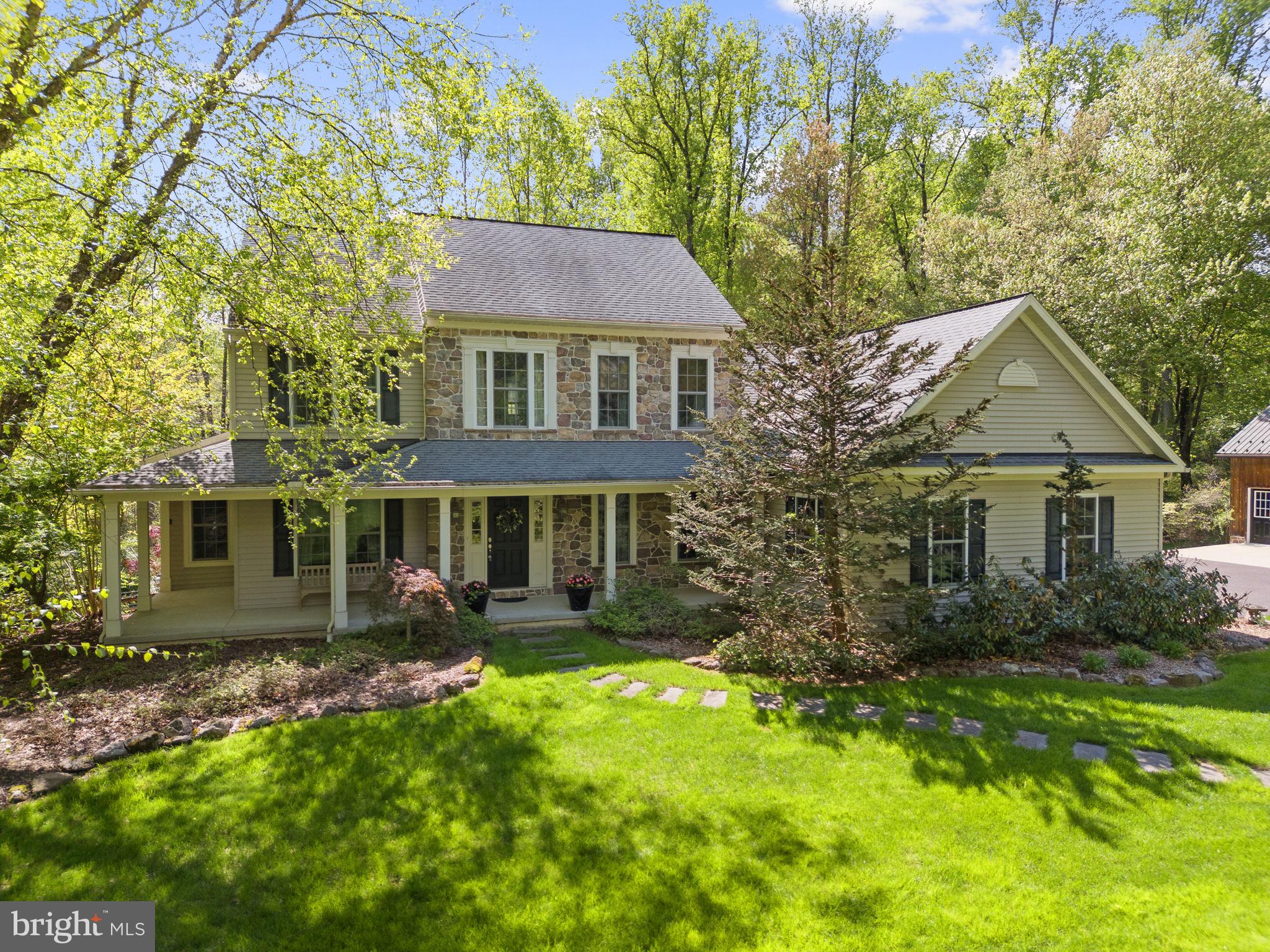 Welcome to 2881 Chestnut Hill Road! This beautifully maintained stone-front colonial, located in bucolic South Coventry Township in desirable Owen J. Roberts School District, is just a quick drive to Saint Peters Village and French Creek State Park. Set on a peaceful, 8.1 acre, wooded lot this home offers low yard maintenance, tons of privacy and plenty of room to enjoy the outdoors. A welcoming covered front porch and classic architectural details create immediate curb appeal, while the property also features a stunning detached barn-style garage with three bays that includes heat and electric—ideal for car enthusiasts, or additional storage. Inside, a bright two-story foyer with hardwood flooring and a turned staircase creates an elegant first impression. The traditional floor plan includes a formal dining room with large windows overlooking the front yard, along with a private study with French doors—perfect for a home office. Just beyond, the spacious family room is anchored by a floor-to-ceiling stone fireplace and surrounded by windows that bring in natural light and wooded views. The heart of the home is the open kitchen and breakfast area, featuring warm wood cabinetry, generous counter space, center island seating, and a sunny breakfast nook. The adjoining sitting area provides a comfortable space to relax while enjoying views of the backyard and direct access to the expansive rear deck—an ideal setting for outdoor dining, grilling, and entertaining while overlooking the surrounding trees. The spacious first floor primary suite offers a peaceful retreat with a large bedroom, private sitting area with a gas fireplace, two walk-in closets, and an en suite bathroom complete with double vanity, soaking tub, and separate shower. The first floor is completed by a craft room or second home office, half bathroom and laundry room plus access to the attached two-car garage. Upstairs, two additional bedrooms share the full bath while the third junior suite offers a private full bathroom providing plenty of space for family or guests. The unfinished walk-out lower level offers excellent storage and future finishing potential for additional living space or a home workshop. The basement has hook ups for additional lighting, welder and air compressor for the hobbyist. The home also includes a whole house generator! 2881 Chestnut Hill Road is a rare combination of classic style, flexible living space, and exceptional outbuilding storage in a tranquil setting.