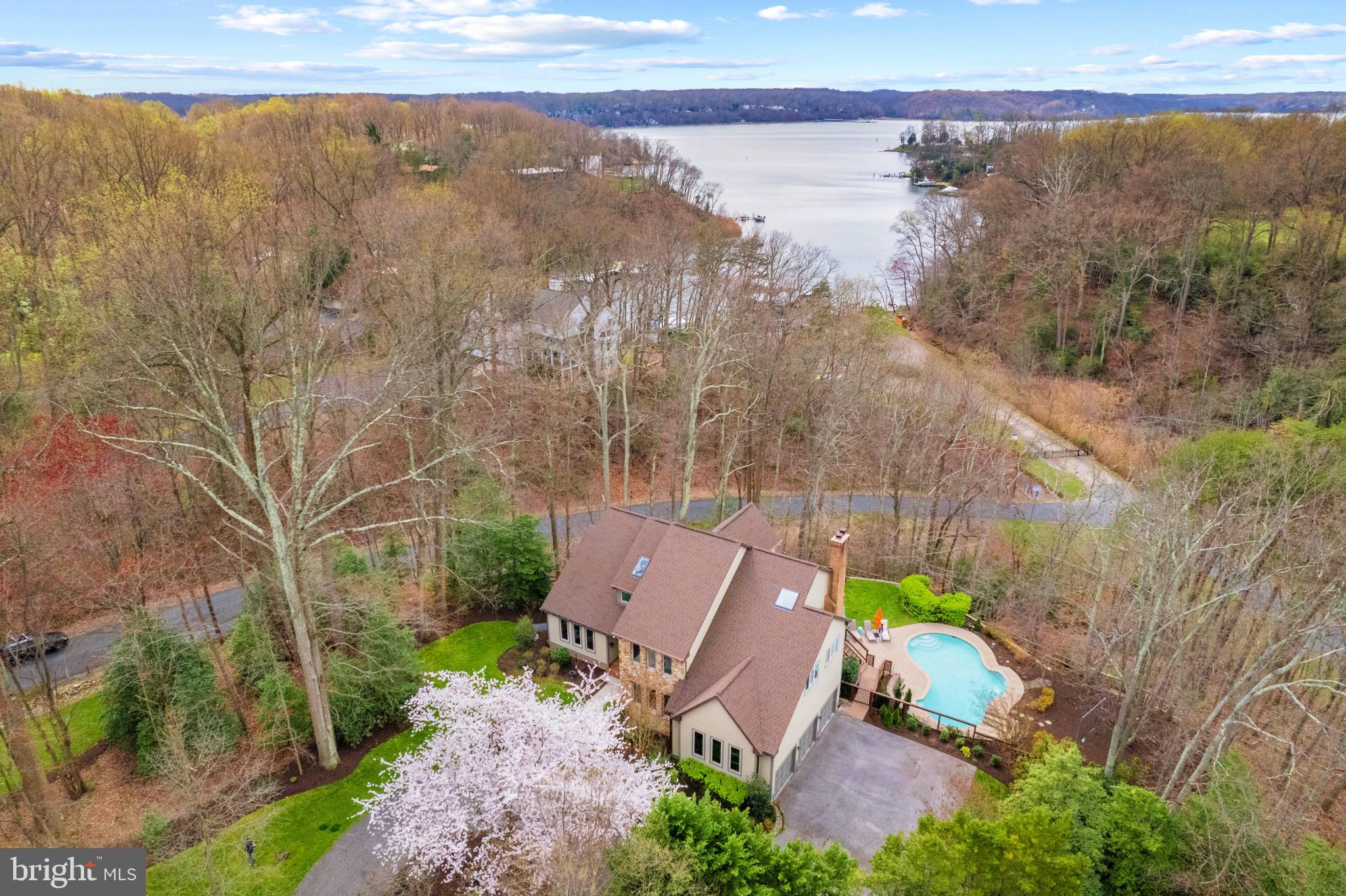 Stone and cedar contemporary home with saltwater pool is perfectly sited on 1.42 wooded acres overlooking the majestic Severn River across Asquith Creek. This spectacular 5 bedroom, 5 full bath home is located in the sought-after community of Severn View and comes with a deeded boat slip (#3) at the community marina just steps from the property. With over 6,000 sqft of living space on 3 levels, this magnificently remodeled home is sure to please! Upon entering into the grand 2 story foyer with curved staircase, the open floor plan with Brazilian walnut floors flows from formal living room and formal dining room to the beautifully renovated (2016) gourmet kitchen and cozy family room with wood burning fireplace. The light and bright kitchen delights with white cabinets, quartz counters, island with seating, and high end appliances; well-equipped for even the most experienced of chefs. Enjoy the serene sounds of the waterfall into the refreshing pool and the scenic water views from the rear deck spanning the width of the exterior and accessible from the dining room and family room; great set-up for entertaining or relaxing. Completing the main level is a guest suite (currently being used as home office) with adjacent full bath; great flexibility for family and guests of all ages. Head up the stairs to the Primary's wing and enjoy the spacious primary bedroom suite with fireplace, private balcony and luxurious renovated spa-like bath with double vanity, freestanding soaking tub, walk-in shower and large closet. Three additional bedrooms including 1 with ensuite bath and 2 with shared bath, provide plenty of room. The finished lower level with direct access to the stunning pool is an entertainer's or kid's dream with a kitchenette, bedroom/exercise room, office, full bath and spacious rec room with plenty of room for games. Completing this coveted property is the oversized 3 car garage with soaring ceilings for maximum storage, circular driveway, playground area adjacent to pool deck and tons of privacy. Enjoy the watermen's lifestyle at Severn View's newly renovated, gated community waterfront with pavilion, firepit, playground, kayak storage, boat ramp, piers and your deeded boat slip! Award-winning schools, close to B&A bike trail and easy commute. Welcome Home!