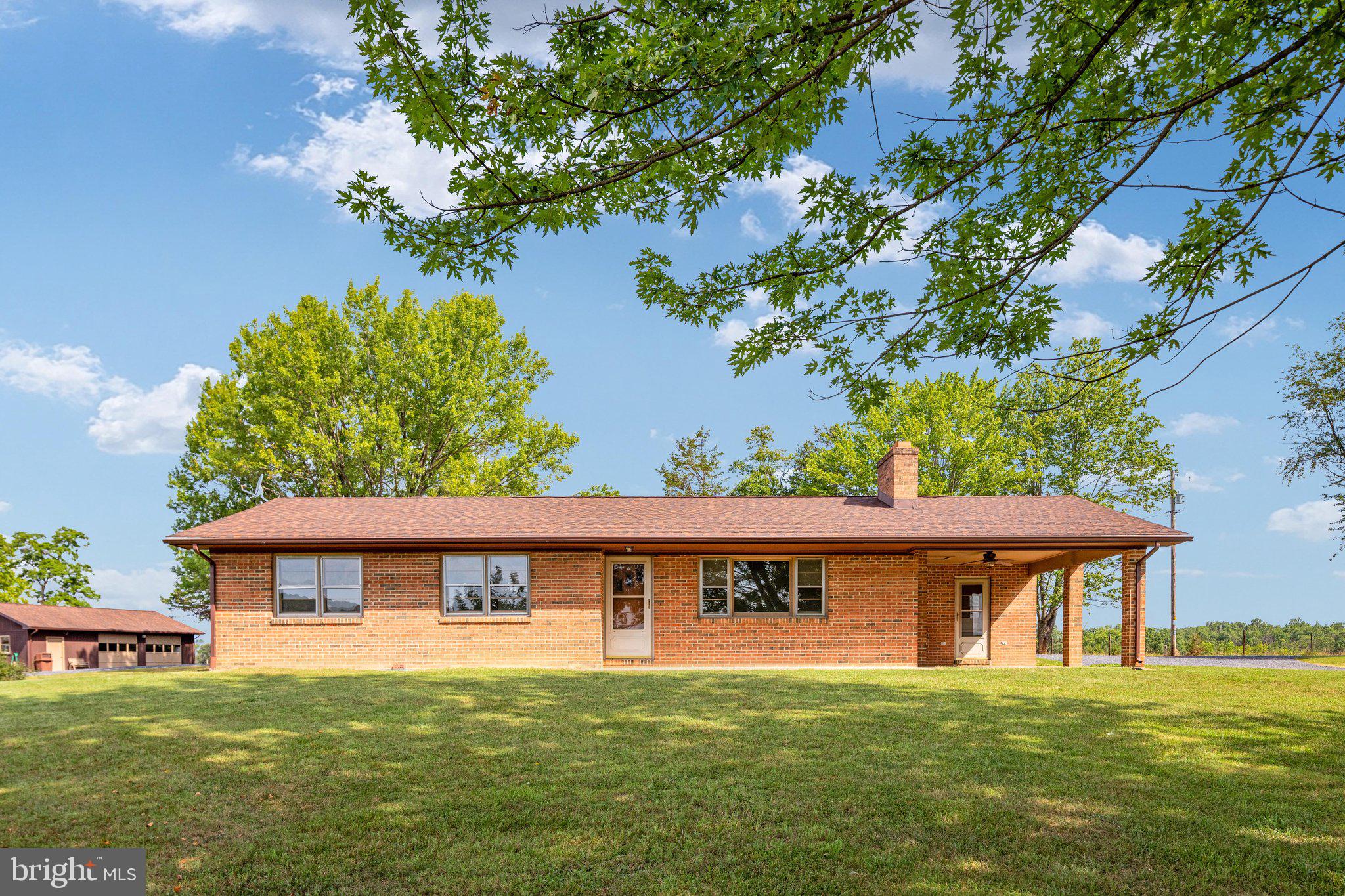 If you've been searching for a peaceful country retreat with breathtaking mountain views and privacy, look no further. Situated on two parcels totaling 17.07 acres, this 4-bedroom, 3-bath ranch offers the perfect blend of comfort, recreation, and natural beauty. The spring-fed pond, supplied by three natural springs, is stocked with catfish, sun perch, and both largemouth and smallmouth bass—perfect for fishing right in your own backyard.

The home features 1,372 finished square feet on the main level, along with a partially finished basement that provides additional living and storage space. Inside, you'll find beautiful hardwood floors, a wood-burning fireplace in the living room, and a wood insert in the basement for cozy evenings. Enjoy your morning coffee or relax on the covered porch at the end of the day, taking in the peaceful pond and mountain views. Additional features include a central vacuum system, water softener, built-in grill on covered porch, and a roof that is only four years old with durable 50-year architectural shingles, plus gutters and gutter guards.

Outside, the 28' x 40' detached garage is equipped with 200-amp electrical service and a wood-burning stove, making it an ideal workshop, hobby space, or place to store vehicles and equipment. A 5-bay equipment shed (approx. 50x24) with electricity and lighting provides even more space for equipment, recreational vehicles, or additional storage.

Built in 1972 and meticulously maintained, this property is ready for its next owner. With no HOA, plenty of room to roam, and a private road maintained cooperatively by the property owners who use it, this is a rare opportunity to enjoy peaceful country living surrounded by the beauty of the mountains.